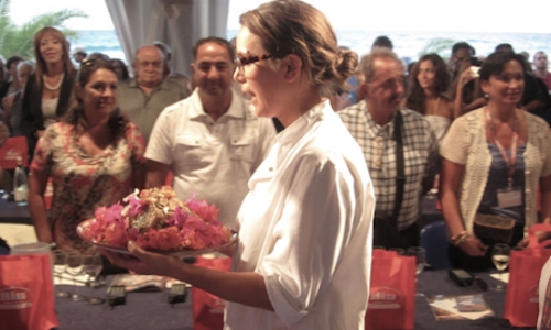 Alice Delcourt, la signora dell'Erba Brusca a Milano, telefono +39.02.87380711, mentre sfila, settembre 2011, alla finale del Cous Cous Fest a San Vito Lo Capo in Sicilia. Nel vassoio il suo vittorioso Sgombro affumicato su un cous cous di frutta ed erbe. Il 16 aprile proporr&agrave; il Cous cous di agnello brasato con cipolle al miele, uvetta, mandorle e spezie grazie al quale si &egrave; imposta anche nell'edizione 2012 del Cous Cous Fest