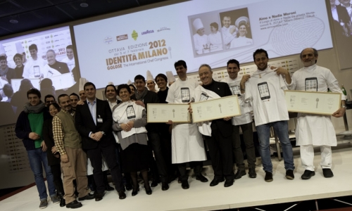 I festeggiamenti dei 50 anni del Luogo di Aimo e Nadia a Identit&agrave; Milano 2012: Massimiliano Alajmo e Corrado Assenza hanno omaggiato Aimo e Nadia Moroni con una loro personale versione dello Spaghetto al cipollotto e peperoncino, il piatto storico riproposto sul palco da Alessandro Negrini e Fabio Pisani, chef in cucina al Luogo