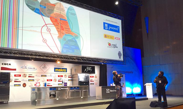 Quico Sosa durante il suo intervento a Madrid, mentre espone un complesso grafico che rappresenta le diverse "età della cucina"