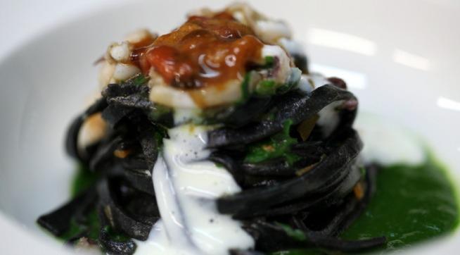 Ripiddu nivicatu, uno dei piatti simbolo dello chef Andrea Macca, de La Cucina di DonnaCarmela, ristorante gourmand dell'omonimo resort a Riposto, il porto dell'Etna, provincia di Catania. L'impiattamento rievoca il vulcano: bisque di scampi sotto pasta fresca impastata con il sugo di nero di seppia, ragù di seppia con infuso di tè lapsang souchong, sopra scampi e seppie appena scottate