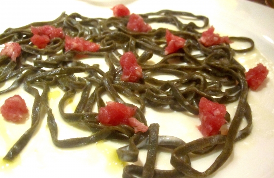 Galleria fotograficaSpugne di pane aromatizzate
Dopo il consueto pre-appetizer delle verdure disidratate (primo contenitore), arrivano le spugne, seconda parentesi colorata che rallegra il pasto dall&rsquo;inizio. In questo caso sono aromatizzate agli spinaci e uova di salmone; alla cipolla cotta al forno con terrina di vitello e alla curcuma con lardo. &laquo;Ma le combinazioni possono essere infinite&raquo;, spiega Matteo Baronetto, braccio destro di Carlo Cracco, &laquo;si possono utilizzare anche in pasticceria al cocco, ai lamponi&hellip; La tecnica &egrave; mutuata da Ferran Adri&agrave;. Abbiamo cercato di personalizzarla nel gusto. A me ricordano molto i canap&egrave; della tradizione piemontese. Senza maionese naturalmente&raquo;. Vivacit&agrave; cromatica ulteriormente ravvivata da un terzo contenitore di foglie di shiso e fiori di zucchina in tempura con riso venere e riso ai piselli fritto (che non vedete perch&eacute;, ahinoi, la foto &egrave; venuta male)Lamponi e sambuco
Nella girandola di appetizer spiccano questi piccoli lamponi farciti con infusione di sambuco serviti sul ghiaccio. &laquo;I suoi fiori in questi giorni li senti anche a Milano, passeggiando al parco. Un odore forte e piacevole. Stiamo lavorando allo stesso concetto anche con le fragole, i mirtilli, il ribes o i gelsi. Un'idea che interpreta quella tradizione sudamericana che ribalta l'ordine delle pietanze, con la frutta all'inizio del percorso, un po' come gi&agrave; succede con la nostra insalata russa caramellata. Sposa nota fruttate e speziate. Ma al posto della frutta potrebbe starci benissimo un'oliva, perch&eacute; no?&raquo;Panino al seitan con insalata e tartufo nero
Un panino di seitan dal contenuto variabile: al congresso di Identit&agrave; Milano 2012, sede della sua anteprima, c&rsquo;erano songino, fiori di piselli e lingua. &laquo;Sono masse di seitan da 15 grammi messe a cuocere nel micro-onde a 90 watt. Il calore fa lievitare il glutine tipo quasi alla maniera del vetro soffiato. L&rsquo;ispirazione ci &egrave; venuta da una ricetta di Simone Salvini letta sul sito di Identit&agrave; Golose&raquo;. A Milano la lingua cancell&ograve; l&rsquo;apparente connotazione vegana del piattoOstriche, crema di piselli e menta
&laquo;Ostriche con semplice crema leggera di latte e piselli messa nel sifone. Combina lo iodato dell&rsquo;ostrica, la dolcezza dei piselli e la freschezza dei menta. La puoi aggiungere anche sui tartufi di mare&raquo;Uovo di quaglia affumicato al rosmarino e prezzemolo bollito
&laquo;L&rsquo;uovo di quaglia viene bollito e pelato. Il tuorlo &egrave; laccato con gelatina di latte ai capperi. Le due met&agrave; dell&rsquo;albume sono arricchite con crema leggera di prezzemolo bollito. C&rsquo;&egrave; una nota affumicata al rosmarino, che gli diamo prima di farcire. &Egrave; un piatto che ricorda un po&rsquo; le uova sode ripiene&raquo;. Giusto il ricordoFoglie di shiso rosse e verdi con gambero e melassa di cipolla
&laquo;Un gambero (ligure, e quindi pi&ugrave; piccolo di quelli pescati in Sicilia) viene posto tra due foglie di shiso a carpaccio, tagliato e tenuto in frigo per 8 ore in modo che gli elementi si compenetrino d&rsquo;aromi l&rsquo;un l&rsquo;altro. La melassa &egrave; ottenuta invece stracuocendo in forno la cipolla, che si addenser&agrave; sfruttando i suoi zuccheri naturali. Completa l&rsquo;opera il nero hawaiano, un sale minerale, vulcanico. E un tocco di burro fuso per aiutare la balsamicit&agrave; dello shiso a esprimersi&raquo;Orata cotta appena su croccante di nocciole
&laquo;Il croccante viene messo in forno per 3 minuti. Tirato fuori, gli si poggia sopra il sashimi di orata, che 'cuocer&agrave;' cos&igrave; acquisendo la nota dolce dell'olio naturale del croccante&raquo;. Una sorta di sashimi alla piemontese. Vietato mangiare il croccantino sottostante perch&eacute; altrimenti l'orata non si sente. Semmai dopo...Salmone marinato e foie gras
Piatto in carta da Cracco pi&ugrave; o meno da un anno, &egrave; un inno all&rsquo;opulenza e alle note grasse. &laquo;Volevamo dare una variante allo stra-classico salmone col burro spalmato sul crostino&raquo;, spiega Baronetto.&nbsp;Il boccone del salmone senza foie gras deve rimanere per ultimo &laquo;senn&ograve; l&rsquo;avremmo chiamato foie gras e salmone&raquo;Gamberi, nocciole cotte e sambuco
La fonte d'ispirazione c'&egrave; ma proprio non si vede: &egrave; la celebre passatina di ceci con gamberi di Fulvio Pierangelini.&nbsp;&laquo;Casualmente ci siamo accorti che la nocciole, se bollite e messe per breve tempo in forno, prendono la consistenza dei ceci, o comunque di un legume&raquo;. L'ulteriore nota distintiva dal masterpiece pierangeliniano sono il sambuco e le foglie di rucola: &laquo;danno una nota agliacea e leggermente piccante che a me piace molto&raquo;Lattume, fagiolini, acetosella
Un piatto all'apparenza hardcore (il lattume &egrave; lo sperma delle gonadi del tonno maschio), stemperato dalla presenza di foglie di acetosella e da fagiolini liguri pelandroni, specie molto pi&ugrave; tenera delle taccole.&nbsp;&laquo;Li abbiamo cotti nel t&egrave; Lapsang Souchong per dare loro una nota affumicata. Questo aiuta a lenire il sapore densissimo del lattume, appena scottato. Per certi versi questo piatto mi ricorda un po' il filone di vitello piemontese, col midollo della spina dorsale. E' un modo per valorizzare una primizia, il lattume, che in queste settimane, coi tonni che invadono il Medterraneo a scopo riproduttivo, &egrave; fantastico&raquo;