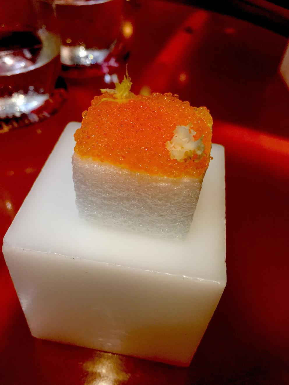 Galleria fotografica






Consommè de garbanzos. Prima che cominci il menu degustazione, viene portata al tavolo una bottiglia di vetro contenente del brodo freddo di ceci (in alto a destra). Ventitrè piatti dopo, alla fine del percorso "salato", verrà versato, in un bicchierino da grappa, del brodo caldo di jamon iberico da una teiera. Sopra ancora, la schiuma del brodo di ceci. Un caldo-freddo speciale (foto @ticketsbar instagram)









Tosta de pollo y anchoa. Primo piatto: toast di pelle di pollo con lisca di acciuga. A lato, una crema di acciughe composta da burro e pasta di acciughe









Olive Gordal. Uno dei simboli della saga Adrià: le olive sono immerse in un liquido d'olio extravergine d'oliva, cannella, buccia di limone e anice stellato. Si tirano su con un cucchiaino forato, si poggiano su una conchiglia di legno a lato e da qui in bocca. Gordal è una varietà dall'Andalusia









Prima preparazione rifinita al tavolo: Polo de almendras









Polo de almendras è uno stecco di gelato al latte di mandorle, spennellato sul posto con olio d'oliva e cosparso con granelle di mandorle, fiori di sambuco e sale. E' servito su un piatto con cubetti di ghiaccio. Dolce(salato) e gelato all'inizio del pasto e non alla fine, uno schema molto Adrià









Coliflor y caviar. Ganache di cavolfiore e caviale russo Schrenkii









Gamba a la sal fría. Gamberi marinati nel tè Lapsang Souchong con zest di bergamotto. Sono serviti su un vassoio con "neve di sale" per ricordare il ghiaccio tipico di un mercato del pesce









Atún con cerezas. Tonno e ciliegia: ventresca di tonno confit in grasso di prosciutto, accompagnata da una ciliegia affumicata (senza nocciolo)









Ceviche de melón cantaloup. Ceviche di melone cantalupo con succo di lime, coriandolo e leche de tigre di kumquat. Servito con kumquat, olio di coriandolo e neve di kumquat. Citrico alla terza









Pizza crujiente. La "pizza" di Tickets: millefoglie di regañà (torta di pane croccante di origini andaluse), stracciatella, bottarga e fichi






