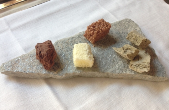 Galleria fotograficaCiocofoie
Un guscio di cioccolato 70% racchiude il ripieno di foie gras mi-cuit con qualche goccia di aceto balsamico tradizionale. Giusto per scaldare il motore
Alghe del nostro orto
Piatto border line, che gioca con una delle tecniche preferite dallo chef, quella della liofilizzazione e reidratazione, ne ha parlato anche a Identit&agrave; d&rsquo;Acqua, all&rsquo;interno dell&rsquo;ultima Identit&agrave; Milano. L&rsquo;insalata romana dell&rsquo;orto Zappatori viene prima liofilizzata e poi reidratata con succo d&rsquo;arancia, che le conferisce i muscoli agrumati necessari per reggere l&rsquo;impatto con una polvere di ostrica, gambero rosso e scampo.   Mica per tutti
Nuvola di barbabietola e toma Blu Cozie
Sbagliata sarebbe l&rsquo;impressione di un Milone-solo-uppercut. Dimostra invece un&rsquo;eleganza che pare essergli naturale (e pervade tutto il menu degustazione) con quest&rsquo;eterea meringa, lieve e friabilissima, texture davvero sorprendente che si sfalda appena al contatto della saliva rivelando le proprie dolci note vegetali. Deve per&ograve; fare i conti non solo con lo shiso, piacevole complemento, ma con un potente, delizioso blu che la prevarica. Il nostro pensiero &egrave; stato: si potrebbe cercare un abbinamento pi&ugrave; soave&hellip;
Aperitivo anni 80
Noccioline e crodino. Per&ograve; il secondo &egrave; passato per gli anni Duemila e ha conosciuto il pacojet, insomma gli Ottanta della Milano da bere sono da gustare ora al/col cucchiaio. Domina l&rsquo;amaro, sia metaforicamente (nel ricordo del bel tempo andato) che al palato
Pomodoro in conserva
Ancora liofilizzazione-reidratazione, con questo sherry che riceve un&rsquo;iniezione aromatica e poi viene bagnato al tavolo con un brodo vegetale. La puntura al pomodoro l&rsquo;abbiamo gi&agrave; vista (da Josean Alija ad esempio, indimenticabile, o da Eneko Atxa), qui il plus &egrave; la scelta del &ldquo;ripieno&rdquo;: lampone. Insomma: forti note dolci e acide, cui il brodo fa da contrappunto
Gambero rosso e te nero
Suadenze pi&ugrave; classiche per questi gamberi rossi battuti con erbe (basilico, timo limone, cedrina&hellip;), che diventano bonbon nappati con un gel di t&egrave; nero affumicatoCozze al nero
Piatto bellissimo e pure buonissimo, in realt&agrave; con richiami molto tradizionali (le classiche cozze irrorate con succo di limone). Qui sono farcite con un&rsquo;acqua ottenuta dalle stesse cozze e dalle nobili ostriche, poi gelatinata. La parte gradevolmente agrumata sporca il piatto, nell&rsquo;incontro tra salsa al lime e nero di seppiaVicciola cruda brasata al vino rosso
Godimento puro, il merito del quale va condiviso da Milone con la macelleria Pino di Torino, dove hanno &ldquo;inventato&rdquo; la vicciola, ossia una fassona cresciuta a nocciole (la sua alimentazione &egrave; composta da mais, crusca, fieno e nocciole, appunto). Unico allevamento, l&rsquo;azienda agricola di Giovanni Rossetti ed esclusivamente per la suddetta macelleria di via Cibrario, rese molto inferiori come quantit&agrave; ma tutto a vantaggio di una qualit&agrave; stupefacente. La carne ha un gusto dolce e delicato, prende consistenza morbida dovuta alla sua fibra oleosa. Milone la impiega come fosse una cruda all&rsquo;Albese, abbinandole un&rsquo;altra preparazione cult del suo Piemonte, il brasato, in realt&agrave; il fondo liofilizzato e poi polverizzato. Completa il superlativo piatto uno scalogno cotto nel microonde e poi bruciato in padellaLumache sambuco e birra
Altro piatto stellare, sorta di evoluzione della ricetta (Le lumache e la birra) con la quale Milone ha vinto il Premio Birra Moretti Grand Cru 2012. Le lumache, bottino di caccia di una notte nei boschi del Pinerolese, sono fritte dopo essere passate nella fecola di patata. Prima ancora erano state cotte in un brodo composto da succo di porro e birra, al 50% ciascuno, che viene poi ridotto con la farina di tapioca per farne una salsa di accompagnamento. Nel piatto si trova anche una schiuma ottenuta con aceto di vino rosso aromatizzato al sambuco e, specularmente, i fiori di sambuco messi sotto aceto, che puliscono e conferiscono acidit&agrave;. Armonia gustativa complessa, completa
Colombo, verdure, caffe e nocciola
A casa Zappatori si allevano i colombi, che poi finiscono sotto le nostre ganasce in due cotture: il petto &egrave; appena scottato, il filetto viene marinato nell&rsquo;olio di nocciola Pariani. Completano cipollotti e carote fermentati con tecnica redzepiana: sotto sale e cotti sottovuoto a 20&deg; per 48 ore, inacidiscono il giusto
Pasta alle erbe al pomodoro
Una classica pasta all&rsquo;uovo, met&agrave; tuorli e met&agrave; farina, nell&rsquo;impasto finiscono anche le erbe aromatiche. Tagliata a lasagnetta, cuoce in un&rsquo;acqua di estrazione del pomodoro, tecnica (si frullano i pomodori e poi la loro acqua viene raccolta per percolazione) raccontata a Identit&agrave; Milano applicata a un Risotto pomodoro e mozzarella. Si manteca con il burro, alla piemontese, ma sotto ci sono, nascosti, anche i cuori del pomodoro stesso e del pesto liofilizzatoRisotto arancia e vaniglia
Bel piatto di mezzo, tra universo salato e quello dolce: un risotto che guarda al Mediterraneo sia nell&rsquo;uso degli agrumi, sia nella vocazione a divenire dessert, manco fossimo in Spagna o Turchia. Il cereale viene mantecato con olio di arance rosse, il caviale che vedete nella foto &egrave; di sfere di olio al peperoncino, alla base c&rsquo;&egrave; una crema pasticcera alla vaniglia. Fiori a imbellettare il tuttoPrezzemolo, sedano levistico e... t&egrave; verde
Un lingotto semifreddo di cioccolato bianco e prezzemolo viene sormontato da: gelato al t&egrave; verde Matcha, sedano verde sbollentato, polvere di t&egrave; verde, polvere di semi di levistico, foglie di sedano e di levistico. PulitoMeringata
&laquo;Difficile dimenticare la meringata: una nostalgia rassicurante nella tenaglia fra la soavit&agrave; floreale e l&rsquo;aggressione amara del gelato di corteccia di magnolia&raquo;, ha scritto Alessandra Meldolesi sull&rsquo;ultima edizione della guida Identit&agrave; Golose