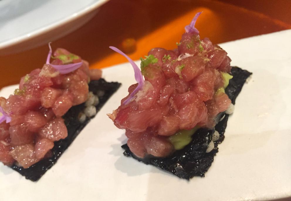 Galleria fotografica






Consommè de garbanzos. Prima che cominci il menu degustazione, viene portata al tavolo una bottiglia di vetro contenente del brodo freddo di ceci (in alto a destra). Ventitrè piatti dopo, alla fine del percorso "salato", verrà versato, in un bicchierino da grappa, del brodo caldo di jamon iberico da una teiera. Sopra ancora, la schiuma del brodo di ceci. Un caldo-freddo speciale (foto @ticketsbar instagram)









Tosta de pollo y anchoa. Primo piatto: toast di pelle di pollo con lisca di acciuga. A lato, una crema di acciughe composta da burro e pasta di acciughe









Olive Gordal. Uno dei simboli della saga Adrià: le olive sono immerse in un liquido d'olio extravergine d'oliva, cannella, buccia di limone e anice stellato. Si tirano su con un cucchiaino forato, si poggiano su una conchiglia di legno a lato e da qui in bocca. Gordal è una varietà dall'Andalusia









Prima preparazione rifinita al tavolo: Polo de almendras









Polo de almendras è uno stecco di gelato al latte di mandorle, spennellato sul posto con olio d'oliva e cosparso con granelle di mandorle, fiori di sambuco e sale. E' servito su un piatto con cubetti di ghiaccio. Dolce(salato) e gelato all'inizio del pasto e non alla fine, uno schema molto Adrià









Coliflor y caviar. Ganache di cavolfiore e caviale russo Schrenkii









Gamba a la sal fría. Gamberi marinati nel tè Lapsang Souchong con zest di bergamotto. Sono serviti su un vassoio con "neve di sale" per ricordare il ghiaccio tipico di un mercato del pesce









Atún con cerezas. Tonno e ciliegia: ventresca di tonno confit in grasso di prosciutto, accompagnata da una ciliegia affumicata (senza nocciolo)









Ceviche de melón cantaloup. Ceviche di melone cantalupo con succo di lime, coriandolo e leche de tigre di kumquat. Servito con kumquat, olio di coriandolo e neve di kumquat. Citrico alla terza









Pizza crujiente. La "pizza" di Tickets: millefoglie di regañà (torta di pane croccante di origini andaluse), stracciatella, bottarga e fichi









Porex de Calix. Marshmallow di dashi ripieno di crema acida e sormontato da caviale di Kalix, uova rosse svedesi di coregone, dalle note dolci ed eleganti









Nigiri de berenjena. Nigiri di melanzana









Cubo de wagyu. Cubo di chips di patata croccante con sopra una tartare di wagyu trattata con olio, sale, senape di Digione, uova e pepe. Una magnifica tapa da circa 2 cm per lato, che ricorda le battute al coltello della tradizione piemontese






