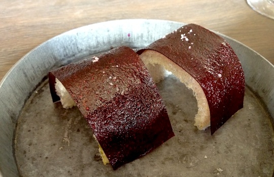 Galleria fotografica






In cammino verso il Noma. Il ristorante è al piano terra del palazzone più a sinistra. Per arrivarci dalla popolare insenatura di Nyhavn (il punto da cui è scattata la foto), occorre fare un bel giro. Ma si notano i lavori per la costruzione di un ponte. Che condurrà dritto all'insegna








Altra prospettiva sul Noma da Nyhavn. Il ristorante galleggia sulla Christianshavn, una delle tante isole artificiali che compongono Copenhagen








Di là del fiume, sulla lunga via che conduce allo spiazzo del Noma








Uno scenario molto tranquillo, di case pastello. Il silenzio è perché vanno tutti in bici













Al massimo si sente rombare qualche scafo








Il vascello davanti al Noma. Oltre a quella danese, sventolano le bandiere di Isole Far Oer e Groenlandia: le loro ambasciate sono nello stesso palazzo del ristorante. Coerenza nordica








Il retro del ristorante. L'80% delle 80 persone che lavorano al Noma viene a lavorare in bici, chef incluso








Dietro al ristorante, un'iscrizione ricorda i passeggeri scomparsi a bordo della danese Hans Hedtoft. Il transatlantico si scontrò il 30 gennaio 1959 contrò un iceberg in Groenlandia. Fu ritrovata solo una cintura di sicurezza
 








L'ingresso del ristorante, al civico 93 di Strandgade








La vista, ingresso alle spalle








Tra l'ingresso e la cucina a vista, spicca un corner di decoro simil-giapponese. A sinistra s'intravede Noma, time and place in Nordic Cuisine, edizioni Phaidon, un testo fondamentale per approfondire tutti i rivoli del Redzepi-mondo. La versione italiana si ordina qui








Una pianta di piccoli agrumi orla la cucina a vista








La porta d'ingresso vista dalla cucina








Le sedie, molto comode, sono anni Sessanta con schienali foderati di pelle di pecora, alcune più morbide di altre








I tavoli sono ampi e senza tovaglie. Attorno prevale il grigio e i colori rustici, sulle travi in legno del soffitto ma anche sulle divise dei ragazzi di sala








La finestra accanto al nostro tavolo








E' lo chef Rene Redzepi a introdurci al pasto: in un vaso di fiori danesi, l'unico pendaglio commestibile è una sorta di carta musica croccante (flatbread) di farina di malto all'aroma di ginepro. Nel piattino in basso, una deliziosa crème fraîche acida per intingerlo








Il flatbread è quello che svetta. "Ma se ci tenete, provate a mangiare anche i fiori", scherza Redzepi. Il cuoco scompare nelle segrete del Noma. Lo ritroveremo solo alla fine del pasto








Tutti i 14 appetizer si mangeranno con le mani. Unica posata, il coltello per tirar su e leccare la crème fraîche da sola (da fare quando tutti gli altri clienti son distratti, però)








Moss and Cep: Muschio di renna con polvere di funghi porcini. E' il corpo bianco, molto saporito ed evanescente, da intingere anch'esso nella crème fraîche
 





