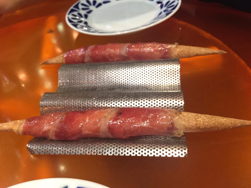 Galleria fotografica






Consommè de garbanzos. Prima che cominci il menu degustazione, viene portata al tavolo una bottiglia di vetro contenente del brodo freddo di ceci (in alto a destra). Ventitrè piatti dopo, alla fine del percorso "salato", verrà versato, in un bicchierino da grappa, del brodo caldo di jamon iberico da una teiera. Sopra ancora, la schiuma del brodo di ceci. Un caldo-freddo speciale (foto @ticketsbar instagram)









Tosta de pollo y anchoa. Primo piatto: toast di pelle di pollo con lisca di acciuga. A lato, una crema di acciughe composta da burro e pasta di acciughe









Olive Gordal. Uno dei simboli della saga Adrià: le olive sono immerse in un liquido d'olio extravergine d'oliva, cannella, buccia di limone e anice stellato. Si tirano su con un cucchiaino forato, si poggiano su una conchiglia di legno a lato e da qui in bocca. Gordal è una varietà dall'Andalusia









Prima preparazione rifinita al tavolo: Polo de almendras









Polo de almendras è uno stecco di gelato al latte di mandorle, spennellato sul posto con olio d'oliva e cosparso con granelle di mandorle, fiori di sambuco e sale. E' servito su un piatto con cubetti di ghiaccio. Dolce(salato) e gelato all'inizio del pasto e non alla fine, uno schema molto Adrià









Coliflor y caviar. Ganache di cavolfiore e caviale russo Schrenkii









Gamba a la sal fría. Gamberi marinati nel tè Lapsang Souchong con zest di bergamotto. Sono serviti su un vassoio con "neve di sale" per ricordare il ghiaccio tipico di un mercato del pesce









Atún con cerezas. Tonno e ciliegia: ventresca di tonno confit in grasso di prosciutto, accompagnata da una ciliegia affumicata (senza nocciolo)









Ceviche de melón cantaloup. Ceviche di melone cantalupo con succo di lime, coriandolo e leche de tigre di kumquat. Servito con kumquat, olio di coriandolo e neve di kumquat. Citrico alla terza









Pizza crujiente. La "pizza" di Tickets: millefoglie di regañà (torta di pane croccante di origini andaluse), stracciatella, bottarga e fichi









Porex de Calix. Marshmallow di dashi ripieno di crema acida e sormontato da caviale di Kalix, uova rosse svedesi di coregone, dalle note dolci ed eleganti









Nigiri de berenjena. Nigiri di melanzana









Cubo de wagyu. Cubo di chips di patata croccante con sopra una tartare di wagyu trattata con olio, sale, senape di Digione, uova e pepe. Una magnifica tapa da circa 2 cm per lato, che ricorda le battute al coltello della tradizione piemontese









Milhojas de atún. Millefoglie di tonno: millefoglie di patata e alga nori. In cima, tartare di tonno leggermente piccante con crema di avocado









Miniairbag de queso. Miniairbag di spuma di formaggio manchego, caviale di nocciola e polvere di buccia di nocciole






