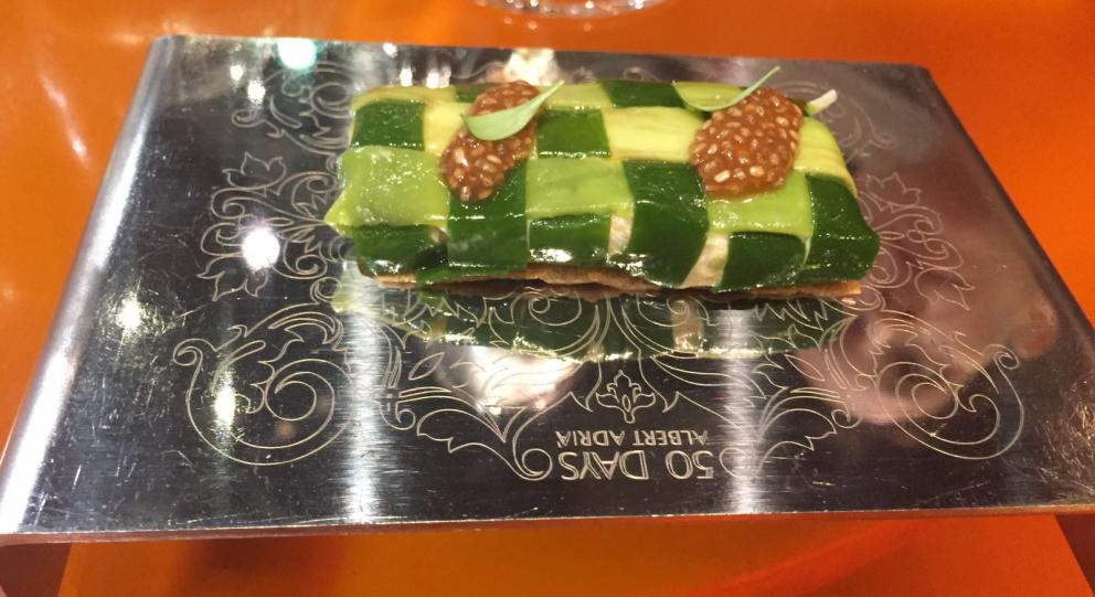 Galleria fotografica






Consommè de garbanzos. Prima che cominci il menu degustazione, viene portata al tavolo una bottiglia di vetro contenente del brodo freddo di ceci (in alto a destra). Ventitrè piatti dopo, alla fine del percorso "salato", verrà versato, in un bicchierino da grappa, del brodo caldo di jamon iberico da una teiera. Sopra ancora, la schiuma del brodo di ceci. Un caldo-freddo speciale (foto @ticketsbar instagram)









Tosta de pollo y anchoa. Primo piatto: toast di pelle di pollo con lisca di acciuga. A lato, una crema di acciughe composta da burro e pasta di acciughe









Olive Gordal. Uno dei simboli della saga Adrià: le olive sono immerse in un liquido d'olio extravergine d'oliva, cannella, buccia di limone e anice stellato. Si tirano su con un cucchiaino forato, si poggiano su una conchiglia di legno a lato e da qui in bocca. Gordal è una varietà dall'Andalusia









Prima preparazione rifinita al tavolo: Polo de almendras









Polo de almendras è uno stecco di gelato al latte di mandorle, spennellato sul posto con olio d'oliva e cosparso con granelle di mandorle, fiori di sambuco e sale. E' servito su un piatto con cubetti di ghiaccio. Dolce(salato) e gelato all'inizio del pasto e non alla fine, uno schema molto Adrià









Coliflor y caviar. Ganache di cavolfiore e caviale russo Schrenkii









Gamba a la sal fría. Gamberi marinati nel tè Lapsang Souchong con zest di bergamotto. Sono serviti su un vassoio con "neve di sale" per ricordare il ghiaccio tipico di un mercato del pesce









Atún con cerezas. Tonno e ciliegia: ventresca di tonno confit in grasso di prosciutto, accompagnata da una ciliegia affumicata (senza nocciolo)









Ceviche de melón cantaloup. Ceviche di melone cantalupo con succo di lime, coriandolo e leche de tigre di kumquat. Servito con kumquat, olio di coriandolo e neve di kumquat. Citrico alla terza









Pizza crujiente. La "pizza" di Tickets: millefoglie di regañà (torta di pane croccante di origini andaluse), stracciatella, bottarga e fichi









Porex de Calix. Marshmallow di dashi ripieno di crema acida e sormontato da caviale di Kalix, uova rosse svedesi di coregone, dalle note dolci ed eleganti









Nigiri de berenjena. Nigiri di melanzana









Cubo de wagyu. Cubo di chips di patata croccante con sopra una tartare di wagyu trattata con olio, sale, senape di Digione, uova e pepe. Una magnifica tapa da circa 2 cm per lato, che ricorda le battute al coltello della tradizione piemontese









Milhojas de atún. Millefoglie di tonno: millefoglie di patata e alga nori. In cima, tartare di tonno leggermente piccante con crema di avocado









Miniairbag de queso. Miniairbag di spuma di formaggio manchego, caviale di nocciola e polvere di buccia di nocciole









Airbaguette de rubia gallega: grissino-baguette vuoto avvolto da fettine di "prosciutto" marinato di rubia gallega, pregiata razza bovina galiziana






