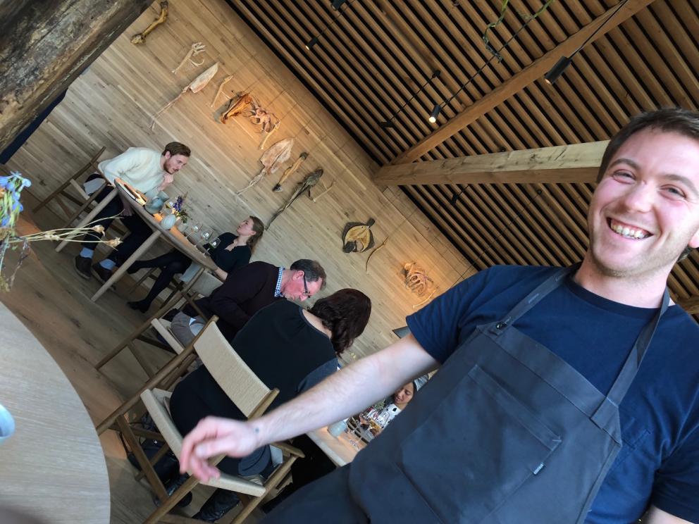 Photogallery






Noma 2.0 is in Christianshavn, the same neighbourhood as the first Noma. They’re 1.5 km apart, a 15 minutes’ walk. This picture shows the distance: to the right, there’s the warehouse of the old location (in Strandgade 93), to the left the smokestacks of Amager Bakke, the futuristic incinerator below which stands the new Noma (in Refshalevej 96)









Weather permitting, you can have a peaceful walk between the previous Noma to today’s Noma 









The new Noma is on an isthmus surrounded by canals. In the future they also want to reclaim some small parts for hydroponic farming









Bucolic scene with incinerator









Bikes left outside Noma. It’s the favourite means of transport among employees and interns









The long path taking you to the restaurant. The fence on the left shows how works are still in progress









On the two sides of the path there are the two new sections of the "Noma village", each with its specialty: grill, hot dishes, snacks, fermentations... In one month’s time, behind the fence we’ll have greenhouses, the test kitchen and the bread making area









To the left, before arriving at the restaurant, the future test kitchen. This will be run by Danish Mette Søberg with Riccardo Canella. "My first challenge?", reveals the latter, for a long time sous chef here, "is to work on the extraction of essential oils" 









The future Test Kitchen









The temporary gangway to the restaurant









Looking from the door to the restaurant, there’s a lake and the smokestacks puffing vapour from the Amager Bakke incinerator. It’s a futuristic project, both in terms of sustainability and architecture. It’s also known as Amager Slope or Copenhill, and its author is starchitect Bjarke Ingels, the same who designed the new Noma. Gradually opened in 2017, it transforms waste into electricity. The goal is to donate electricity to 62500 houses and hot water to 160000. It’s part of an ambitious project to transform Copenhagen into the first city in the world in terms of zero carbon dioxide emissions by 2025. By autumn this year, Amager Slope should open its ski slope, a climbing wall and a hiking track. You’ll be able to slalom on top of the incinerator









The windows from the dining room









Work is still in progress (photo taken on Thursday 22nd February 2018)









Traces of the old building, with barbwire. During WWII, they built bombs here









A view of the dining room at night (photo from Instagram/James Spreadbury)









The entrance to the restaurant









The usual ritual: a welcome from the entire staff, led by Rene Redzepi 









Behind the entrance, there are formaldehyde tanks with creatures from the abyss, shaped as in Damien Hirst’s works. The first image once you’re inside is to reproduce a Scandinavian village









The service kitchen is larger, more spacious and a completely open view from the dining room: "It’s the heart of our Scandinavian village", says Canella. There are 30 cooks working here now. 10 more, compared to the previous Noma









Large skylights above the cooks









There are currently more than 100 people working at Noma, of whom 63 are cooks - 26 employed, and 37 as interns









There’s fire in the kitchen, for the first time









On average, the dining room can host 40 people. "However", complains Redzepi, "there’s always someone who turns up with more people than the ones booked"









While the dining room is set, the outside space still need to be defined









The staff made the dining room decorations. There are no overly expensive designer objects









Dried fish









Seaweeds hanging from the ceiling









Dried octopus heads preserved in salt (with a balloon inside)














Bjarke Ingels and Redzepi’s plan included the wish to recreate a Danish farm









The luminous private dining room









The counter in the dining room. They drew the beams from the canals around the restaurant














The mise en place, bare and strictly without tablecloths









Water jug, candle, flower vase









A warm cloth, to begin with









Australian James Spreadbury, restaurant manager and partner at Noma









Welcome drink: Champagne extra brut Blanc d'Argile from Domaine Vouette et Sorbée









Sea Snail broth. The welcome dish at Noma is, as usual, a hot “soup”









Stefano Ferrano, from Torino, presents the following dish. There’s always a large Italian colony at Noma









Venus clams. Molluscs from Limfjord (Denmark) mixed with decorative clams, typical of Noma. Beside them, shells with blackcurrant oil and “Danish curry”, made with toasted coriander seeds, fennel and fennel seeds









The lid above the following dish. The mussels are not edible









Best of the mussel. Mussels open in a pan with water of fermented barley. «We recreate the mussel», says Canella, «using just the flaps, the best part». The paste is made with scraps from the mussel, cooked in smoked butter









The next dish is conceived and served by Riccardo Canella, the Paduan sous chef who conquered Redzepi, here with dining room intern Feline Hansen









Dried fruits and shrimps. In this case, the heads are not a decoration, but you must suck them –best not eat them because of the bones: they’re filled with a lovely prawn cream. The small crustaceans are still alive when they arrive on a ship straight from the Norwegian fjords









Inside, under the prawn broth skin, there’s fruits and vegetable preserved from the previous summer with raw prawns and gooseberry sauce with blackcurrant oil









How about beverages? There are three options, as usual: wine pairing (6 glasses plus a beer plus sake, 150 euros), juice pairing (juices and extracts, 110 euros) or a choice from the list. They recommend Champagne Chut... Libre from Val'Frison pour Dominique Derain, 50% Pinot Noir, 50% Chardonnay created by a couple who met at the old Noma. Well bodied, it will be a good match throughout the meal









As usual, the wine list starts with Champagne: the cheapest is 1400 crowns (190 euros)









White wines begin with labels from cold climates: first Austria, increasingly popular for its natural wines, then Germany, then all the others









How about Italy? Few names, among the white wines, from North and South









A dozen red/orange wines









Sea star, that is to say Cured trout roe and eggs, the emblem dish of this new era. They recommend moving the teaspoon from the heart to the edges of the tentacles. Aesthetics win over taste









Jellyfish. The jellyfish gel in the middle is in fact a clarified broth of calamari and recalls the texture of jellyfish. "We tried to cook jellyfish in 300 different ways but none was convincing so far". All around, pickled seaweed. The gel is almost tasteless, it serves to clean the palate after the pickles









Rene Redzepi himself presents the content of the first Seafood platter.









French style service with a small plate below for the empty shells









It’s made of two (per two) pieces: queen clam and mahogany clam









The Queen Clam is a very small variety of Norwegian scallop, seasoned with a vegetal reduction made with cucumber and peas miso. The red tip is the coral. "You should eat it using the top shell ", recommends Redzepi









The Mahogany clam is a centennial clam from the North Sea, very popular in Denmark and Iceland. «You can tell the age by the number of rings, like with trees», says Redzepi, «In 2007 they found one that was 450 years old. We’ve had it in the menu for a decade or so». The razor clam shell serves as teaspoon









Inside, there’s obviously not just a bare Mahogany. «We open it when the client arrives», says Canella, «remove the entrails and then slice it so as to preserve its firm texture». It’s seasoned with stir-fried gooseberry, capers of blackcurrants and blackcurrant sprouts preserved in vinegar. The sauce is made with mussel water









A note on the chairs: they’re more minimalistic. They’re no longer covered in sheepskin or leather from other Danish animals, in the style of Noma 1.0. The most significant element is the napkin: if you go to the toilet, they no longer replace it with a new one. There’s the old one, tied to the chair. "This is sustainability", they explain









The second seafood platter. It’s made of Sea cucumber and sour cream in various textures, including «chicharrones» (at 9 o’clock), sea urchins (at 12 and 3) and gigas oyster (at 6)









Sea urchins pressed in fresh cream and pumpkin seeds









Giga Oyster, a huge oyster from the Pacific, quickly steamed and garnished with pickles. Noma only reserved one thousand of these. In the menu until available









The following dish, off the menu, is again from Canella: horse mussel ragout, rare specimen of which 30 arrive at 'Noma each week









They cook the mussel as if it were kidney, in a sort of Bolognese sauce but with ginger. Ginger? "Yes, we’ve decided to include it, as with other spices, after our Mexican experience"






