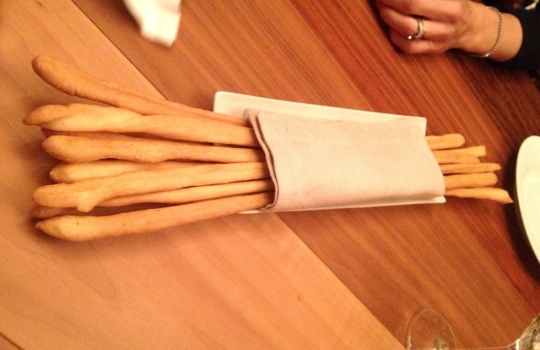 Photogallery






 
Modena’s colonnades, 186 thousand inhabitants and 3 restaurants with at least one Michelin star: Hostaria del Mare (1), Erba del Re (1) and Osteria Francescana (3 stars), our destination
 








Yellow and red tones prevail








The city still bears the signs of the May 2012 earthquake. On May 4th 2013, the day of our visit, a 3.8 magnitude earthquake was registered













By chance, Giuseppe Palmieri, maître and sommelier, appears from the grey door








Palmieri, 38, born in Matera. His first service in Francescana was on September 12th 2000








The old entrance to the restaurant, at number 24 in Via della Stella - as on the opening in 1995. It changed in September 2012: today you enter from number 22. Funnily enough, Google Maps is still set on the old entrance








The present entrance doors








Let’s start








After the latest renovations, the transit areas inside the Osteria appear as a contemporary art gallery








Mario Schifano’s world map








"Tourists", Maurizio Cattelan’s famous pigeons








Underneath the pigeons, Gavin Turk’s “Trashbag”








Three rooms, 12 tables, between 20 to 35 guests. 40% guests are Italian








Every table is illuminated by Davide Groppi’s Sampei lamp: if tables are moved, light follows








Francescana receives 150 reservations every day. But it also suffers from clients not showing up: on average, one table every week is booked but then guests don’t come








Right behind the kitchen, there’s the prêt-à-porter cellar








"In the central cellar, we only keep great vintages and larger bottles of what we consider to be great wines", Beppe Palmieri explains








1,600 wines are listed at Osteria Francescana, with a deep wine list which includes different vintages of the same wine








"A true celebration of wine "








The Ferrari coat, hanging in the cellar: Maranello is only 17 km away from Modena








Jean Todt, Michael Schumacher, Fernando Alonso: Ferrari’s “prancing horse” is at home in Via Stella








Gabrio Bini’s wines, from Pantelleria, a real fetish for Palmieri













Hanging from the ceiling, a nice selection of cured meats from Emilia








Bread made with mother yeast, the premise to a journey which will alternate great classics with very contemporary dishes








Massimo Bottura. Fifty years old last September, he is chef since 1986, the year of Trattoria del Campazzo in Nonantola. His first masters: Lidia Cristoni and Georges Cogny








He’s glowing: a few days ago his restaurant climbed, for the first time, onto the podium of the World's 50Best, a prize that is acquiring an increasing weight and authority. "The thing that makes me the happiest", he says, "is not so much the third place, but the fact that we’ve been in the highest positions for a few years now". True: 13th in 2009, 6th in 2010, 4th in 2011, 5th in 2012, 3rd in 2013








The now famous grey New Balance 993, a real emblem for the chef, friend of Jason Weis, president of the company in Massachusetts. The insole, however, is local: "In Emilia the sector is state-of-the-art", he says








"Are we ready?"








Almond granita with capers, bergamot and coffee cream 
Bottura and Palmieri’s journey across Italy starts from the bottom. And sails off from the Sicilian inland, with a classic granita which in Modena crumbles Adria-style, the wall that divides sweet from savoury, using the picklock of bitterness: Pantelleria capers, wild oregano but also bergamot, a coffee concentrate and vanilla scented salt. To pair with the first part of the meal, Sorriso di Cielo malvasia dei colli piacentini








Mediterranean Macaroon 
Next to the granita, two peculiar macaroons: the first is made with minced anchovies and sardines, the second with oysters and seaweeds. This is a classic scheme in Bottura’scuisine: his ironic turning the order of the dishes, from starter to dessert, upside down, and using popular raw materials instead of ingredients that are emblematic of élite cuisine. «While feet are sinking in the ground, the head is free to move everywhere», is one of his most famous quotes








Tempura of freshwater aulla with carpione ice-cream
Carpione ice-cream on a tempura of freshwater aulla – these fish are similar and slightly bigger than whitebait. The tempura is made by quickly placing the cold batter in boiling oil








Bread and croissants





