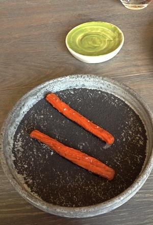 Galleria fotografica






In cammino verso il Noma. Il ristorante è al piano terra del palazzone più a sinistra. Per arrivarci dalla popolare insenatura di Nyhavn (il punto da cui è scattata la foto), occorre fare un bel giro. Ma si notano i lavori per la costruzione di un ponte. Che condurrà dritto all'insegna








Altra prospettiva sul Noma da Nyhavn. Il ristorante galleggia sulla Christianshavn, una delle tante isole artificiali che compongono Copenhagen








Di là del fiume, sulla lunga via che conduce allo spiazzo del Noma








Uno scenario molto tranquillo, di case pastello. Il silenzio è perché vanno tutti in bici













Al massimo si sente rombare qualche scafo








Il vascello davanti al Noma. Oltre a quella danese, sventolano le bandiere di Isole Far Oer e Groenlandia: le loro ambasciate sono nello stesso palazzo del ristorante. Coerenza nordica








Il retro del ristorante. L'80% delle 80 persone che lavorano al Noma viene a lavorare in bici, chef incluso








Dietro al ristorante, un'iscrizione ricorda i passeggeri scomparsi a bordo della danese Hans Hedtoft. Il transatlantico si scontrò il 30 gennaio 1959 contrò un iceberg in Groenlandia. Fu ritrovata solo una cintura di sicurezza
 








L'ingresso del ristorante, al civico 93 di Strandgade








La vista, ingresso alle spalle








Tra l'ingresso e la cucina a vista, spicca un corner di decoro simil-giapponese. A sinistra s'intravede Noma, time and place in Nordic Cuisine, edizioni Phaidon, un testo fondamentale per approfondire tutti i rivoli del Redzepi-mondo. La versione italiana si ordina qui








Una pianta di piccoli agrumi orla la cucina a vista








La porta d'ingresso vista dalla cucina








Le sedie, molto comode, sono anni Sessanta con schienali foderati di pelle di pecora, alcune più morbide di altre








I tavoli sono ampi e senza tovaglie. Attorno prevale il grigio e i colori rustici, sulle travi in legno del soffitto ma anche sulle divise dei ragazzi di sala








La finestra accanto al nostro tavolo








E' lo chef Rene Redzepi a introdurci al pasto: in un vaso di fiori danesi, l'unico pendaglio commestibile è una sorta di carta musica croccante (flatbread) di farina di malto all'aroma di ginepro. Nel piattino in basso, una deliziosa crème fraîche acida per intingerlo








Il flatbread è quello che svetta. "Ma se ci tenete, provate a mangiare anche i fiori", scherza Redzepi. Il cuoco scompare nelle segrete del Noma. Lo ritroveremo solo alla fine del pasto








Tutti i 14 appetizer si mangeranno con le mani. Unica posata, il coltello per tirar su e leccare la crème fraîche da sola (da fare quando tutti gli altri clienti son distratti, però)








Moss and Cep: Muschio di renna con polvere di funghi porcini. E' il corpo bianco, molto saporito ed evanescente, da intingere anch'esso nella crème fraîche
 








Crispy pork skin and black currant: Pelle di maiale croccante e ribes nero, lo strato più esterno. Aspro e croccante








Il ribes nero non ci lascerà prima di molto tempo








Blue mussels and celery: cozze e sedano. Solo due sono quelle buone








La parte inferiore del guscio è commestibile (ancora farina di malto)








Il quinto appetizer è nascosto in una deliziosa scatola di biscotti in latta della tradizione danese (chi non ricorda i Danish butter cookies?)








Cinque tondini, ma solo due "interessanti"








Si chiamano Cheese cookies, rocket and stems, letteralmente Biscotti al formaggio, ruchetta e gambi di erbe aromatiche, un felice snack potenzialmente riproducibile nei nord e nei sud del mondo








Appetizer #6: Potato and duck liver, Patate e fegato d'anatra: le patate croccanti sono in due strati e a mo' di sandwich racchiudono la mousse di fegato. La spolverata è di funghi trombette dei morti, disidratati e polverizzati, una tecnica che troveremo frequentemente





