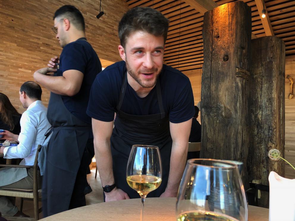 Photogallery






Noma 2.0 is in Christianshavn, the same neighbourhood as the first Noma. They’re 1.5 km apart, a 15 minutes’ walk. This picture shows the distance: to the right, there’s the warehouse of the old location (in Strandgade 93), to the left the smokestacks of Amager Bakke, the futuristic incinerator below which stands the new Noma (in Refshalevej 96)









Weather permitting, you can have a peaceful walk between the previous Noma to today’s Noma 









The new Noma is on an isthmus surrounded by canals. In the future they also want to reclaim some small parts for hydroponic farming









Bucolic scene with incinerator









Bikes left outside Noma. It’s the favourite means of transport among employees and interns









The long path taking you to the restaurant. The fence on the left shows how works are still in progress









On the two sides of the path there are the two new sections of the "Noma village", each with its specialty: grill, hot dishes, snacks, fermentations... In one month’s time, behind the fence we’ll have greenhouses, the test kitchen and the bread making area









To the left, before arriving at the restaurant, the future test kitchen. This will be run by Danish Mette Søberg with Riccardo Canella. "My first challenge?", reveals the latter, for a long time sous chef here, "is to work on the extraction of essential oils" 









The future Test Kitchen









The temporary gangway to the restaurant









Looking from the door to the restaurant, there’s a lake and the smokestacks puffing vapour from the Amager Bakke incinerator. It’s a futuristic project, both in terms of sustainability and architecture. It’s also known as Amager Slope or Copenhill, and its author is starchitect Bjarke Ingels, the same who designed the new Noma. Gradually opened in 2017, it transforms waste into electricity. The goal is to donate electricity to 62500 houses and hot water to 160000. It’s part of an ambitious project to transform Copenhagen into the first city in the world in terms of zero carbon dioxide emissions by 2025. By autumn this year, Amager Slope should open its ski slope, a climbing wall and a hiking track. You’ll be able to slalom on top of the incinerator









The windows from the dining room









Work is still in progress (photo taken on Thursday 22nd February 2018)









Traces of the old building, with barbwire. During WWII, they built bombs here









A view of the dining room at night (photo from Instagram/James Spreadbury)









The entrance to the restaurant









The usual ritual: a welcome from the entire staff, led by Rene Redzepi 









Behind the entrance, there are formaldehyde tanks with creatures from the abyss, shaped as in Damien Hirst’s works. The first image once you’re inside is to reproduce a Scandinavian village









The service kitchen is larger, more spacious and a completely open view from the dining room: "It’s the heart of our Scandinavian village", says Canella. There are 30 cooks working here now. 10 more, compared to the previous Noma









Large skylights above the cooks









There are currently more than 100 people working at Noma, of whom 63 are cooks - 26 employed, and 37 as interns









There’s fire in the kitchen, for the first time









On average, the dining room can host 40 people. "However", complains Redzepi, "there’s always someone who turns up with more people than the ones booked"









While the dining room is set, the outside space still need to be defined









The staff made the dining room decorations. There are no overly expensive designer objects









Dried fish









Seaweeds hanging from the ceiling









Dried octopus heads preserved in salt (with a balloon inside)














Bjarke Ingels and Redzepi’s plan included the wish to recreate a Danish farm









The luminous private dining room









The counter in the dining room. They drew the beams from the canals around the restaurant














The mise en place, bare and strictly without tablecloths









Water jug, candle, flower vase









A warm cloth, to begin with









Australian James Spreadbury, restaurant manager and partner at Noma









Welcome drink: Champagne extra brut Blanc d'Argile from Domaine Vouette et Sorbée









Sea Snail broth. The welcome dish at Noma is, as usual, a hot “soup”






