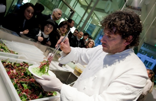 Galleria fotograficaCoda fuori dallo showroom Agape, via Statuto 12, per il piatto di Andrea BertonIl piatto di Berton:&nbsp;Focaccia di Recco con controfiletto di manzo crudo e composta di pomodoro piccanteAndrea BertonArclinea, corso Monforte 28: si preparano i fratelli&nbsp;Christian e Manuel Costardi, cuochi del ristorante Cinzia di VercelliL'imbuto di metallo per infilare il risotto nel barattolo warholiano. Alle spalle di Christian Costardi, Giulia Corradetti di Magenta BureauCostardi&rsquo;s tomato rice (omaggio a Andy Warhol)Manuel e ChristianLa gente godeCesar in via Larga 23, presidiato da&nbsp;Giovanni Ruggieri del ristorante RefettorioGiovanni Ruggieri con la sua&nbsp;Crema di patate con tarassaco all&rsquo;aceto di moscato, asparagi e salsa al crescioneGiovanni RuggieriTutti da Dada in via Larga, angolo piazza Santo Stefano, per&nbsp;Fabio Pisani e Alessandro Negrini di Aimo e NadiaFabio PisaniSpaghetti di Benedetto Cavalieri in cous cous con mozzarella di bufala campana, pomodori pugliesi &ldquo;al filo&rdquo; e profumo di limoni della CostieraLa granelle di cous cous &egrave; ricavata da spaghettoni frullati a crudoDa De Longhi, via Borgogna 8, c'&egrave; Alice Delcourt dell'Erba BruscaAlice DelcourtUltimo giro d'olio per il&nbsp;Cous cous speziato con erbe aromatiche, albicocche e zuccaMatteo Torretta ha cucinato allo Scavolini Store di piazza MissoriA destra Matteo Torretta, chef de Al V Piano di MilanoSotto al minipimer,&nbsp;Finto risotto di finocchi al sentore di sambucaLa spuma &egrave; di sambucaMatteo TorrettaDa Valcucine, corso Garibaldi 99, c'&egrave; il Ratan&agrave; di Milano