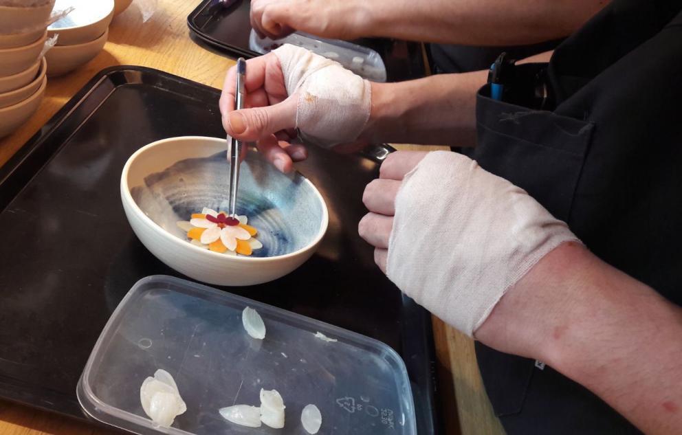 Photogallery






Noma 2.0 is in Christianshavn, the same neighbourhood as the first Noma. They’re 1.5 km apart, a 15 minutes’ walk. This picture shows the distance: to the right, there’s the warehouse of the old location (in Strandgade 93), to the left the smokestacks of Amager Bakke, the futuristic incinerator below which stands the new Noma (in Refshalevej 96)









Weather permitting, you can have a peaceful walk between the previous Noma to today’s Noma 









The new Noma is on an isthmus surrounded by canals. In the future they also want to reclaim some small parts for hydroponic farming









Bucolic scene with incinerator









Bikes left outside Noma. It’s the favourite means of transport among employees and interns









The long path taking you to the restaurant. The fence on the left shows how works are still in progress









On the two sides of the path there are the two new sections of the "Noma village", each with its specialty: grill, hot dishes, snacks, fermentations... In one month’s time, behind the fence we’ll have greenhouses, the test kitchen and the bread making area









To the left, before arriving at the restaurant, the future test kitchen. This will be run by Danish Mette Søberg with Riccardo Canella. "My first challenge?", reveals the latter, for a long time sous chef here, "is to work on the extraction of essential oils" 









The future Test Kitchen









The temporary gangway to the restaurant









Looking from the door to the restaurant, there’s a lake and the smokestacks puffing vapour from the Amager Bakke incinerator. It’s a futuristic project, both in terms of sustainability and architecture. It’s also known as Amager Slope or Copenhill, and its author is starchitect Bjarke Ingels, the same who designed the new Noma. Gradually opened in 2017, it transforms waste into electricity. The goal is to donate electricity to 62500 houses and hot water to 160000. It’s part of an ambitious project to transform Copenhagen into the first city in the world in terms of zero carbon dioxide emissions by 2025. By autumn this year, Amager Slope should open its ski slope, a climbing wall and a hiking track. You’ll be able to slalom on top of the incinerator









The windows from the dining room









Work is still in progress (photo taken on Thursday 22nd February 2018)









Traces of the old building, with barbwire. During WWII, they built bombs here









A view of the dining room at night (photo from Instagram/James Spreadbury)









The entrance to the restaurant









The usual ritual: a welcome from the entire staff, led by Rene Redzepi 









Behind the entrance, there are formaldehyde tanks with creatures from the abyss, shaped as in Damien Hirst’s works. The first image once you’re inside is to reproduce a Scandinavian village









The service kitchen is larger, more spacious and a completely open view from the dining room: "It’s the heart of our Scandinavian village", says Canella. There are 30 cooks working here now. 10 more, compared to the previous Noma









Large skylights above the cooks









There are currently more than 100 people working at Noma, of whom 63 are cooks - 26 employed, and 37 as interns









There’s fire in the kitchen, for the first time









On average, the dining room can host 40 people. "However", complains Redzepi, "there’s always someone who turns up with more people than the ones booked"









While the dining room is set, the outside space still need to be defined









The staff made the dining room decorations. There are no overly expensive designer objects









Dried fish









Seaweeds hanging from the ceiling









Dried octopus heads preserved in salt (with a balloon inside)














Bjarke Ingels and Redzepi’s plan included the wish to recreate a Danish farm









The luminous private dining room









The counter in the dining room. They drew the beams from the canals around the restaurant














The mise en place, bare and strictly without tablecloths









Water jug, candle, flower vase









A warm cloth, to begin with









Australian James Spreadbury, restaurant manager and partner at Noma









Welcome drink: Champagne extra brut Blanc d'Argile from Domaine Vouette et Sorbée









Sea Snail broth. The welcome dish at Noma is, as usual, a hot “soup”









Stefano Ferrano, from Torino, presents the following dish. There’s always a large Italian colony at Noma









Venus clams. Molluscs from Limfjord (Denmark) mixed with decorative clams, typical of Noma. Beside them, shells with blackcurrant oil and “Danish curry”, made with toasted coriander seeds, fennel and fennel seeds









The lid above the following dish. The mussels are not edible









Best of the mussel. Mussels open in a pan with water of fermented barley. «We recreate the mussel», says Canella, «using just the flaps, the best part». The paste is made with scraps from the mussel, cooked in smoked butter









The next dish is conceived and served by Riccardo Canella, the Paduan sous chef who conquered Redzepi, here with dining room intern Feline Hansen









Dried fruits and shrimps. In this case, the heads are not a decoration, but you must suck them –best not eat them because of the bones: they’re filled with a lovely prawn cream. The small crustaceans are still alive when they arrive on a ship straight from the Norwegian fjords









Inside, under the prawn broth skin, there’s fruits and vegetable preserved from the previous summer with raw prawns and gooseberry sauce with blackcurrant oil









How about beverages? There are three options, as usual: wine pairing (6 glasses plus a beer plus sake, 150 euros), juice pairing (juices and extracts, 110 euros) or a choice from the list. They recommend Champagne Chut... Libre from Val'Frison pour Dominique Derain, 50% Pinot Noir, 50% Chardonnay created by a couple who met at the old Noma. Well bodied, it will be a good match throughout the meal









As usual, the wine list starts with Champagne: the cheapest is 1400 crowns (190 euros)









White wines begin with labels from cold climates: first Austria, increasingly popular for its natural wines, then Germany, then all the others









How about Italy? Few names, among the white wines, from North and South









A dozen red/orange wines









Sea star, that is to say Cured trout roe and eggs, the emblem dish of this new era. They recommend moving the teaspoon from the heart to the edges of the tentacles. Aesthetics win over taste









Jellyfish. The jellyfish gel in the middle is in fact a clarified broth of calamari and recalls the texture of jellyfish. "We tried to cook jellyfish in 300 different ways but none was convincing so far". All around, pickled seaweed. The gel is almost tasteless, it serves to clean the palate after the pickles









Rene Redzepi himself presents the content of the first Seafood platter.









French style service with a small plate below for the empty shells









It’s made of two (per two) pieces: queen clam and mahogany clam









The Queen Clam is a very small variety of Norwegian scallop, seasoned with a vegetal reduction made with cucumber and peas miso. The red tip is the coral. "You should eat it using the top shell ", recommends Redzepi









The Mahogany clam is a centennial clam from the North Sea, very popular in Denmark and Iceland. «You can tell the age by the number of rings, like with trees», says Redzepi, «In 2007 they found one that was 450 years old. We’ve had it in the menu for a decade or so». The razor clam shell serves as teaspoon









Inside, there’s obviously not just a bare Mahogany. «We open it when the client arrives», says Canella, «remove the entrails and then slice it so as to preserve its firm texture». It’s seasoned with stir-fried gooseberry, capers of blackcurrants and blackcurrant sprouts preserved in vinegar. The sauce is made with mussel water









A note on the chairs: they’re more minimalistic. They’re no longer covered in sheepskin or leather from other Danish animals, in the style of Noma 1.0. The most significant element is the napkin: if you go to the toilet, they no longer replace it with a new one. There’s the old one, tied to the chair. "This is sustainability", they explain









The second seafood platter. It’s made of Sea cucumber and sour cream in various textures, including «chicharrones» (at 9 o’clock), sea urchins (at 12 and 3) and gigas oyster (at 6)









Sea urchins pressed in fresh cream and pumpkin seeds









Giga Oyster, a huge oyster from the Pacific, quickly steamed and garnished with pickles. Noma only reserved one thousand of these. In the menu until available









The following dish, off the menu, is again from Canella: horse mussel ragout, rare specimen of which 30 arrive at 'Noma each week









They cook the mussel as if it were kidney, in a sort of Bolognese sauce but with ginger. Ginger? "Yes, we’ve decided to include it, as with other spices, after our Mexican experience"









Another Italian presents a dish, Edoardo Fiaschi from Prato, at Noma for 3 years now









Squid in seaweed butter. An almost neglected Danish squid lightly seared in fermented koji oil, rolled and seasoned with seaweed butter and served on sticks of blackcurrant that widen its aromas. Formidable and beautiful









The following dish is inside a nice bee wax container. It’s made with balloons covered multiple times in bee wax. «We spent weeks making them. We’ve made thousands». They’re disposable...









Sea snail and roses. They recommend to: "Eat it keeping the bee wax on your hands "









Sea snail. Another small nibble from the top part of the sea snail, lightly warmed up in water and served on a reduction of lemon thyme









A sea snail toothpick, initially carved by Redzepi himself









Head of the cod, (right), the real main course at Noma









Another rather laborious recipe. «It takes half an hour just to separate the head. We remove the skin, the collagen, we cut mandibles, tongue, cheek and the part behind. We rinse it in water, spices, koji and cook it in the yakitori with a glaze of mushrooms and spiced fennel broth»









You can garnish the cod as you choose, with a paste of ants (top right corner), a slightly spicy emulsion of koji oil, water and horseradish sauce (left) and Danish curry (bottom)









On the side of the cod, there’s also wild garlic seasoned with smoked butter and roasted yeast. Intense flavour









Cod bones after the tasting









An interlocutory snack made of cod cheek









Pickled vegetables and arctic herbs. The only vegetable dish in the menu, marks the passage from savoury to sweet dishes. Between June and August 2018 the menu at Noma will be 100% vegetarian






