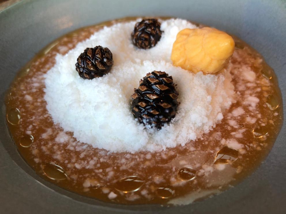 Photogallery






Noma 2.0 is in Christianshavn, the same neighbourhood as the first Noma. They’re 1.5 km apart, a 15 minutes’ walk. This picture shows the distance: to the right, there’s the warehouse of the old location (in Strandgade 93), to the left the smokestacks of Amager Bakke, the futuristic incinerator below which stands the new Noma (in Refshalevej 96)









Weather permitting, you can have a peaceful walk between the previous Noma to today’s Noma 









The new Noma is on an isthmus surrounded by canals. In the future they also want to reclaim some small parts for hydroponic farming









Bucolic scene with incinerator









Bikes left outside Noma. It’s the favourite means of transport among employees and interns









The long path taking you to the restaurant. The fence on the left shows how works are still in progress









On the two sides of the path there are the two new sections of the "Noma village", each with its specialty: grill, hot dishes, snacks, fermentations... In one month’s time, behind the fence we’ll have greenhouses, the test kitchen and the bread making area









To the left, before arriving at the restaurant, the future test kitchen. This will be run by Danish Mette Søberg with Riccardo Canella. "My first challenge?", reveals the latter, for a long time sous chef here, "is to work on the extraction of essential oils" 









The future Test Kitchen









The temporary gangway to the restaurant









Looking from the door to the restaurant, there’s a lake and the smokestacks puffing vapour from the Amager Bakke incinerator. It’s a futuristic project, both in terms of sustainability and architecture. It’s also known as Amager Slope or Copenhill, and its author is starchitect Bjarke Ingels, the same who designed the new Noma. Gradually opened in 2017, it transforms waste into electricity. The goal is to donate electricity to 62500 houses and hot water to 160000. It’s part of an ambitious project to transform Copenhagen into the first city in the world in terms of zero carbon dioxide emissions by 2025. By autumn this year, Amager Slope should open its ski slope, a climbing wall and a hiking track. You’ll be able to slalom on top of the incinerator









The windows from the dining room









Work is still in progress (photo taken on Thursday 22nd February 2018)









Traces of the old building, with barbwire. During WWII, they built bombs here









A view of the dining room at night (photo from Instagram/James Spreadbury)









The entrance to the restaurant









The usual ritual: a welcome from the entire staff, led by Rene Redzepi 









Behind the entrance, there are formaldehyde tanks with creatures from the abyss, shaped as in Damien Hirst’s works. The first image once you’re inside is to reproduce a Scandinavian village









The service kitchen is larger, more spacious and a completely open view from the dining room: "It’s the heart of our Scandinavian village", says Canella. There are 30 cooks working here now. 10 more, compared to the previous Noma









Large skylights above the cooks









There are currently more than 100 people working at Noma, of whom 63 are cooks - 26 employed, and 37 as interns









There’s fire in the kitchen, for the first time









On average, the dining room can host 40 people. "However", complains Redzepi, "there’s always someone who turns up with more people than the ones booked"









While the dining room is set, the outside space still need to be defined









The staff made the dining room decorations. There are no overly expensive designer objects









Dried fish









Seaweeds hanging from the ceiling









Dried octopus heads preserved in salt (with a balloon inside)














Bjarke Ingels and Redzepi’s plan included the wish to recreate a Danish farm









The luminous private dining room









The counter in the dining room. They drew the beams from the canals around the restaurant














The mise en place, bare and strictly without tablecloths









Water jug, candle, flower vase









A warm cloth, to begin with









Australian James Spreadbury, restaurant manager and partner at Noma









Welcome drink: Champagne extra brut Blanc d'Argile from Domaine Vouette et Sorbée









Sea Snail broth. The welcome dish at Noma is, as usual, a hot “soup”









Stefano Ferrano, from Torino, presents the following dish. There’s always a large Italian colony at Noma









Venus clams. Molluscs from Limfjord (Denmark) mixed with decorative clams, typical of Noma. Beside them, shells with blackcurrant oil and “Danish curry”, made with toasted coriander seeds, fennel and fennel seeds









The lid above the following dish. The mussels are not edible









Best of the mussel. Mussels open in a pan with water of fermented barley. «We recreate the mussel», says Canella, «using just the flaps, the best part». The paste is made with scraps from the mussel, cooked in smoked butter









The next dish is conceived and served by Riccardo Canella, the Paduan sous chef who conquered Redzepi, here with dining room intern Feline Hansen









Dried fruits and shrimps. In this case, the heads are not a decoration, but you must suck them –best not eat them because of the bones: they’re filled with a lovely prawn cream. The small crustaceans are still alive when they arrive on a ship straight from the Norwegian fjords









Inside, under the prawn broth skin, there’s fruits and vegetable preserved from the previous summer with raw prawns and gooseberry sauce with blackcurrant oil









How about beverages? There are three options, as usual: wine pairing (6 glasses plus a beer plus sake, 150 euros), juice pairing (juices and extracts, 110 euros) or a choice from the list. They recommend Champagne Chut... Libre from Val'Frison pour Dominique Derain, 50% Pinot Noir, 50% Chardonnay created by a couple who met at the old Noma. Well bodied, it will be a good match throughout the meal









As usual, the wine list starts with Champagne: the cheapest is 1400 crowns (190 euros)









White wines begin with labels from cold climates: first Austria, increasingly popular for its natural wines, then Germany, then all the others









How about Italy? Few names, among the white wines, from North and South









A dozen red/orange wines









Sea star, that is to say Cured trout roe and eggs, the emblem dish of this new era. They recommend moving the teaspoon from the heart to the edges of the tentacles. Aesthetics win over taste









Jellyfish. The jellyfish gel in the middle is in fact a clarified broth of calamari and recalls the texture of jellyfish. "We tried to cook jellyfish in 300 different ways but none was convincing so far". All around, pickled seaweed. The gel is almost tasteless, it serves to clean the palate after the pickles









Rene Redzepi himself presents the content of the first Seafood platter.









French style service with a small plate below for the empty shells









It’s made of two (per two) pieces: queen clam and mahogany clam









The Queen Clam is a very small variety of Norwegian scallop, seasoned with a vegetal reduction made with cucumber and peas miso. The red tip is the coral. "You should eat it using the top shell ", recommends Redzepi









The Mahogany clam is a centennial clam from the North Sea, very popular in Denmark and Iceland. «You can tell the age by the number of rings, like with trees», says Redzepi, «In 2007 they found one that was 450 years old. We’ve had it in the menu for a decade or so». The razor clam shell serves as teaspoon









Inside, there’s obviously not just a bare Mahogany. «We open it when the client arrives», says Canella, «remove the entrails and then slice it so as to preserve its firm texture». It’s seasoned with stir-fried gooseberry, capers of blackcurrants and blackcurrant sprouts preserved in vinegar. The sauce is made with mussel water









A note on the chairs: they’re more minimalistic. They’re no longer covered in sheepskin or leather from other Danish animals, in the style of Noma 1.0. The most significant element is the napkin: if you go to the toilet, they no longer replace it with a new one. There’s the old one, tied to the chair. "This is sustainability", they explain









The second seafood platter. It’s made of Sea cucumber and sour cream in various textures, including «chicharrones» (at 9 o’clock), sea urchins (at 12 and 3) and gigas oyster (at 6)









Sea urchins pressed in fresh cream and pumpkin seeds









Giga Oyster, a huge oyster from the Pacific, quickly steamed and garnished with pickles. Noma only reserved one thousand of these. In the menu until available









The following dish, off the menu, is again from Canella: horse mussel ragout, rare specimen of which 30 arrive at 'Noma each week









They cook the mussel as if it were kidney, in a sort of Bolognese sauce but with ginger. Ginger? "Yes, we’ve decided to include it, as with other spices, after our Mexican experience"









Another Italian presents a dish, Edoardo Fiaschi from Prato, at Noma for 3 years now









Squid in seaweed butter. An almost neglected Danish squid lightly seared in fermented koji oil, rolled and seasoned with seaweed butter and served on sticks of blackcurrant that widen its aromas. Formidable and beautiful









The following dish is inside a nice bee wax container. It’s made with balloons covered multiple times in bee wax. «We spent weeks making them. We’ve made thousands». They’re disposable...









Sea snail and roses. They recommend to: "Eat it keeping the bee wax on your hands "









Sea snail. Another small nibble from the top part of the sea snail, lightly warmed up in water and served on a reduction of lemon thyme









A sea snail toothpick, initially carved by Redzepi himself









Head of the cod, (right), the real main course at Noma









Another rather laborious recipe. «It takes half an hour just to separate the head. We remove the skin, the collagen, we cut mandibles, tongue, cheek and the part behind. We rinse it in water, spices, koji and cook it in the yakitori with a glaze of mushrooms and spiced fennel broth»









You can garnish the cod as you choose, with a paste of ants (top right corner), a slightly spicy emulsion of koji oil, water and horseradish sauce (left) and Danish curry (bottom)









On the side of the cod, there’s also wild garlic seasoned with smoked butter and roasted yeast. Intense flavour









Cod bones after the tasting









An interlocutory snack made of cod cheek









Pickled vegetables and arctic herbs. The only vegetable dish in the menu, marks the passage from savoury to sweet dishes. Between June and August 2018 the menu at Noma will be 100% vegetarian









Preparation time: half an hour! A challenge for the person making it









Mussels appear once again, a classic emblem









This time it’s a dessert in the shape of a small sandwich. Pear and roasted kelp ice cream 






