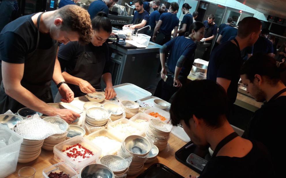 Photogallery






Noma 2.0 is in Christianshavn, the same neighbourhood as the first Noma. They’re 1.5 km apart, a 15 minutes’ walk. This picture shows the distance: to the right, there’s the warehouse of the old location (in Strandgade 93), to the left the smokestacks of Amager Bakke, the futuristic incinerator below which stands the new Noma (in Refshalevej 96)









Weather permitting, you can have a peaceful walk between the previous Noma to today’s Noma 









The new Noma is on an isthmus surrounded by canals. In the future they also want to reclaim some small parts for hydroponic farming









Bucolic scene with incinerator









Bikes left outside Noma. It’s the favourite means of transport among employees and interns









The long path taking you to the restaurant. The fence on the left shows how works are still in progress









On the two sides of the path there are the two new sections of the "Noma village", each with its specialty: grill, hot dishes, snacks, fermentations... In one month’s time, behind the fence we’ll have greenhouses, the test kitchen and the bread making area









To the left, before arriving at the restaurant, the future test kitchen. This will be run by Danish Mette Søberg with Riccardo Canella. "My first challenge?", reveals the latter, for a long time sous chef here, "is to work on the extraction of essential oils" 









The future Test Kitchen









The temporary gangway to the restaurant









Looking from the door to the restaurant, there’s a lake and the smokestacks puffing vapour from the Amager Bakke incinerator. It’s a futuristic project, both in terms of sustainability and architecture. It’s also known as Amager Slope or Copenhill, and its author is starchitect Bjarke Ingels, the same who designed the new Noma. Gradually opened in 2017, it transforms waste into electricity. The goal is to donate electricity to 62500 houses and hot water to 160000. It’s part of an ambitious project to transform Copenhagen into the first city in the world in terms of zero carbon dioxide emissions by 2025. By autumn this year, Amager Slope should open its ski slope, a climbing wall and a hiking track. You’ll be able to slalom on top of the incinerator









The windows from the dining room









Work is still in progress (photo taken on Thursday 22nd February 2018)









Traces of the old building, with barbwire. During WWII, they built bombs here









A view of the dining room at night (photo from Instagram/James Spreadbury)









The entrance to the restaurant









The usual ritual: a welcome from the entire staff, led by Rene Redzepi 









Behind the entrance, there are formaldehyde tanks with creatures from the abyss, shaped as in Damien Hirst’s works. The first image once you’re inside is to reproduce a Scandinavian village









The service kitchen is larger, more spacious and a completely open view from the dining room: "It’s the heart of our Scandinavian village", says Canella. There are 30 cooks working here now. 10 more, compared to the previous Noma









Large skylights above the cooks






