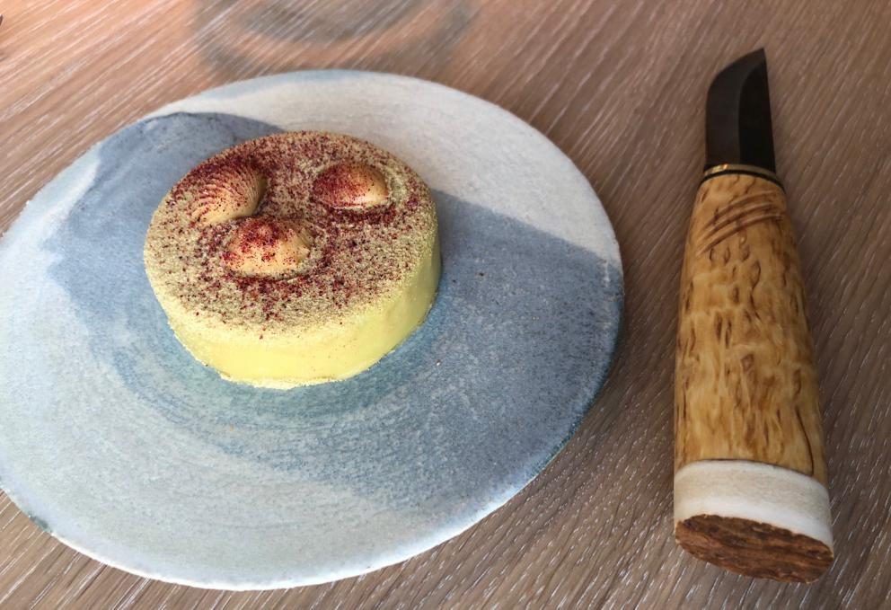 Photogallery






Noma 2.0 is in Christianshavn, the same neighbourhood as the first Noma. They’re 1.5 km apart, a 15 minutes’ walk. This picture shows the distance: to the right, there’s the warehouse of the old location (in Strandgade 93), to the left the smokestacks of Amager Bakke, the futuristic incinerator below which stands the new Noma (in Refshalevej 96)









Weather permitting, you can have a peaceful walk between the previous Noma to today’s Noma 









The new Noma is on an isthmus surrounded by canals. In the future they also want to reclaim some small parts for hydroponic farming









Bucolic scene with incinerator









Bikes left outside Noma. It’s the favourite means of transport among employees and interns









The long path taking you to the restaurant. The fence on the left shows how works are still in progress









On the two sides of the path there are the two new sections of the "Noma village", each with its specialty: grill, hot dishes, snacks, fermentations... In one month’s time, behind the fence we’ll have greenhouses, the test kitchen and the bread making area









To the left, before arriving at the restaurant, the future test kitchen. This will be run by Danish Mette Søberg with Riccardo Canella. "My first challenge?", reveals the latter, for a long time sous chef here, "is to work on the extraction of essential oils" 









The future Test Kitchen









The temporary gangway to the restaurant









Looking from the door to the restaurant, there’s a lake and the smokestacks puffing vapour from the Amager Bakke incinerator. It’s a futuristic project, both in terms of sustainability and architecture. It’s also known as Amager Slope or Copenhill, and its author is starchitect Bjarke Ingels, the same who designed the new Noma. Gradually opened in 2017, it transforms waste into electricity. The goal is to donate electricity to 62500 houses and hot water to 160000. It’s part of an ambitious project to transform Copenhagen into the first city in the world in terms of zero carbon dioxide emissions by 2025. By autumn this year, Amager Slope should open its ski slope, a climbing wall and a hiking track. You’ll be able to slalom on top of the incinerator









The windows from the dining room









Work is still in progress (photo taken on Thursday 22nd February 2018)









Traces of the old building, with barbwire. During WWII, they built bombs here









A view of the dining room at night (photo from Instagram/James Spreadbury)









The entrance to the restaurant









The usual ritual: a welcome from the entire staff, led by Rene Redzepi 









Behind the entrance, there are formaldehyde tanks with creatures from the abyss, shaped as in Damien Hirst’s works. The first image once you’re inside is to reproduce a Scandinavian village









The service kitchen is larger, more spacious and a completely open view from the dining room: "It’s the heart of our Scandinavian village", says Canella. There are 30 cooks working here now. 10 more, compared to the previous Noma









Large skylights above the cooks









There are currently more than 100 people working at Noma, of whom 63 are cooks - 26 employed, and 37 as interns









There’s fire in the kitchen, for the first time









On average, the dining room can host 40 people. "However", complains Redzepi, "there’s always someone who turns up with more people than the ones booked"









While the dining room is set, the outside space still need to be defined









The staff made the dining room decorations. There are no overly expensive designer objects









Dried fish









Seaweeds hanging from the ceiling









Dried octopus heads preserved in salt (with a balloon inside)














Bjarke Ingels and Redzepi’s plan included the wish to recreate a Danish farm









The luminous private dining room









The counter in the dining room. They drew the beams from the canals around the restaurant














The mise en place, bare and strictly without tablecloths









Water jug, candle, flower vase









A warm cloth, to begin with









Australian James Spreadbury, restaurant manager and partner at Noma









Welcome drink: Champagne extra brut Blanc d'Argile from Domaine Vouette et Sorbée









Sea Snail broth. The welcome dish at Noma is, as usual, a hot “soup”









Stefano Ferrano, from Torino, presents the following dish. There’s always a large Italian colony at Noma









Venus clams. Molluscs from Limfjord (Denmark) mixed with decorative clams, typical of Noma. Beside them, shells with blackcurrant oil and “Danish curry”, made with toasted coriander seeds, fennel and fennel seeds









The lid above the following dish. The mussels are not edible









Best of the mussel. Mussels open in a pan with water of fermented barley. «We recreate the mussel», says Canella, «using just the flaps, the best part». The paste is made with scraps from the mussel, cooked in smoked butter









The next dish is conceived and served by Riccardo Canella, the Paduan sous chef who conquered Redzepi, here with dining room intern Feline Hansen









Dried fruits and shrimps. In this case, the heads are not a decoration, but you must suck them –best not eat them because of the bones: they’re filled with a lovely prawn cream. The small crustaceans are still alive when they arrive on a ship straight from the Norwegian fjords









Inside, under the prawn broth skin, there’s fruits and vegetable preserved from the previous summer with raw prawns and gooseberry sauce with blackcurrant oil









How about beverages? There are three options, as usual: wine pairing (6 glasses plus a beer plus sake, 150 euros), juice pairing (juices and extracts, 110 euros) or a choice from the list. They recommend Champagne Chut... Libre from Val'Frison pour Dominique Derain, 50% Pinot Noir, 50% Chardonnay created by a couple who met at the old Noma. Well bodied, it will be a good match throughout the meal









As usual, the wine list starts with Champagne: the cheapest is 1400 crowns (190 euros)









White wines begin with labels from cold climates: first Austria, increasingly popular for its natural wines, then Germany, then all the others









How about Italy? Few names, among the white wines, from North and South









A dozen red/orange wines









Sea star, that is to say Cured trout roe and eggs, the emblem dish of this new era. They recommend moving the teaspoon from the heart to the edges of the tentacles. Aesthetics win over taste









Jellyfish. The jellyfish gel in the middle is in fact a clarified broth of calamari and recalls the texture of jellyfish. "We tried to cook jellyfish in 300 different ways but none was convincing so far". All around, pickled seaweed. The gel is almost tasteless, it serves to clean the palate after the pickles









Rene Redzepi himself presents the content of the first Seafood platter.









French style service with a small plate below for the empty shells









It’s made of two (per two) pieces: queen clam and mahogany clam









The Queen Clam is a very small variety of Norwegian scallop, seasoned with a vegetal reduction made with cucumber and peas miso. The red tip is the coral. "You should eat it using the top shell ", recommends Redzepi









The Mahogany clam is a centennial clam from the North Sea, very popular in Denmark and Iceland. «You can tell the age by the number of rings, like with trees», says Redzepi, «In 2007 they found one that was 450 years old. We’ve had it in the menu for a decade or so». The razor clam shell serves as teaspoon









Inside, there’s obviously not just a bare Mahogany. «We open it when the client arrives», says Canella, «remove the entrails and then slice it so as to preserve its firm texture». It’s seasoned with stir-fried gooseberry, capers of blackcurrants and blackcurrant sprouts preserved in vinegar. The sauce is made with mussel water









A note on the chairs: they’re more minimalistic. They’re no longer covered in sheepskin or leather from other Danish animals, in the style of Noma 1.0. The most significant element is the napkin: if you go to the toilet, they no longer replace it with a new one. There’s the old one, tied to the chair. "This is sustainability", they explain









The second seafood platter. It’s made of Sea cucumber and sour cream in various textures, including «chicharrones» (at 9 o’clock), sea urchins (at 12 and 3) and gigas oyster (at 6)









Sea urchins pressed in fresh cream and pumpkin seeds









Giga Oyster, a huge oyster from the Pacific, quickly steamed and garnished with pickles. Noma only reserved one thousand of these. In the menu until available









The following dish, off the menu, is again from Canella: horse mussel ragout, rare specimen of which 30 arrive at 'Noma each week









They cook the mussel as if it were kidney, in a sort of Bolognese sauce but with ginger. Ginger? "Yes, we’ve decided to include it, as with other spices, after our Mexican experience"









Another Italian presents a dish, Edoardo Fiaschi from Prato, at Noma for 3 years now









Squid in seaweed butter. An almost neglected Danish squid lightly seared in fermented koji oil, rolled and seasoned with seaweed butter and served on sticks of blackcurrant that widen its aromas. Formidable and beautiful









The following dish is inside a nice bee wax container. It’s made with balloons covered multiple times in bee wax. «We spent weeks making them. We’ve made thousands». They’re disposable...









Sea snail and roses. They recommend to: "Eat it keeping the bee wax on your hands "









Sea snail. Another small nibble from the top part of the sea snail, lightly warmed up in water and served on a reduction of lemon thyme









A sea snail toothpick, initially carved by Redzepi himself









Head of the cod, (right), the real main course at Noma









Another rather laborious recipe. «It takes half an hour just to separate the head. We remove the skin, the collagen, we cut mandibles, tongue, cheek and the part behind. We rinse it in water, spices, koji and cook it in the yakitori with a glaze of mushrooms and spiced fennel broth»









You can garnish the cod as you choose, with a paste of ants (top right corner), a slightly spicy emulsion of koji oil, water and horseradish sauce (left) and Danish curry (bottom)









On the side of the cod, there’s also wild garlic seasoned with smoked butter and roasted yeast. Intense flavour









Cod bones after the tasting









An interlocutory snack made of cod cheek









Pickled vegetables and arctic herbs. The only vegetable dish in the menu, marks the passage from savoury to sweet dishes. Between June and August 2018 the menu at Noma will be 100% vegetarian









Preparation time: half an hour! A challenge for the person making it









Mussels appear once again, a classic emblem









This time it’s a dessert in the shape of a small sandwich. Pear and roasted kelp ice cream 









Cloudberries and pinecones. A dessert that continues Redzepi’s saga of unsweet sweets: cloudberries, pinecones preserved in sugar, yogurt snow (by Italian Jessica Natali) and a sea snail made with cloudberry sorbet









Filtered coffee made with stolen kenyoti seeds farmed in Honduras by a Norwegian guy. Italian sommelier Francesca Niro tells us this story. «In Denmark», she says, «coffee is not a final act»









Sugar kelp tart. Tartelletta di alga kelp con pralinato di pino (sul modello di quello di mandorle, autore Canella), panna e crisp di ostrica









Sugar kelp tart. Jessica Natali, 23, from the March, has been at Noma for 4 years now






