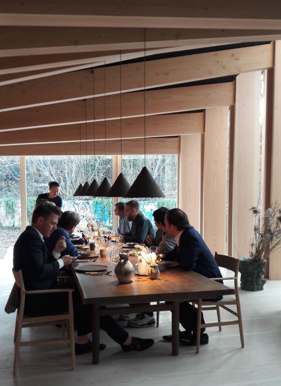 Photogallery






Noma 2.0 is in Christianshavn, the same neighbourhood as the first Noma. They’re 1.5 km apart, a 15 minutes’ walk. This picture shows the distance: to the right, there’s the warehouse of the old location (in Strandgade 93), to the left the smokestacks of Amager Bakke, the futuristic incinerator below which stands the new Noma (in Refshalevej 96)









Weather permitting, you can have a peaceful walk between the previous Noma to today’s Noma 









The new Noma is on an isthmus surrounded by canals. In the future they also want to reclaim some small parts for hydroponic farming









Bucolic scene with incinerator









Bikes left outside Noma. It’s the favourite means of transport among employees and interns









The long path taking you to the restaurant. The fence on the left shows how works are still in progress









On the two sides of the path there are the two new sections of the "Noma village", each with its specialty: grill, hot dishes, snacks, fermentations... In one month’s time, behind the fence we’ll have greenhouses, the test kitchen and the bread making area









To the left, before arriving at the restaurant, the future test kitchen. This will be run by Danish Mette Søberg with Riccardo Canella. "My first challenge?", reveals the latter, for a long time sous chef here, "is to work on the extraction of essential oils" 









The future Test Kitchen









The temporary gangway to the restaurant









Looking from the door to the restaurant, there’s a lake and the smokestacks puffing vapour from the Amager Bakke incinerator. It’s a futuristic project, both in terms of sustainability and architecture. It’s also known as Amager Slope or Copenhill, and its author is starchitect Bjarke Ingels, the same who designed the new Noma. Gradually opened in 2017, it transforms waste into electricity. The goal is to donate electricity to 62500 houses and hot water to 160000. It’s part of an ambitious project to transform Copenhagen into the first city in the world in terms of zero carbon dioxide emissions by 2025. By autumn this year, Amager Slope should open its ski slope, a climbing wall and a hiking track. You’ll be able to slalom on top of the incinerator









The windows from the dining room









Work is still in progress (photo taken on Thursday 22nd February 2018)









Traces of the old building, with barbwire. During WWII, they built bombs here









A view of the dining room at night (photo from Instagram/James Spreadbury)









The entrance to the restaurant









The usual ritual: a welcome from the entire staff, led by Rene Redzepi 









Behind the entrance, there are formaldehyde tanks with creatures from the abyss, shaped as in Damien Hirst’s works. The first image once you’re inside is to reproduce a Scandinavian village









The service kitchen is larger, more spacious and a completely open view from the dining room: "It’s the heart of our Scandinavian village", says Canella. There are 30 cooks working here now. 10 more, compared to the previous Noma









Large skylights above the cooks









There are currently more than 100 people working at Noma, of whom 63 are cooks - 26 employed, and 37 as interns









There’s fire in the kitchen, for the first time









On average, the dining room can host 40 people. "However", complains Redzepi, "there’s always someone who turns up with more people than the ones booked"









While the dining room is set, the outside space still need to be defined









The staff made the dining room decorations. There are no overly expensive designer objects









Dried fish









Seaweeds hanging from the ceiling









Dried octopus heads preserved in salt (with a balloon inside)














Bjarke Ingels and Redzepi’s plan included the wish to recreate a Danish farm






