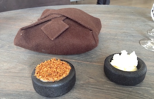 Galleria fotografica






In cammino verso il Noma. Il ristorante è al piano terra del palazzone più a sinistra. Per arrivarci dalla popolare insenatura di Nyhavn (il punto da cui è scattata la foto), occorre fare un bel giro. Ma si notano i lavori per la costruzione di un ponte. Che condurrà dritto all'insegna








Altra prospettiva sul Noma da Nyhavn. Il ristorante galleggia sulla Christianshavn, una delle tante isole artificiali che compongono Copenhagen








Di là del fiume, sulla lunga via che conduce allo spiazzo del Noma








Uno scenario molto tranquillo, di case pastello. Il silenzio è perché vanno tutti in bici













Al massimo si sente rombare qualche scafo








Il vascello davanti al Noma. Oltre a quella danese, sventolano le bandiere di Isole Far Oer e Groenlandia: le loro ambasciate sono nello stesso palazzo del ristorante. Coerenza nordica








Il retro del ristorante. L'80% delle 80 persone che lavorano al Noma viene a lavorare in bici, chef incluso








Dietro al ristorante, un'iscrizione ricorda i passeggeri scomparsi a bordo della danese Hans Hedtoft. Il transatlantico si scontrò il 30 gennaio 1959 contrò un iceberg in Groenlandia. Fu ritrovata solo una cintura di sicurezza
 








L'ingresso del ristorante, al civico 93 di Strandgade








La vista, ingresso alle spalle








Tra l'ingresso e la cucina a vista, spicca un corner di decoro simil-giapponese. A sinistra s'intravede Noma, time and place in Nordic Cuisine, edizioni Phaidon, un testo fondamentale per approfondire tutti i rivoli del Redzepi-mondo. La versione italiana si ordina qui








Una pianta di piccoli agrumi orla la cucina a vista








La porta d'ingresso vista dalla cucina








Le sedie, molto comode, sono anni Sessanta con schienali foderati di pelle di pecora, alcune più morbide di altre








I tavoli sono ampi e senza tovaglie. Attorno prevale il grigio e i colori rustici, sulle travi in legno del soffitto ma anche sulle divise dei ragazzi di sala








La finestra accanto al nostro tavolo








E' lo chef Rene Redzepi a introdurci al pasto: in un vaso di fiori danesi, l'unico pendaglio commestibile è una sorta di carta musica croccante (flatbread) di farina di malto all'aroma di ginepro. Nel piattino in basso, una deliziosa crème fraîche acida per intingerlo








Il flatbread è quello che svetta. "Ma se ci tenete, provate a mangiare anche i fiori", scherza Redzepi. Il cuoco scompare nelle segrete del Noma. Lo ritroveremo solo alla fine del pasto








Tutti i 14 appetizer si mangeranno con le mani. Unica posata, il coltello per tirar su e leccare la crème fraîche da sola (da fare quando tutti gli altri clienti son distratti, però)








Moss and Cep: Muschio di renna con polvere di funghi porcini. E' il corpo bianco, molto saporito ed evanescente, da intingere anch'esso nella crème fraîche
 








Crispy pork skin and black currant: Pelle di maiale croccante e ribes nero, lo strato più esterno. Aspro e croccante








Il ribes nero non ci lascerà prima di molto tempo








Blue mussels and celery: cozze e sedano. Solo due sono quelle buone








La parte inferiore del guscio è commestibile (ancora farina di malto)








Il quinto appetizer è nascosto in una deliziosa scatola di biscotti in latta della tradizione danese (chi non ricorda i Danish butter cookies?)








Cinque tondini, ma solo due "interessanti"








Si chiamano Cheese cookies, rocket and stems, letteralmente Biscotti al formaggio, ruchetta e gambi di erbe aromatiche, un felice snack potenzialmente riproducibile nei nord e nei sud del mondo








Appetizer #6: Potato and duck liver, Patate e fegato d'anatra: le patate croccanti sono in due strati e a mo' di sandwich racchiudono la mousse di fegato. La spolverata è di funghi trombette dei morti, disidratati e polverizzati, una tecnica che troveremo frequentemente








Dried carrot and sorrel, Carote grigliate a fuoco lento per 14 ore, disidratate e servite su polvere di fieno. Si intingono nell'emulsione di acetosella accanto. Un grande piatto perché di inattesa, energica acidità








Ottava entrée: Caramelized milk and cod liver, Biscotto di latte caramellato e fegato di merluzzo, quest'ultimo ghiacciato e pulito. Il secondo dona un aroma molto strong, che domina sul biscotto croccante. Per palati muscolari








Le uova dentro l'uovo








Pickled and smoked quails eggs, Uova di quaglia sbollentate, marinate e affumicate, un classico del Noma. Il tuorlo è completamente liquido








Col Veal fibres and söl, Filamenti di vitello e söl, decimo appetizer, entra in gioco per la prima volta un'alga di mare. E' il söl, appunto, dulse in inglese, Palmaria palmata nella tassonomia scientifica, un'alga rossa incastrata nei filamenti di vitello precedentemente tagliati sottili e poi fritti. Curioso l'impiatto a nido di ingredienti che alla fine incastrano terra e mare








Herb Toast and smoked cod roe, Toast alle erbe e uova di merluzzo affumicato, un'altra grandiosa tapa nordica da far su in due bocconi. Se non ricordiamo male, lo strato superiore è brodo di fegato d'anatra disidratato








Radish, soil and grass, Rapanello, "suolo" ed erba, un altro grande classico del Noma, un paesaggio commestibile di chiara genesi basca-adrianesca, molto replicato negli anni. Carote baby e rapanelli sono interrati in un "suolo" che è una crema di farina di malto con nocciole disidratate. Sotto ancora, uno yogurt di erbe. Finite le verdure, abbiamo chiesto dei cucchiaini per ripulire il suolo








Una foto (di spreadbutter) chiarisce meglio il contenuto del vasetto








Æbleskiver e muikku, penultimo appetizer, di concezione piuttosto recente. Un'antica tradizione dolce danese (Æbleskiver significa "piccoli pezzi di mela" ma la mela qui non c'è) è presentata in versione salata. Code e teste dei muikku, sorta di aringhe baby, sono infilzate in due bigné dall'impasto molto morbido con del ripieno di cetriolo marinato, ben riconoscibile al palato. L'aspetto dispone il cliente alla sfida ma la sua bizzarria visiva si scioglie presto in due bocconi morbidi, eleganti e deliziosi








Ultimo di 14 appetizer: Sorrel leaf and cricket paste, Foglia di acetosella (leggermente piccante) con pasta di grillo. Sì, proprio l'insetto dei prati, qui in consistenza di crema, inserita nel gambo dell'acetosella. Mettendo a fermentare grilli e orzo fermentato, Redzepi ha ottenuto una sorta di garum molto interessante, simile alla soia. Completa il piatto in foto, una granita di nasturzio ghiacciato








E il vino? Non producendo la Danimarca nettari di rilievo, è forse il capitolo meno allettante del Noma. La carta è un trionfo di vini ottenuti in climi freddi: francesi, tedeschi o austriaci soprattutto. Vini di acidità spinta che si combinano bene con le prevalenti acidità dei piatti. Le persone inquadrate nella foto hanno optato per il pairing coi succhi di frutta, quelli sì interessanti e autoctoni: il percorso prevede 7-8 succhi tra cui carote e ginepro, sedano e sedanorapa, cetriolo, eccetera. E i vini italiani? Pochi e tutti rossi, soprattutto di produttori di nebbiolo del Piemonte. "Ma li chiedono solo i norvegesi", ci raccontano








Terminati appetizer e main courses, sbirciamo i lavori in cucina. In primo piano, Samuel Nutter, sous chef inglese








Al centro, riconosciamo Matthew Orlando di San Diego, 35 anni e da 4 e mezzo head chef del Noma. Più tardi ci rivelerà che entro un paio d'anni aprirà il suo ristorante a Copenhagen. "E Renè che ne pensa?", chiediamo. "E' proprio lui a incoraggiarci a metterci in proprio", risponde Orlando. Vero, chiedere anche a Christian Puglisi








Ancora Orlando ci spiegherà che, tra sala, cucina, preparazioni e laboratorio, il Noma arriva a impiegare dall'alba a mezzanotte fino a 80 persone








La cucina prevede 7 comparti: il caldo, il freddo, la pasticceria, gli snack, produzione e mise-en-place, le preparazioni della squadra del mattino e la ricerca (su quest'ultima torneremo più avanti). Gli stagisti scelgono di lavorarci, sapendo di non essere pagati. Redzepi riceve un centinaio di curricula a settimana








Torniamo a tavola e troviamo nuove posate: rami appuntiti di sambuco








Servono a infilzare il primo delle portate "serie", Potato and snails, patate e lumache, servito in due piatti. Il primo è una terrina (rovente) di piccole deliziose patate affumicate e semiaffogate in una salsa al burro dolce e al tavolo spolverate con sale proprio di sambuco. Accanto, piccoli ceppi d'albero affumicati








Accanto, l'altra metà del piatto da infilzare coi bastoncini di sambuco: lumache glassate nel loro succo con burro dolce, olio al prezzemolo ed emulsione di piselli fermentati








Dopo 15 portate arrivano le posate. "Si torna alla civiltà", scherza il ragazzo di sala





