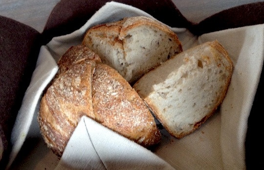 Galleria fotografica






In cammino verso il Noma. Il ristorante è al piano terra del palazzone più a sinistra. Per arrivarci dalla popolare insenatura di Nyhavn (il punto da cui è scattata la foto), occorre fare un bel giro. Ma si notano i lavori per la costruzione di un ponte. Che condurrà dritto all'insegna








Altra prospettiva sul Noma da Nyhavn. Il ristorante galleggia sulla Christianshavn, una delle tante isole artificiali che compongono Copenhagen








Di là del fiume, sulla lunga via che conduce allo spiazzo del Noma








Uno scenario molto tranquillo, di case pastello. Il silenzio è perché vanno tutti in bici













Al massimo si sente rombare qualche scafo








Il vascello davanti al Noma. Oltre a quella danese, sventolano le bandiere di Isole Far Oer e Groenlandia: le loro ambasciate sono nello stesso palazzo del ristorante. Coerenza nordica








Il retro del ristorante. L'80% delle 80 persone che lavorano al Noma viene a lavorare in bici, chef incluso








Dietro al ristorante, un'iscrizione ricorda i passeggeri scomparsi a bordo della danese Hans Hedtoft. Il transatlantico si scontrò il 30 gennaio 1959 contrò un iceberg in Groenlandia. Fu ritrovata solo una cintura di sicurezza
 








L'ingresso del ristorante, al civico 93 di Strandgade








La vista, ingresso alle spalle








Tra l'ingresso e la cucina a vista, spicca un corner di decoro simil-giapponese. A sinistra s'intravede Noma, time and place in Nordic Cuisine, edizioni Phaidon, un testo fondamentale per approfondire tutti i rivoli del Redzepi-mondo. La versione italiana si ordina qui








Una pianta di piccoli agrumi orla la cucina a vista








La porta d'ingresso vista dalla cucina








Le sedie, molto comode, sono anni Sessanta con schienali foderati di pelle di pecora, alcune più morbide di altre








I tavoli sono ampi e senza tovaglie. Attorno prevale il grigio e i colori rustici, sulle travi in legno del soffitto ma anche sulle divise dei ragazzi di sala








La finestra accanto al nostro tavolo








E' lo chef Rene Redzepi a introdurci al pasto: in un vaso di fiori danesi, l'unico pendaglio commestibile è una sorta di carta musica croccante (flatbread) di farina di malto all'aroma di ginepro. Nel piattino in basso, una deliziosa crème fraîche acida per intingerlo








Il flatbread è quello che svetta. "Ma se ci tenete, provate a mangiare anche i fiori", scherza Redzepi. Il cuoco scompare nelle segrete del Noma. Lo ritroveremo solo alla fine del pasto








Tutti i 14 appetizer si mangeranno con le mani. Unica posata, il coltello per tirar su e leccare la crème fraîche da sola (da fare quando tutti gli altri clienti son distratti, però)








Moss and Cep: Muschio di renna con polvere di funghi porcini. E' il corpo bianco, molto saporito ed evanescente, da intingere anch'esso nella crème fraîche
 








Crispy pork skin and black currant: Pelle di maiale croccante e ribes nero, lo strato più esterno. Aspro e croccante








Il ribes nero non ci lascerà prima di molto tempo








Blue mussels and celery: cozze e sedano. Solo due sono quelle buone








La parte inferiore del guscio è commestibile (ancora farina di malto)








Il quinto appetizer è nascosto in una deliziosa scatola di biscotti in latta della tradizione danese (chi non ricorda i Danish butter cookies?)








Cinque tondini, ma solo due "interessanti"








Si chiamano Cheese cookies, rocket and stems, letteralmente Biscotti al formaggio, ruchetta e gambi di erbe aromatiche, un felice snack potenzialmente riproducibile nei nord e nei sud del mondo








Appetizer #6: Potato and duck liver, Patate e fegato d'anatra: le patate croccanti sono in due strati e a mo' di sandwich racchiudono la mousse di fegato. La spolverata è di funghi trombette dei morti, disidratati e polverizzati, una tecnica che troveremo frequentemente








Dried carrot and sorrel, Carote grigliate a fuoco lento per 14 ore, disidratate e servite su polvere di fieno. Si intingono nell'emulsione di acetosella accanto. Un grande piatto perché di inattesa, energica acidità








Ottava entrée: Caramelized milk and cod liver, Biscotto di latte caramellato e fegato di merluzzo, quest'ultimo ghiacciato e pulito. Il secondo dona un aroma molto strong, che domina sul biscotto croccante. Per palati muscolari








Le uova dentro l'uovo








Pickled and smoked quails eggs, Uova di quaglia sbollentate, marinate e affumicate, un classico del Noma. Il tuorlo è completamente liquido








Col Veal fibres and söl, Filamenti di vitello e söl, decimo appetizer, entra in gioco per la prima volta un'alga di mare. E' il söl, appunto, dulse in inglese, Palmaria palmata nella tassonomia scientifica, un'alga rossa incastrata nei filamenti di vitello precedentemente tagliati sottili e poi fritti. Curioso l'impiatto a nido di ingredienti che alla fine incastrano terra e mare








Herb Toast and smoked cod roe, Toast alle erbe e uova di merluzzo affumicato, un'altra grandiosa tapa nordica da far su in due bocconi. Se non ricordiamo male, lo strato superiore è brodo di fegato d'anatra disidratato








Radish, soil and grass, Rapanello, "suolo" ed erba, un altro grande classico del Noma, un paesaggio commestibile di chiara genesi basca-adrianesca, molto replicato negli anni. Carote baby e rapanelli sono interrati in un "suolo" che è una crema di farina di malto con nocciole disidratate. Sotto ancora, uno yogurt di erbe. Finite le verdure, abbiamo chiesto dei cucchiaini per ripulire il suolo








Una foto (di spreadbutter) chiarisce meglio il contenuto del vasetto








Æbleskiver e muikku, penultimo appetizer, di concezione piuttosto recente. Un'antica tradizione dolce danese (Æbleskiver significa "piccoli pezzi di mela" ma la mela qui non c'è) è presentata in versione salata. Code e teste dei muikku, sorta di aringhe baby, sono infilzate in due bigné dall'impasto molto morbido con del ripieno di cetriolo marinato, ben riconoscibile al palato. L'aspetto dispone il cliente alla sfida ma la sua bizzarria visiva si scioglie presto in due bocconi morbidi, eleganti e deliziosi








Ultimo di 14 appetizer: Sorrel leaf and cricket paste, Foglia di acetosella (leggermente piccante) con pasta di grillo. Sì, proprio l'insetto dei prati, qui in consistenza di crema, inserita nel gambo dell'acetosella. Mettendo a fermentare grilli e orzo fermentato, Redzepi ha ottenuto una sorta di garum molto interessante, simile alla soia. Completa il piatto in foto, una granita di nasturzio ghiacciato








E il vino? Non producendo la Danimarca nettari di rilievo, è forse il capitolo meno allettante del Noma. La carta è un trionfo di vini ottenuti in climi freddi: francesi, tedeschi o austriaci soprattutto. Vini di acidità spinta che si combinano bene con le prevalenti acidità dei piatti. Le persone inquadrate nella foto hanno optato per il pairing coi succhi di frutta, quelli sì interessanti e autoctoni: il percorso prevede 7-8 succhi tra cui carote e ginepro, sedano e sedanorapa, cetriolo, eccetera. E i vini italiani? Pochi e tutti rossi, soprattutto di produttori di nebbiolo del Piemonte. "Ma li chiedono solo i norvegesi", ci raccontano








Terminati appetizer e main courses, sbirciamo i lavori in cucina. In primo piano, Samuel Nutter, sous chef inglese








Al centro, riconosciamo Matthew Orlando di San Diego, 35 anni e da 4 e mezzo head chef del Noma. Più tardi ci rivelerà che entro un paio d'anni aprirà il suo ristorante a Copenhagen. "E Renè che ne pensa?", chiediamo. "E' proprio lui a incoraggiarci a metterci in proprio", risponde Orlando. Vero, chiedere anche a Christian Puglisi








Ancora Orlando ci spiegherà che, tra sala, cucina, preparazioni e laboratorio, il Noma arriva a impiegare dall'alba a mezzanotte fino a 80 persone








La cucina prevede 7 comparti: il caldo, il freddo, la pasticceria, gli snack, produzione e mise-en-place, le preparazioni della squadra del mattino e la ricerca (su quest'ultima torneremo più avanti). Gli stagisti scelgono di lavorarci, sapendo di non essere pagati. Redzepi riceve un centinaio di curricula a settimana








Torniamo a tavola e troviamo nuove posate: rami appuntiti di sambuco








Servono a infilzare il primo delle portate "serie", Potato and snails, patate e lumache, servito in due piatti. Il primo è una terrina (rovente) di piccole deliziose patate affumicate e semiaffogate in una salsa al burro dolce e al tavolo spolverate con sale proprio di sambuco. Accanto, piccoli ceppi d'albero affumicati








Accanto, l'altra metà del piatto da infilzare coi bastoncini di sambuco: lumache glassate nel loro succo con burro dolce, olio al prezzemolo ed emulsione di piselli fermentati








Dopo 15 portate arrivano le posate. "Si torna alla civiltà", scherza il ragazzo di sala








...e arriva pure il pane, nascosto in una stoffa soffice con accanto due ciotoline che contengono burro da latte di capra e burro di grasso e crumble di maiale. Colesterolemici, vade retro





