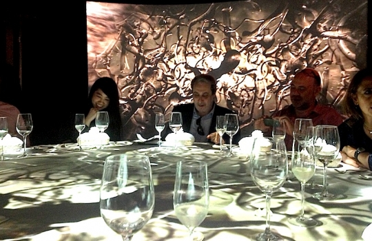 Galleria fotografica






Le prove generali








Prove del primo atto: al centro, il Bonsai di pica-pica


















Comincia la nostra esperienza: occhio all'indirizzo del centro Arts Santa Monica








Fuori staziona il van di Girona con tutto il nécessaire commestibile








Dentro, la targa coi ringraziamenti a tutti coloro che hanno lavorato al progetto








Per arrivare al set dell'opera si attraversa una mostra che proietta in oblò teaser coi motivi anticipatori di quel che troveremo dentro








Un altro teaser








Il set prima delle trasmissioni













Si parte








Una spirale ci introduce al viaggio








Al centro del tavolo, nascosto tra bonsai (un classico rochiano), pica-pica di bon bon rappresentativi di vari paesi: cevice peruviano, guacamole messicano, cous-cous marocchino...








Commensali spiazzati








Il sogno ha inizio: l'atto primo mette in tavola la Luna, sfere di tartufo bianco e nero con distillato terrestre








Intorno, un video di Franc Aleu, le musiche di Luca Francesconi e il tableware di Taller Luesma Vega








La luna








Atto secondo: lo spazio








Piatto dello spazio: aria di fichi di Cap de Creus








C'è un calice diverso per ogni atto: si passa dal cava agli champagne, dall'Armagnac ai Rioja a semplici gocce di distillati, versati anche sulla mano








Intorno, un altro splendido 3D di Franc Aleu, con le musiche di Sergi Caballero, Pedro Alcade








E' l'ofiuco, il tredicesimo segno zodiacale, tema del terzo atto













Atto quarto: Under the Sea, il set  diventa uno scenario sottomarino (vedi video 1)













E a tavola arriva una composizione golosissima di piatti di mare, servita in sculture di Pere Gifre e Dani Molina: vellutata di ricci grigliati, anemoni impanati, parmentier di octopus, marinata di frutti di mare e cirripedi













Tra un atto e l'altro, la voce calma di Josep Roca


















Atto Quinto, il Giardino delle Esperidi, dal sapore orientale: nel piatto, un fiore Mandala con limone, curry, bietole, mango, cocco, finocchio, yogurt, cannella, cardamomo, menta, zenzero, pepe, fiori, carciofi e agnello













Atto Sesto: il Corteggiamento













Motivi Yin Yang ovunque: nelle musiche di Albert Guinovart, nei video di Franc Aleu. E nel piatto dei Roca: Ostriche marinate in sherry Palo Cortado, salsa di ostriche, aglio bianco e nero








Ci si prepara ai fuochi d'artificio del settimo atto. I 12 camerieri si avvertono appena, se non quando illuminati dalle scenografie








Atto sette: i piatti sono creazioni ispirate ai fossili di Roos Van de Velde








Dopo la mela candita, tema dell'ottavo atto, l'opera assume i toni ancora più foschi nel nono, la Guerra: Royale d'oca con gocce di sangue di bietola. Le musiche di Wolfgang Mitterer e le immagini di Franc Aleu si fanno cruente (vedi video 2)








Atto Dieci: Misericordia/Morte








Spuma di patate viola, bon bon di gelato di genziana, midollo di vitello, rabarbaro con caviale e funghi trombette della morte. Attorno, fumi d'incenso di Artemisia





