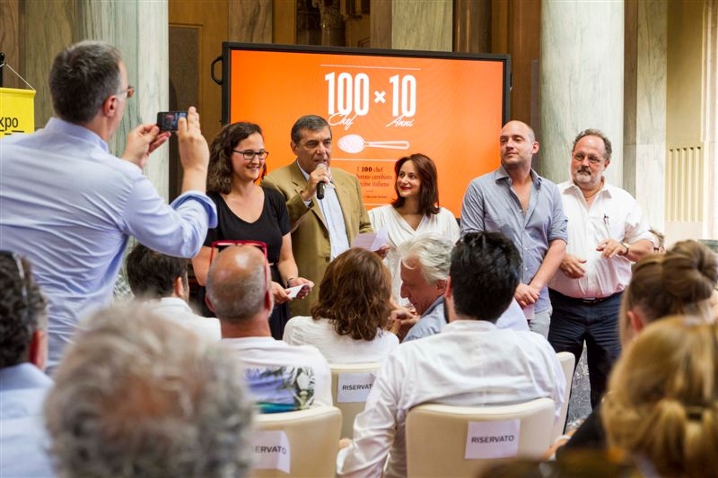 Galleria fotograficaLa presentazione di "100 chef x 10 anni": il microfono a Claudio Ceroni, patron MAGENTAbureauPaolo Marchi con Massimo BotturaGli chef affacciati alla balconata della Stazione Centrale di MilanoIl saluto degli chef