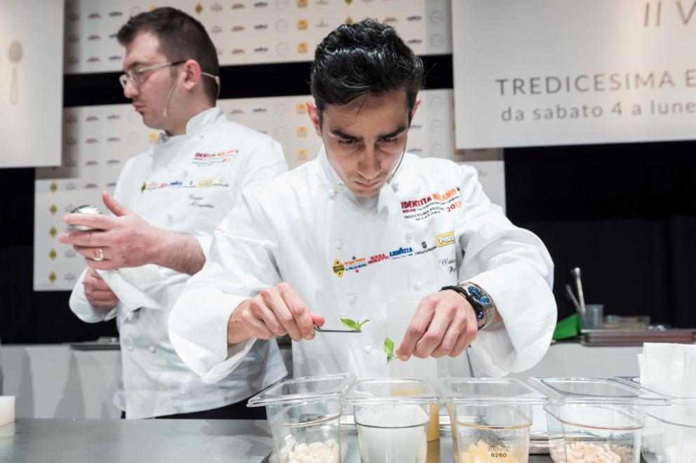 Galleria fotografica






Al Caffè Sicilia di Noto la connessione fra ostrica e fragola, salsedine e fruttosio, è pratica quotidiana, gesto consueto da sempre. Sicuramente da prima che Adrià canonizzasse la simbiosi fra dolce e salato. Perché il pasticciere resiliente Corrado Assenza fa come fa la natura, che unisce, non separa, e trasforma. Viaggio di sola andata in due tappe: Candido, colorato e profumato e Senza tempo, senza spazio














Candido, colorato e profumato









Senza tempo, senza spazio









Classe 1991, cuoca dolce da due stelle Michelin al Moments del Mandarin Oriental Hotel di Barcellona e un posto di diritto nella classifica dei 30 artisti under 30 più influenti d’Europa stilata da Forbes. Ritratto in pillole di lady chef Andrea Dopico Cafarelli che ha titolato la sua lezione “7.494 Km”, ovvero la distanza che corre fra la sua città natale (Caracas) e quella dove vive (Barcellona)



















Eau du chocolat









"Miglior Chef Pasticcere per la Guida di Identità Golose 2017 ma anche quella del Gambero Rosso, Andrea Tortora firma l'intera proposta dolce del St. Hubertus, il regno di Norbert Niederkofler. Il titolo della sua lezione, una massima-memento che lo guida nel lavoro: “È l’intreccio di obbedienza e libertà a renderci creativi”, un viaggio in cinque creazioni



















Canederlo Gianduja









Mark Welker era lì, al suo posto di executive pastry chef del gruppo Make it nice quando il ristorante Eleven Madison Park di New York ha firmato l’impossibile scalata da zero stelle a tre in soli due anni. Sul palco di Identità golose il giovane cuoco ha presentato “La filosofia di cucina dell’Eleven Madison Park”, per mezzo di una avveniristica Pears with Caramelized White Chocolate. Applausi dal pubblico in sala anche per i Pretzels al cioccolato proposti all’assaggio














Pera con cioccolato bianco caramellizzato









Beppe Allegretta (Unico, Milano), Gianluca Fusto (Gianluca Fusto Consulting), Mario Peqini (Tosca, Ginevra - Svizzera), Galileo Reposo (Peck, Milano), ovvero un gruppo di pesi massimi della pasticceria uniti da un DOLCE LEGaME. Quale? Quello con il Luogo di Aimo e Nadia, dove tutti hanno occupato il ruolo di pastry chef per almeno cinque anni a testa, tasselli di storia nel luogo che ha fatto la storia della cucina italiana. Fagioli, crema Valrhona alle mandorle, limoni di Amalfi canditi 72 ore, un DOLCE LEGaME moltiplicato per vent’anni e 500 assaggi











