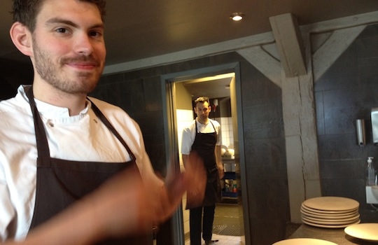 Galleria fotografica






In cammino verso il Noma. Il ristorante è al piano terra del palazzone più a sinistra. Per arrivarci dalla popolare insenatura di Nyhavn (il punto da cui è scattata la foto), occorre fare un bel giro. Ma si notano i lavori per la costruzione di un ponte. Che condurrà dritto all'insegna








Altra prospettiva sul Noma da Nyhavn. Il ristorante galleggia sulla Christianshavn, una delle tante isole artificiali che compongono Copenhagen








Di là del fiume, sulla lunga via che conduce allo spiazzo del Noma








Uno scenario molto tranquillo, di case pastello. Il silenzio è perché vanno tutti in bici













Al massimo si sente rombare qualche scafo








Il vascello davanti al Noma. Oltre a quella danese, sventolano le bandiere di Isole Far Oer e Groenlandia: le loro ambasciate sono nello stesso palazzo del ristorante. Coerenza nordica








Il retro del ristorante. L'80% delle 80 persone che lavorano al Noma viene a lavorare in bici, chef incluso








Dietro al ristorante, un'iscrizione ricorda i passeggeri scomparsi a bordo della danese Hans Hedtoft. Il transatlantico si scontrò il 30 gennaio 1959 contrò un iceberg in Groenlandia. Fu ritrovata solo una cintura di sicurezza
 








L'ingresso del ristorante, al civico 93 di Strandgade








La vista, ingresso alle spalle








Tra l'ingresso e la cucina a vista, spicca un corner di decoro simil-giapponese. A sinistra s'intravede Noma, time and place in Nordic Cuisine, edizioni Phaidon, un testo fondamentale per approfondire tutti i rivoli del Redzepi-mondo. La versione italiana si ordina qui








Una pianta di piccoli agrumi orla la cucina a vista








La porta d'ingresso vista dalla cucina








Le sedie, molto comode, sono anni Sessanta con schienali foderati di pelle di pecora, alcune più morbide di altre








I tavoli sono ampi e senza tovaglie. Attorno prevale il grigio e i colori rustici, sulle travi in legno del soffitto ma anche sulle divise dei ragazzi di sala








La finestra accanto al nostro tavolo








E' lo chef Rene Redzepi a introdurci al pasto: in un vaso di fiori danesi, l'unico pendaglio commestibile è una sorta di carta musica croccante (flatbread) di farina di malto all'aroma di ginepro. Nel piattino in basso, una deliziosa crème fraîche acida per intingerlo








Il flatbread è quello che svetta. "Ma se ci tenete, provate a mangiare anche i fiori", scherza Redzepi. Il cuoco scompare nelle segrete del Noma. Lo ritroveremo solo alla fine del pasto








Tutti i 14 appetizer si mangeranno con le mani. Unica posata, il coltello per tirar su e leccare la crème fraîche da sola (da fare quando tutti gli altri clienti son distratti, però)








Moss and Cep: Muschio di renna con polvere di funghi porcini. E' il corpo bianco, molto saporito ed evanescente, da intingere anch'esso nella crème fraîche
 








Crispy pork skin and black currant: Pelle di maiale croccante e ribes nero, lo strato più esterno. Aspro e croccante








Il ribes nero non ci lascerà prima di molto tempo








Blue mussels and celery: cozze e sedano. Solo due sono quelle buone








La parte inferiore del guscio è commestibile (ancora farina di malto)








Il quinto appetizer è nascosto in una deliziosa scatola di biscotti in latta della tradizione danese (chi non ricorda i Danish butter cookies?)








Cinque tondini, ma solo due "interessanti"








Si chiamano Cheese cookies, rocket and stems, letteralmente Biscotti al formaggio, ruchetta e gambi di erbe aromatiche, un felice snack potenzialmente riproducibile nei nord e nei sud del mondo








Appetizer #6: Potato and duck liver, Patate e fegato d'anatra: le patate croccanti sono in due strati e a mo' di sandwich racchiudono la mousse di fegato. La spolverata è di funghi trombette dei morti, disidratati e polverizzati, una tecnica che troveremo frequentemente








Dried carrot and sorrel, Carote grigliate a fuoco lento per 14 ore, disidratate e servite su polvere di fieno. Si intingono nell'emulsione di acetosella accanto. Un grande piatto perché di inattesa, energica acidità








Ottava entrée: Caramelized milk and cod liver, Biscotto di latte caramellato e fegato di merluzzo, quest'ultimo ghiacciato e pulito. Il secondo dona un aroma molto strong, che domina sul biscotto croccante. Per palati muscolari








Le uova dentro l'uovo








Pickled and smoked quails eggs, Uova di quaglia sbollentate, marinate e affumicate, un classico del Noma. Il tuorlo è completamente liquido








Col Veal fibres and söl, Filamenti di vitello e söl, decimo appetizer, entra in gioco per la prima volta un'alga di mare. E' il söl, appunto, dulse in inglese, Palmaria palmata nella tassonomia scientifica, un'alga rossa incastrata nei filamenti di vitello precedentemente tagliati sottili e poi fritti. Curioso l'impiatto a nido di ingredienti che alla fine incastrano terra e mare








Herb Toast and smoked cod roe, Toast alle erbe e uova di merluzzo affumicato, un'altra grandiosa tapa nordica da far su in due bocconi. Se non ricordiamo male, lo strato superiore è brodo di fegato d'anatra disidratato








Radish, soil and grass, Rapanello, "suolo" ed erba, un altro grande classico del Noma, un paesaggio commestibile di chiara genesi basca-adrianesca, molto replicato negli anni. Carote baby e rapanelli sono interrati in un "suolo" che è una crema di farina di malto con nocciole disidratate. Sotto ancora, uno yogurt di erbe. Finite le verdure, abbiamo chiesto dei cucchiaini per ripulire il suolo








Una foto (di spreadbutter) chiarisce meglio il contenuto del vasetto








Æbleskiver e muikku, penultimo appetizer, di concezione piuttosto recente. Un'antica tradizione dolce danese (Æbleskiver significa "piccoli pezzi di mela" ma la mela qui non c'è) è presentata in versione salata. Code e teste dei muikku, sorta di aringhe baby, sono infilzate in due bigné dall'impasto molto morbido con del ripieno di cetriolo marinato, ben riconoscibile al palato. L'aspetto dispone il cliente alla sfida ma la sua bizzarria visiva si scioglie presto in due bocconi morbidi, eleganti e deliziosi








Ultimo di 14 appetizer: Sorrel leaf and cricket paste, Foglia di acetosella (leggermente piccante) con pasta di grillo. Sì, proprio l'insetto dei prati, qui in consistenza di crema, inserita nel gambo dell'acetosella. Mettendo a fermentare grilli e orzo fermentato, Redzepi ha ottenuto una sorta di garum molto interessante, simile alla soia. Completa il piatto in foto, una granita di nasturzio ghiacciato








E il vino? Non producendo la Danimarca nettari di rilievo, è forse il capitolo meno allettante del Noma. La carta è un trionfo di vini ottenuti in climi freddi: francesi, tedeschi o austriaci soprattutto. Vini di acidità spinta che si combinano bene con le prevalenti acidità dei piatti. Le persone inquadrate nella foto hanno optato per il pairing coi succhi di frutta, quelli sì interessanti e autoctoni: il percorso prevede 7-8 succhi tra cui carote e ginepro, sedano e sedanorapa, cetriolo, eccetera. E i vini italiani? Pochi e tutti rossi, soprattutto di produttori di nebbiolo del Piemonte. "Ma li chiedono solo i norvegesi", ci raccontano





