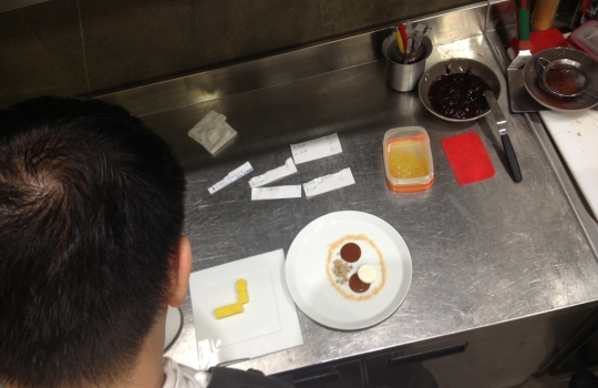 Photogallery






 
Modena’s colonnades, 186 thousand inhabitants and 3 restaurants with at least one Michelin star: Hostaria del Mare (1), Erba del Re (1) and Osteria Francescana (3 stars), our destination
 








Yellow and red tones prevail








The city still bears the signs of the May 2012 earthquake. On May 4th 2013, the day of our visit, a 3.8 magnitude earthquake was registered













By chance, Giuseppe Palmieri, maître and sommelier, appears from the grey door








Palmieri, 38, born in Matera. His first service in Francescana was on September 12th 2000








The old entrance to the restaurant, at number 24 in Via della Stella - as on the opening in 1995. It changed in September 2012: today you enter from number 22. Funnily enough, Google Maps is still set on the old entrance








The present entrance doors








Let’s start








After the latest renovations, the transit areas inside the Osteria appear as a contemporary art gallery








Mario Schifano’s world map








"Tourists", Maurizio Cattelan’s famous pigeons








Underneath the pigeons, Gavin Turk’s “Trashbag”








Three rooms, 12 tables, between 20 to 35 guests. 40% guests are Italian








Every table is illuminated by Davide Groppi’s Sampei lamp: if tables are moved, light follows








Francescana receives 150 reservations every day. But it also suffers from clients not showing up: on average, one table every week is booked but then guests don’t come








Right behind the kitchen, there’s the prêt-à-porter cellar








"In the central cellar, we only keep great vintages and larger bottles of what we consider to be great wines", Beppe Palmieri explains








1,600 wines are listed at Osteria Francescana, with a deep wine list which includes different vintages of the same wine








"A true celebration of wine "








The Ferrari coat, hanging in the cellar: Maranello is only 17 km away from Modena








Jean Todt, Michael Schumacher, Fernando Alonso: Ferrari’s “prancing horse” is at home in Via Stella








Gabrio Bini’s wines, from Pantelleria, a real fetish for Palmieri













Hanging from the ceiling, a nice selection of cured meats from Emilia








Bread made with mother yeast, the premise to a journey which will alternate great classics with very contemporary dishes








Massimo Bottura. Fifty years old last September, he is chef since 1986, the year of Trattoria del Campazzo in Nonantola. His first masters: Lidia Cristoni and Georges Cogny








He’s glowing: a few days ago his restaurant climbed, for the first time, onto the podium of the World's 50Best, a prize that is acquiring an increasing weight and authority. "The thing that makes me the happiest", he says, "is not so much the third place, but the fact that we’ve been in the highest positions for a few years now". True: 13th in 2009, 6th in 2010, 4th in 2011, 5th in 2012, 3rd in 2013








The now famous grey New Balance 993, a real emblem for the chef, friend of Jason Weis, president of the company in Massachusetts. The insole, however, is local: "In Emilia the sector is state-of-the-art", he says








"Are we ready?"








Almond granita with capers, bergamot and coffee cream 
Bottura and Palmieri’s journey across Italy starts from the bottom. And sails off from the Sicilian inland, with a classic granita which in Modena crumbles Adria-style, the wall that divides sweet from savoury, using the picklock of bitterness: Pantelleria capers, wild oregano but also bergamot, a coffee concentrate and vanilla scented salt. To pair with the first part of the meal, Sorriso di Cielo malvasia dei colli piacentini








Mediterranean Macaroon 
Next to the granita, two peculiar macaroons: the first is made with minced anchovies and sardines, the second with oysters and seaweeds. This is a classic scheme in Bottura’scuisine: his ironic turning the order of the dishes, from starter to dessert, upside down, and using popular raw materials instead of ingredients that are emblematic of élite cuisine. «While feet are sinking in the ground, the head is free to move everywhere», is one of his most famous quotes








Tempura of freshwater aulla with carpione ice-cream
Carpione ice-cream on a tempura of freshwater aulla – these fish are similar and slightly bigger than whitebait. The tempura is made by quickly placing the cold batter in boiling oil








Bread and croissants








Grissini








Baccalà Mare Nostrum 
We move up the Tyrrhenian sea to find this salted codfish cooked at low temperature and then seasoned with a touch of Naples and the Amalfi coast, that is to say with an emulsion made with hot oil with tomato vegetal liquid, olives, the zest of Sorrento’s super lemons and some anchovy colatura. These aromas crack with the scented bread on top








40 year old Denis Bretta explains the dishes as if from a book. Once at Restaurant Fini in Modena, for the past year and a half he’s been the manager responsible for the service in the restaurant. But don’t ask Palmieri to explain his role, as he’s abolished all hierarchies: "In our restaurant there are no commis or chef de rang. At a time when titles are so abused, I prefer for us to be all colleagues. All waiters."








How to burn sardines in three days 
Another journey, another horizon, the Adriatic Sea between Romagna and Ancona. A new camouflaged expression: these are not sardines (and they aren’t burnt either) but they are small sea-rock mullet, marinated for 3 days, then seared on one side on a grill, and filled like a sandwich with some (very sweet) scampi cream, and covered with vegetable ashes, aromatic herbs and lemon zest. “I wanted to make fun of the Marche-Romagna habit of grilling everything”, the chef says, “with lemon, garlic and parsley always added later to fix everything”









Rice, between fresh and sea water 
Recalling the Po estuary with freshwater and brackish sensations. The freshwater flavours cover the surface of the oyster which prevails on the river bed. And in the end, catfish, carp, vegetable chlorophyll and carpione win once again








 
A journey to Modena: Adriatic eel, polenta, Campanine apple jelly and saba
Another fluvial odyssey, presented for the first time at Identità Milano in 2011. The Adriatic eel travels across Veneto (with the polenta cream), Mantua (the Campanine apple jelly), the countryside of Modena (with the Saba lacquering, that is to say the mother of Aceto Balsamico) and stops in the centre of Modena (blackened powdered onion, a mimesis of the town’s canals)
 








Normandy
That is to say pre-salè lamb (hanging for 20 days) with an emulsion of oyster water, fresh seaweeds and caviar. On top, a green apple granita that recalls cider. “This is our tribute to Normandy”, Bretta says, “in Modena there are no enchanted beaches or breath-taking mountain tops. From Via Stella you can’t even see the Torre Ghirlandina. What guides us is the persistant strength of ideas, woven into the culture and into memories”








Giovanni Boroni’s Genziana from Trentino. A brilliant idea by Palmieri that acts as a bridge between the two dishes, Normandy (previous picture) and Think Green (next one). This distillate plays an immediate contrast with the sea-character of the first dish: "To me, harmony is what is left after a confrontation", B.P. says. And the confrontation is followed by the thought that spurs from the following match: water is added to the Genziana and the palate surprisingly longs to gulp it all. This is the perfect vehicle for the aromas of the genziana and "gives length" to the minerality of the wild herbs. "This serves to recall water, our true source of richness". Brilliant








Think Green
Vegetal chlorophyll, asparagus tops, pea cream, mushrooms, truffle, flowers, aromatic herbs and Parmigiano Reggiano curd. The idea of this dish came after observing the biological cycle of grazing cows, 4 seasons that sum up all of life. “This is what the cow eats, and what it returns to us, thanks to an extraordinary milk”, Bottura adds








Five ages of Parmigiano Reggiano 
A great classic from 1996, "when the textures in fact were 3", Palmieri points out. Today they are 5: 4 month ageing cream, 30 month demi-soufflè, 36 month mousse, 40 month crispy wafer, on top, “air” of 50 month Parmesan. (photo by Le Saucier)








A compression of pasta and beans 
Another great classic, this is a journey across Bottura’s experiences in the kitchen: Creme royal with pork rind, beans and foie gras (French tradition), rosemary air (the Spanish vanguard) and Parmesan crust (the Emilian essence) used instead of pasta. “This is a dish based on evolution, not revolution. I compressed my grandmother between Alain Ducasse and Ferran Adrià”








Snails under the grapevines 
Snails, aromatic chlorophyll on a bed of wild vegetables and herbs, with mushrooms, truffle and bulbs. After the cow’s life cycle, here comes that of the snail. "Once again, we’re chewing the territory: the best snails slither in the vineyards, among mineral, sapid and acid aromas"








A Frenchman’s dream of making pasta like an Italian 
Or, Ravioli with leeks, foie gras and truffle. We covered this in detail in Identità di Pasta issue number 27








Damijan Podversic’s Ribolla Gialla, a great wine by a wine producer from Gorizia inspired by Josko Gravner. It will support the following dish, without concealing it








A sharp knife is only served now. Another sign of the “allergy” to lengthy chewing that characterises most of contemporary high cuisine








Pigeon hunt 
And over to Bretta: "This is served in a balsamic sauce made with beetroots, which recalls blood. The salad is made with fake leaves, made by cutting out some tubers using some small stamps. These are then compressed in a vacuum with different types of vinegar. The horseradish is grated a few seconds before service, to give some velocity to the pigeon". Irony wins, since "pigeons are not hunted". The bird supplier is Franco Cazzamali from Cremona








Before the dessert, a trip to the restroom: vegetal notes prevail here too








A visit to the kitchen: capon stock








The chef watches over everything, even on the loud music wired wireless from the ceiling. When we get inside, Rod Stewart is screaming "Do you think I'm sexy?"








Meanwhile, the sauces are prepared for the evening service. There’s no break between lunch and dinner. "People sometimes leave at 5 pm because they come here to enjoy the experience of a lifetime", Palmieri reveals, "We work non-stop and every year is worse (or better, that is to say). Don’t ask me anything after midnight, though, because I can’t think straight"





