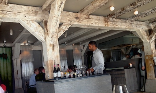 Galleria fotografica






In cammino verso il Noma. Il ristorante è al piano terra del palazzone più a sinistra. Per arrivarci dalla popolare insenatura di Nyhavn (il punto da cui è scattata la foto), occorre fare un bel giro. Ma si notano i lavori per la costruzione di un ponte. Che condurrà dritto all'insegna








Altra prospettiva sul Noma da Nyhavn. Il ristorante galleggia sulla Christianshavn, una delle tante isole artificiali che compongono Copenhagen








Di là del fiume, sulla lunga via che conduce allo spiazzo del Noma








Uno scenario molto tranquillo, di case pastello. Il silenzio è perché vanno tutti in bici













Al massimo si sente rombare qualche scafo








Il vascello davanti al Noma. Oltre a quella danese, sventolano le bandiere di Isole Far Oer e Groenlandia: le loro ambasciate sono nello stesso palazzo del ristorante. Coerenza nordica








Il retro del ristorante. L'80% delle 80 persone che lavorano al Noma viene a lavorare in bici, chef incluso








Dietro al ristorante, un'iscrizione ricorda i passeggeri scomparsi a bordo della danese Hans Hedtoft. Il transatlantico si scontrò il 30 gennaio 1959 contrò un iceberg in Groenlandia. Fu ritrovata solo una cintura di sicurezza
 








L'ingresso del ristorante, al civico 93 di Strandgade








La vista, ingresso alle spalle








Tra l'ingresso e la cucina a vista, spicca un corner di decoro simil-giapponese. A sinistra s'intravede Noma, time and place in Nordic Cuisine, edizioni Phaidon, un testo fondamentale per approfondire tutti i rivoli del Redzepi-mondo. La versione italiana si ordina qui








Una pianta di piccoli agrumi orla la cucina a vista








La porta d'ingresso vista dalla cucina








Le sedie, molto comode, sono anni Sessanta con schienali foderati di pelle di pecora, alcune più morbide di altre








I tavoli sono ampi e senza tovaglie. Attorno prevale il grigio e i colori rustici, sulle travi in legno del soffitto ma anche sulle divise dei ragazzi di sala








La finestra accanto al nostro tavolo








E' lo chef Rene Redzepi a introdurci al pasto: in un vaso di fiori danesi, l'unico pendaglio commestibile è una sorta di carta musica croccante (flatbread) di farina di malto all'aroma di ginepro. Nel piattino in basso, una deliziosa crème fraîche acida per intingerlo








Il flatbread è quello che svetta. "Ma se ci tenete, provate a mangiare anche i fiori", scherza Redzepi. Il cuoco scompare nelle segrete del Noma. Lo ritroveremo solo alla fine del pasto








Tutti i 14 appetizer si mangeranno con le mani. Unica posata, il coltello per tirar su e leccare la crème fraîche da sola (da fare quando tutti gli altri clienti son distratti, però)








Moss and Cep: Muschio di renna con polvere di funghi porcini. E' il corpo bianco, molto saporito ed evanescente, da intingere anch'esso nella crème fraîche
 








Crispy pork skin and black currant: Pelle di maiale croccante e ribes nero, lo strato più esterno. Aspro e croccante








Il ribes nero non ci lascerà prima di molto tempo








Blue mussels and celery: cozze e sedano. Solo due sono quelle buone








La parte inferiore del guscio è commestibile (ancora farina di malto)








Il quinto appetizer è nascosto in una deliziosa scatola di biscotti in latta della tradizione danese (chi non ricorda i Danish butter cookies?)








Cinque tondini, ma solo due "interessanti"








Si chiamano Cheese cookies, rocket and stems, letteralmente Biscotti al formaggio, ruchetta e gambi di erbe aromatiche, un felice snack potenzialmente riproducibile nei nord e nei sud del mondo








Appetizer #6: Potato and duck liver, Patate e fegato d'anatra: le patate croccanti sono in due strati e a mo' di sandwich racchiudono la mousse di fegato. La spolverata è di funghi trombette dei morti, disidratati e polverizzati, una tecnica che troveremo frequentemente








Dried carrot and sorrel, Carote grigliate a fuoco lento per 14 ore, disidratate e servite su polvere di fieno. Si intingono nell'emulsione di acetosella accanto. Un grande piatto perché di inattesa, energica acidità








Ottava entrée: Caramelized milk and cod liver, Biscotto di latte caramellato e fegato di merluzzo, quest'ultimo ghiacciato e pulito. Il secondo dona un aroma molto strong, che domina sul biscotto croccante. Per palati muscolari








Le uova dentro l'uovo








Pickled and smoked quails eggs, Uova di quaglia sbollentate, marinate e affumicate, un classico del Noma. Il tuorlo è completamente liquido








Col Veal fibres and söl, Filamenti di vitello e söl, decimo appetizer, entra in gioco per la prima volta un'alga di mare. E' il söl, appunto, dulse in inglese, Palmaria palmata nella tassonomia scientifica, un'alga rossa incastrata nei filamenti di vitello precedentemente tagliati sottili e poi fritti. Curioso l'impiatto a nido di ingredienti che alla fine incastrano terra e mare








Herb Toast and smoked cod roe, Toast alle erbe e uova di merluzzo affumicato, un'altra grandiosa tapa nordica da far su in due bocconi. Se non ricordiamo male, lo strato superiore è brodo di fegato d'anatra disidratato








Radish, soil and grass, Rapanello, "suolo" ed erba, un altro grande classico del Noma, un paesaggio commestibile di chiara genesi basca-adrianesca, molto replicato negli anni. Carote baby e rapanelli sono interrati in un "suolo" che è una crema di farina di malto con nocciole disidratate. Sotto ancora, uno yogurt di erbe. Finite le verdure, abbiamo chiesto dei cucchiaini per ripulire il suolo








Una foto (di spreadbutter) chiarisce meglio il contenuto del vasetto








Æbleskiver e muikku, penultimo appetizer, di concezione piuttosto recente. Un'antica tradizione dolce danese (Æbleskiver significa "piccoli pezzi di mela" ma la mela qui non c'è) è presentata in versione salata. Code e teste dei muikku, sorta di aringhe baby, sono infilzate in due bigné dall'impasto molto morbido con del ripieno di cetriolo marinato, ben riconoscibile al palato. L'aspetto dispone il cliente alla sfida ma la sua bizzarria visiva si scioglie presto in due bocconi morbidi, eleganti e deliziosi








Ultimo di 14 appetizer: Sorrel leaf and cricket paste, Foglia di acetosella (leggermente piccante) con pasta di grillo. Sì, proprio l'insetto dei prati, qui in consistenza di crema, inserita nel gambo dell'acetosella. Mettendo a fermentare grilli e orzo fermentato, Redzepi ha ottenuto una sorta di garum molto interessante, simile alla soia. Completa il piatto in foto, una granita di nasturzio ghiacciato








E il vino? Non producendo la Danimarca nettari di rilievo, è forse il capitolo meno allettante del Noma. La carta è un trionfo di vini ottenuti in climi freddi: francesi, tedeschi o austriaci soprattutto. Vini di acidità spinta che si combinano bene con le prevalenti acidità dei piatti. Le persone inquadrate nella foto hanno optato per il pairing coi succhi di frutta, quelli sì interessanti e autoctoni: il percorso prevede 7-8 succhi tra cui carote e ginepro, sedano e sedanorapa, cetriolo, eccetera. E i vini italiani? Pochi e tutti rossi, soprattutto di produttori di nebbiolo del Piemonte. "Ma li chiedono solo i norvegesi", ci raccontano








Terminati appetizer e main courses, sbirciamo i lavori in cucina. In primo piano, Samuel Nutter, sous chef inglese








Al centro, riconosciamo Matthew Orlando di San Diego, 35 anni e da 4 e mezzo head chef del Noma. Più tardi ci rivelerà che entro un paio d'anni aprirà il suo ristorante a Copenhagen. "E Renè che ne pensa?", chiediamo. "E' proprio lui a incoraggiarci a metterci in proprio", risponde Orlando. Vero, chiedere anche a Christian Puglisi








Ancora Orlando ci spiegherà che, tra sala, cucina, preparazioni e laboratorio, il Noma arriva a impiegare dall'alba a mezzanotte fino a 80 persone








La cucina prevede 7 comparti: il caldo, il freddo, la pasticceria, gli snack, produzione e mise-en-place, le preparazioni della squadra del mattino e la ricerca (su quest'ultima torneremo più avanti). Gli stagisti scelgono di lavorarci, sapendo di non essere pagati. Redzepi riceve un centinaio di curricula a settimana








Torniamo a tavola e troviamo nuove posate: rami appuntiti di sambuco








Servono a infilzare il primo delle portate "serie", Potato and snails, patate e lumache, servito in due piatti. Il primo è una terrina (rovente) di piccole deliziose patate affumicate e semiaffogate in una salsa al burro dolce e al tavolo spolverate con sale proprio di sambuco. Accanto, piccoli ceppi d'albero affumicati








Accanto, l'altra metà del piatto da infilzare coi bastoncini di sambuco: lumache glassate nel loro succo con burro dolce, olio al prezzemolo ed emulsione di piselli fermentati








Dopo 15 portate arrivano le posate. "Si torna alla civiltà", scherza il ragazzo di sala








...e arriva pure il pane, nascosto in una stoffa soffice con accanto due ciotoline che contengono burro da latte di capra e burro di grasso e crumble di maiale. Colesterolemici, vade retro








Solleviamo la stoffa: il pane è una pagnotta di lievito naturale di grano locale. La crosta è super-fragrante e il cuore molto sofficie e poroso








Cooked fava beans and beach herbs, Fave stufate gentilmente ed "erbe di spiaggia" (che poi sono diversi tipi di alghe di mare). Le fave sono fantastiche nella loro compattezza inaspettatamente dolce








Con la terza portata del ciclo "serio" veniamo ai ragazzi di sala: sono tutti molto professionali ma anche rilassati. Tra i 30 e i 40 anni, molti tatuati, ruotano di continuo al nostro tavolo: una trentina dei piatti sono stati serviti e illustrati da 10 camerieri diversi, molti dei quali cuochi dei livelli più alti della gerarchia. Il ragazzo in foto che ci serve Berries and cucumber, Bacche e cetrioli, si chiama Beau Clugston, è australiano e da poche ore è un nuovo sous-chef del Noma








Ai frutti di bosco e insalata di cetrioli si unisce del succo di camomilla...








...et voilà








Insalata di brown crab (granchi atlantici), tuorlo d'uovo, erbe di campo e il rosso sono le uova del granchio. I ragazzi si raccomandano di fare attenzione perchè potrebbe esserci del carapace o delle chele: la carne del granchio è stata rimossa tutta a mano. Noi ci scontriamo solo con un fresco schiaffo iodato








Accanto alle langoustine, scampi norvegesi, torna l'alga söl, questa volta in forma di emulsione con acqua di ostriche. I puntini rossi sono segale disidratata








Cavolfiore e pino, crema e rafano. Pensi a una capasanta e invece è un trancio di cavolfiore quello che spunta da sotto gli aghi di pino. E' ricavato dalla parte alta dell'ortaggio, arrostito a arricchito con gli aromi di pino, abete, ginepro e rafano. L'orto e il silvestre








Lucioperca con gambi di verdure. Impeccabile ma insolitamente classico nella sua concezione su salsa al burro e capperi. Incuriosisce la disposizione, che lascia intonsa più di metà del piatto. Come a voler lasciar libero il lucioperca di sguazzare di nuovo








Arrivano in tavola nuovi oggetti: olio di fieno e un cronometro. E' l'inizio del gioco di The hen and the egg, La gallina e l'uovo








The hen and the egg #2: attorno a un tegamino rovente su del fieno appena umido, notiamo una chips a spirale di patata e un uovo (d'anatra, ci dicono)








The hen and the egg #3: accanto al tegame, foglie di spinaci, aglio selvatico, germogli e fiori di campo vari








The hen and the egg #4. "Dovete rompere voi l'uovo e cuocerlo", ci spiegano armati di olio di fieno, che spruzzeranno nel tegame prima del nostro esercizio








The hen and the egg #5: son riuscito a non sbrodolare. Il piatto, spiegherà Redzepi poi, "E' un po' un invito sdrammatizzante a cucinare. Sono rimasto sorpreso dal fatto che tanti clienti non hanno mai rotto un uovo. Cerco di mostrare loro che la cucina è in fondo un esercizio molto elementare"








The hen and the egg #6: dopo 120 secondi esatti di cronometro, si uniscono all'uovo le verdure e si rimesta il tutto








The hen and the egg #7: tocco finale, una salsa di acetosella. Il piatto non è memorabile...








...ma il risultato è lo stesso delle 21 portate precedenti: piatto spazzolato The hen and the egg #8








Animelle di vitello, erbe di campo, funghi e sedanorapa. Un gran piatto, ma non esattamente quello che ti aspetti al Noma. Sottigliezze eh





