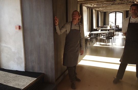 Galleria fotografica






In cammino verso il Noma. Il ristorante è al piano terra del palazzone più a sinistra. Per arrivarci dalla popolare insenatura di Nyhavn (il punto da cui è scattata la foto), occorre fare un bel giro. Ma si notano i lavori per la costruzione di un ponte. Che condurrà dritto all'insegna








Altra prospettiva sul Noma da Nyhavn. Il ristorante galleggia sulla Christianshavn, una delle tante isole artificiali che compongono Copenhagen








Di là del fiume, sulla lunga via che conduce allo spiazzo del Noma








Uno scenario molto tranquillo, di case pastello. Il silenzio è perché vanno tutti in bici













Al massimo si sente rombare qualche scafo








Il vascello davanti al Noma. Oltre a quella danese, sventolano le bandiere di Isole Far Oer e Groenlandia: le loro ambasciate sono nello stesso palazzo del ristorante. Coerenza nordica








Il retro del ristorante. L'80% delle 80 persone che lavorano al Noma viene a lavorare in bici, chef incluso








Dietro al ristorante, un'iscrizione ricorda i passeggeri scomparsi a bordo della danese Hans Hedtoft. Il transatlantico si scontrò il 30 gennaio 1959 contrò un iceberg in Groenlandia. Fu ritrovata solo una cintura di sicurezza
 








L'ingresso del ristorante, al civico 93 di Strandgade








La vista, ingresso alle spalle








Tra l'ingresso e la cucina a vista, spicca un corner di decoro simil-giapponese. A sinistra s'intravede Noma, time and place in Nordic Cuisine, edizioni Phaidon, un testo fondamentale per approfondire tutti i rivoli del Redzepi-mondo. La versione italiana si ordina qui








Una pianta di piccoli agrumi orla la cucina a vista








La porta d'ingresso vista dalla cucina








Le sedie, molto comode, sono anni Sessanta con schienali foderati di pelle di pecora, alcune più morbide di altre








I tavoli sono ampi e senza tovaglie. Attorno prevale il grigio e i colori rustici, sulle travi in legno del soffitto ma anche sulle divise dei ragazzi di sala








La finestra accanto al nostro tavolo








E' lo chef Rene Redzepi a introdurci al pasto: in un vaso di fiori danesi, l'unico pendaglio commestibile è una sorta di carta musica croccante (flatbread) di farina di malto all'aroma di ginepro. Nel piattino in basso, una deliziosa crème fraîche acida per intingerlo








Il flatbread è quello che svetta. "Ma se ci tenete, provate a mangiare anche i fiori", scherza Redzepi. Il cuoco scompare nelle segrete del Noma. Lo ritroveremo solo alla fine del pasto








Tutti i 14 appetizer si mangeranno con le mani. Unica posata, il coltello per tirar su e leccare la crème fraîche da sola (da fare quando tutti gli altri clienti son distratti, però)








Moss and Cep: Muschio di renna con polvere di funghi porcini. E' il corpo bianco, molto saporito ed evanescente, da intingere anch'esso nella crème fraîche
 








Crispy pork skin and black currant: Pelle di maiale croccante e ribes nero, lo strato più esterno. Aspro e croccante








Il ribes nero non ci lascerà prima di molto tempo








Blue mussels and celery: cozze e sedano. Solo due sono quelle buone








La parte inferiore del guscio è commestibile (ancora farina di malto)








Il quinto appetizer è nascosto in una deliziosa scatola di biscotti in latta della tradizione danese (chi non ricorda i Danish butter cookies?)








Cinque tondini, ma solo due "interessanti"








Si chiamano Cheese cookies, rocket and stems, letteralmente Biscotti al formaggio, ruchetta e gambi di erbe aromatiche, un felice snack potenzialmente riproducibile nei nord e nei sud del mondo








Appetizer #6: Potato and duck liver, Patate e fegato d'anatra: le patate croccanti sono in due strati e a mo' di sandwich racchiudono la mousse di fegato. La spolverata è di funghi trombette dei morti, disidratati e polverizzati, una tecnica che troveremo frequentemente








Dried carrot and sorrel, Carote grigliate a fuoco lento per 14 ore, disidratate e servite su polvere di fieno. Si intingono nell'emulsione di acetosella accanto. Un grande piatto perché di inattesa, energica acidità








Ottava entrée: Caramelized milk and cod liver, Biscotto di latte caramellato e fegato di merluzzo, quest'ultimo ghiacciato e pulito. Il secondo dona un aroma molto strong, che domina sul biscotto croccante. Per palati muscolari








Le uova dentro l'uovo








Pickled and smoked quails eggs, Uova di quaglia sbollentate, marinate e affumicate, un classico del Noma. Il tuorlo è completamente liquido








Col Veal fibres and söl, Filamenti di vitello e söl, decimo appetizer, entra in gioco per la prima volta un'alga di mare. E' il söl, appunto, dulse in inglese, Palmaria palmata nella tassonomia scientifica, un'alga rossa incastrata nei filamenti di vitello precedentemente tagliati sottili e poi fritti. Curioso l'impiatto a nido di ingredienti che alla fine incastrano terra e mare








Herb Toast and smoked cod roe, Toast alle erbe e uova di merluzzo affumicato, un'altra grandiosa tapa nordica da far su in due bocconi. Se non ricordiamo male, lo strato superiore è brodo di fegato d'anatra disidratato








Radish, soil and grass, Rapanello, "suolo" ed erba, un altro grande classico del Noma, un paesaggio commestibile di chiara genesi basca-adrianesca, molto replicato negli anni. Carote baby e rapanelli sono interrati in un "suolo" che è una crema di farina di malto con nocciole disidratate. Sotto ancora, uno yogurt di erbe. Finite le verdure, abbiamo chiesto dei cucchiaini per ripulire il suolo








Una foto (di spreadbutter) chiarisce meglio il contenuto del vasetto








Æbleskiver e muikku, penultimo appetizer, di concezione piuttosto recente. Un'antica tradizione dolce danese (Æbleskiver significa "piccoli pezzi di mela" ma la mela qui non c'è) è presentata in versione salata. Code e teste dei muikku, sorta di aringhe baby, sono infilzate in due bigné dall'impasto molto morbido con del ripieno di cetriolo marinato, ben riconoscibile al palato. L'aspetto dispone il cliente alla sfida ma la sua bizzarria visiva si scioglie presto in due bocconi morbidi, eleganti e deliziosi








Ultimo di 14 appetizer: Sorrel leaf and cricket paste, Foglia di acetosella (leggermente piccante) con pasta di grillo. Sì, proprio l'insetto dei prati, qui in consistenza di crema, inserita nel gambo dell'acetosella. Mettendo a fermentare grilli e orzo fermentato, Redzepi ha ottenuto una sorta di garum molto interessante, simile alla soia. Completa il piatto in foto, una granita di nasturzio ghiacciato








E il vino? Non producendo la Danimarca nettari di rilievo, è forse il capitolo meno allettante del Noma. La carta è un trionfo di vini ottenuti in climi freddi: francesi, tedeschi o austriaci soprattutto. Vini di acidità spinta che si combinano bene con le prevalenti acidità dei piatti. Le persone inquadrate nella foto hanno optato per il pairing coi succhi di frutta, quelli sì interessanti e autoctoni: il percorso prevede 7-8 succhi tra cui carote e ginepro, sedano e sedanorapa, cetriolo, eccetera. E i vini italiani? Pochi e tutti rossi, soprattutto di produttori di nebbiolo del Piemonte. "Ma li chiedono solo i norvegesi", ci raccontano








Terminati appetizer e main courses, sbirciamo i lavori in cucina. In primo piano, Samuel Nutter, sous chef inglese








Al centro, riconosciamo Matthew Orlando di San Diego, 35 anni e da 4 e mezzo head chef del Noma. Più tardi ci rivelerà che entro un paio d'anni aprirà il suo ristorante a Copenhagen. "E Renè che ne pensa?", chiediamo. "E' proprio lui a incoraggiarci a metterci in proprio", risponde Orlando. Vero, chiedere anche a Christian Puglisi








Ancora Orlando ci spiegherà che, tra sala, cucina, preparazioni e laboratorio, il Noma arriva a impiegare dall'alba a mezzanotte fino a 80 persone








La cucina prevede 7 comparti: il caldo, il freddo, la pasticceria, gli snack, produzione e mise-en-place, le preparazioni della squadra del mattino e la ricerca (su quest'ultima torneremo più avanti). Gli stagisti scelgono di lavorarci, sapendo di non essere pagati. Redzepi riceve un centinaio di curricula a settimana








Torniamo a tavola e troviamo nuove posate: rami appuntiti di sambuco








Servono a infilzare il primo delle portate "serie", Potato and snails, patate e lumache, servito in due piatti. Il primo è una terrina (rovente) di piccole deliziose patate affumicate e semiaffogate in una salsa al burro dolce e al tavolo spolverate con sale proprio di sambuco. Accanto, piccoli ceppi d'albero affumicati








Accanto, l'altra metà del piatto da infilzare coi bastoncini di sambuco: lumache glassate nel loro succo con burro dolce, olio al prezzemolo ed emulsione di piselli fermentati








Dopo 15 portate arrivano le posate. "Si torna alla civiltà", scherza il ragazzo di sala








...e arriva pure il pane, nascosto in una stoffa soffice con accanto due ciotoline che contengono burro da latte di capra e burro di grasso e crumble di maiale. Colesterolemici, vade retro








Solleviamo la stoffa: il pane è una pagnotta di lievito naturale di grano locale. La crosta è super-fragrante e il cuore molto sofficie e poroso








Cooked fava beans and beach herbs, Fave stufate gentilmente ed "erbe di spiaggia" (che poi sono diversi tipi di alghe di mare). Le fave sono fantastiche nella loro compattezza inaspettatamente dolce








Con la terza portata del ciclo "serio" veniamo ai ragazzi di sala: sono tutti molto professionali ma anche rilassati. Tra i 30 e i 40 anni, molti tatuati, ruotano di continuo al nostro tavolo: una trentina dei piatti sono stati serviti e illustrati da 10 camerieri diversi, molti dei quali cuochi dei livelli più alti della gerarchia. Il ragazzo in foto che ci serve Berries and cucumber, Bacche e cetrioli, si chiama Beau Clugston, è australiano e da poche ore è un nuovo sous-chef del Noma








Ai frutti di bosco e insalata di cetrioli si unisce del succo di camomilla...








...et voilà








Insalata di brown crab (granchi atlantici), tuorlo d'uovo, erbe di campo e il rosso sono le uova del granchio. I ragazzi si raccomandano di fare attenzione perchè potrebbe esserci del carapace o delle chele: la carne del granchio è stata rimossa tutta a mano. Noi ci scontriamo solo con un fresco schiaffo iodato








Accanto alle langoustine, scampi norvegesi, torna l'alga söl, questa volta in forma di emulsione con acqua di ostriche. I puntini rossi sono segale disidratata








Cavolfiore e pino, crema e rafano. Pensi a una capasanta e invece è un trancio di cavolfiore quello che spunta da sotto gli aghi di pino. E' ricavato dalla parte alta dell'ortaggio, arrostito a arricchito con gli aromi di pino, abete, ginepro e rafano. L'orto e il silvestre








Lucioperca con gambi di verdure. Impeccabile ma insolitamente classico nella sua concezione su salsa al burro e capperi. Incuriosisce la disposizione, che lascia intonsa più di metà del piatto. Come a voler lasciar libero il lucioperca di sguazzare di nuovo








Arrivano in tavola nuovi oggetti: olio di fieno e un cronometro. E' l'inizio del gioco di The hen and the egg, La gallina e l'uovo








The hen and the egg #2: attorno a un tegamino rovente su del fieno appena umido, notiamo una chips a spirale di patata e un uovo (d'anatra, ci dicono)








The hen and the egg #3: accanto al tegame, foglie di spinaci, aglio selvatico, germogli e fiori di campo vari








The hen and the egg #4. "Dovete rompere voi l'uovo e cuocerlo", ci spiegano armati di olio di fieno, che spruzzeranno nel tegame prima del nostro esercizio








The hen and the egg #5: son riuscito a non sbrodolare. Il piatto, spiegherà Redzepi poi, "E' un po' un invito sdrammatizzante a cucinare. Sono rimasto sorpreso dal fatto che tanti clienti non hanno mai rotto un uovo. Cerco di mostrare loro che la cucina è in fondo un esercizio molto elementare"








The hen and the egg #6: dopo 120 secondi esatti di cronometro, si uniscono all'uovo le verdure e si rimesta il tutto








The hen and the egg #7: tocco finale, una salsa di acetosella. Il piatto non è memorabile...








...ma il risultato è lo stesso delle 21 portate precedenti: piatto spazzolato The hen and the egg #8








Animelle di vitello, erbe di campo, funghi e sedanorapa. Un gran piatto, ma non esattamente quello che ti aspetti al Noma. Sottigliezze eh








A un passo dai dolci, il brusio in sala si fa più sostenuto. L'alcol e le discussioni sull'incredibile girandola di piatti provati








E il brusio lievita ancora al primo dei due dolci: Blueberries and ants, Mirtilli e formiche (la foto è di garyalanfine, avevo terminato le batterie). Il piatto è duplice: la foto mostra la prima metà, che racchiude una confettura di formiche tra due foglie di nasturzio. Ce la porta al tavolo Rosio Sanchez da Chicago, splendida coordinatrice dei dessert del Noma. E le formiche? Ci torniamo alla fine della gallery








Mirtilli e formiche parte seconda: accanto alle foglie di nasturzio con formiche, arriva un geniale sandwich con gelato di mirtilli (la foto è ancora di garyalanfine)








Ventiquattresimo e ultimo piatto, un "classico" Gammel Dansk, sorta di Jaegermeister danese qui sposato ad acetosella e latte disidratato. Apprezziamo la voglia di non sovraccaricare con ulteriori bombe al cioccolato o altre grasse cremosità che a fine pasto chiederebbero gli straordinari ai succhi gastrici (grazie ancora a garyalanfine)








Dopo oltre 3 ore di degustazione, ci si accomoda tutti nel dehors accanto: in vetrina spiccano grappe di Brunello








Potevano farti mancare lo skyr, il formaggio fermentato acido degli islandesi? Certo che no: agli albori della New Nordic Cuisine venne praticamente brandito da Redzepi come simbolo delle rivoluzione. L'arma per contrastare il dilagare dei formaggi francesi in Danimarca, così come l'olio di colza in vece dell'olio d'oliva





