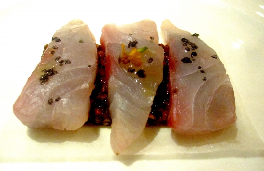 Galleria fotograficaSpugne di pane aromatizzate
Dopo il consueto pre-appetizer delle verdure disidratate (primo contenitore), arrivano le spugne, seconda parentesi colorata che rallegra il pasto dall&rsquo;inizio. In questo caso sono aromatizzate agli spinaci e uova di salmone; alla cipolla cotta al forno con terrina di vitello e alla curcuma con lardo. &laquo;Ma le combinazioni possono essere infinite&raquo;, spiega Matteo Baronetto, braccio destro di Carlo Cracco, &laquo;si possono utilizzare anche in pasticceria al cocco, ai lamponi&hellip; La tecnica &egrave; mutuata da Ferran Adri&agrave;. Abbiamo cercato di personalizzarla nel gusto. A me ricordano molto i canap&egrave; della tradizione piemontese. Senza maionese naturalmente&raquo;. Vivacit&agrave; cromatica ulteriormente ravvivata da un terzo contenitore di foglie di shiso e fiori di zucchina in tempura con riso venere e riso ai piselli fritto (che non vedete perch&eacute;, ahinoi, la foto &egrave; venuta male)Lamponi e sambuco
Nella girandola di appetizer spiccano questi piccoli lamponi farciti con infusione di sambuco serviti sul ghiaccio. &laquo;I suoi fiori in questi giorni li senti anche a Milano, passeggiando al parco. Un odore forte e piacevole. Stiamo lavorando allo stesso concetto anche con le fragole, i mirtilli, il ribes o i gelsi. Un'idea che interpreta quella tradizione sudamericana che ribalta l'ordine delle pietanze, con la frutta all'inizio del percorso, un po' come gi&agrave; succede con la nostra insalata russa caramellata. Sposa nota fruttate e speziate. Ma al posto della frutta potrebbe starci benissimo un'oliva, perch&eacute; no?&raquo;Panino al seitan con insalata e tartufo nero
Un panino di seitan dal contenuto variabile: al congresso di Identit&agrave; Milano 2012, sede della sua anteprima, c&rsquo;erano songino, fiori di piselli e lingua. &laquo;Sono masse di seitan da 15 grammi messe a cuocere nel micro-onde a 90 watt. Il calore fa lievitare il glutine tipo quasi alla maniera del vetro soffiato. L&rsquo;ispirazione ci &egrave; venuta da una ricetta di Simone Salvini letta sul sito di Identit&agrave; Golose&raquo;. A Milano la lingua cancell&ograve; l&rsquo;apparente connotazione vegana del piattoOstriche, crema di piselli e menta
&laquo;Ostriche con semplice crema leggera di latte e piselli messa nel sifone. Combina lo iodato dell&rsquo;ostrica, la dolcezza dei piselli e la freschezza dei menta. La puoi aggiungere anche sui tartufi di mare&raquo;Uovo di quaglia affumicato al rosmarino e prezzemolo bollito
&laquo;L&rsquo;uovo di quaglia viene bollito e pelato. Il tuorlo &egrave; laccato con gelatina di latte ai capperi. Le due met&agrave; dell&rsquo;albume sono arricchite con crema leggera di prezzemolo bollito. C&rsquo;&egrave; una nota affumicata al rosmarino, che gli diamo prima di farcire. &Egrave; un piatto che ricorda un po&rsquo; le uova sode ripiene&raquo;. Giusto il ricordoFoglie di shiso rosse e verdi con gambero e melassa di cipolla
&laquo;Un gambero (ligure, e quindi pi&ugrave; piccolo di quelli pescati in Sicilia) viene posto tra due foglie di shiso a carpaccio, tagliato e tenuto in frigo per 8 ore in modo che gli elementi si compenetrino d&rsquo;aromi l&rsquo;un l&rsquo;altro. La melassa &egrave; ottenuta invece stracuocendo in forno la cipolla, che si addenser&agrave; sfruttando i suoi zuccheri naturali. Completa l&rsquo;opera il nero hawaiano, un sale minerale, vulcanico. E un tocco di burro fuso per aiutare la balsamicit&agrave; dello shiso a esprimersi&raquo;