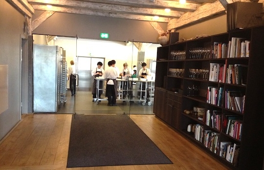 Galleria fotografica






In cammino verso il Noma. Il ristorante è al piano terra del palazzone più a sinistra. Per arrivarci dalla popolare insenatura di Nyhavn (il punto da cui è scattata la foto), occorre fare un bel giro. Ma si notano i lavori per la costruzione di un ponte. Che condurrà dritto all'insegna








Altra prospettiva sul Noma da Nyhavn. Il ristorante galleggia sulla Christianshavn, una delle tante isole artificiali che compongono Copenhagen








Di là del fiume, sulla lunga via che conduce allo spiazzo del Noma








Uno scenario molto tranquillo, di case pastello. Il silenzio è perché vanno tutti in bici













Al massimo si sente rombare qualche scafo








Il vascello davanti al Noma. Oltre a quella danese, sventolano le bandiere di Isole Far Oer e Groenlandia: le loro ambasciate sono nello stesso palazzo del ristorante. Coerenza nordica








Il retro del ristorante. L'80% delle 80 persone che lavorano al Noma viene a lavorare in bici, chef incluso








Dietro al ristorante, un'iscrizione ricorda i passeggeri scomparsi a bordo della danese Hans Hedtoft. Il transatlantico si scontrò il 30 gennaio 1959 contrò un iceberg in Groenlandia. Fu ritrovata solo una cintura di sicurezza
 








L'ingresso del ristorante, al civico 93 di Strandgade








La vista, ingresso alle spalle








Tra l'ingresso e la cucina a vista, spicca un corner di decoro simil-giapponese. A sinistra s'intravede Noma, time and place in Nordic Cuisine, edizioni Phaidon, un testo fondamentale per approfondire tutti i rivoli del Redzepi-mondo. La versione italiana si ordina qui








Una pianta di piccoli agrumi orla la cucina a vista








La porta d'ingresso vista dalla cucina








Le sedie, molto comode, sono anni Sessanta con schienali foderati di pelle di pecora, alcune più morbide di altre








I tavoli sono ampi e senza tovaglie. Attorno prevale il grigio e i colori rustici, sulle travi in legno del soffitto ma anche sulle divise dei ragazzi di sala








La finestra accanto al nostro tavolo








E' lo chef Rene Redzepi a introdurci al pasto: in un vaso di fiori danesi, l'unico pendaglio commestibile è una sorta di carta musica croccante (flatbread) di farina di malto all'aroma di ginepro. Nel piattino in basso, una deliziosa crème fraîche acida per intingerlo








Il flatbread è quello che svetta. "Ma se ci tenete, provate a mangiare anche i fiori", scherza Redzepi. Il cuoco scompare nelle segrete del Noma. Lo ritroveremo solo alla fine del pasto








Tutti i 14 appetizer si mangeranno con le mani. Unica posata, il coltello per tirar su e leccare la crème fraîche da sola (da fare quando tutti gli altri clienti son distratti, però)








Moss and Cep: Muschio di renna con polvere di funghi porcini. E' il corpo bianco, molto saporito ed evanescente, da intingere anch'esso nella crème fraîche
 








Crispy pork skin and black currant: Pelle di maiale croccante e ribes nero, lo strato più esterno. Aspro e croccante








Il ribes nero non ci lascerà prima di molto tempo








Blue mussels and celery: cozze e sedano. Solo due sono quelle buone








La parte inferiore del guscio è commestibile (ancora farina di malto)








Il quinto appetizer è nascosto in una deliziosa scatola di biscotti in latta della tradizione danese (chi non ricorda i Danish butter cookies?)








Cinque tondini, ma solo due "interessanti"








Si chiamano Cheese cookies, rocket and stems, letteralmente Biscotti al formaggio, ruchetta e gambi di erbe aromatiche, un felice snack potenzialmente riproducibile nei nord e nei sud del mondo








Appetizer #6: Potato and duck liver, Patate e fegato d'anatra: le patate croccanti sono in due strati e a mo' di sandwich racchiudono la mousse di fegato. La spolverata è di funghi trombette dei morti, disidratati e polverizzati, una tecnica che troveremo frequentemente








Dried carrot and sorrel, Carote grigliate a fuoco lento per 14 ore, disidratate e servite su polvere di fieno. Si intingono nell'emulsione di acetosella accanto. Un grande piatto perché di inattesa, energica acidità








Ottava entrée: Caramelized milk and cod liver, Biscotto di latte caramellato e fegato di merluzzo, quest'ultimo ghiacciato e pulito. Il secondo dona un aroma molto strong, che domina sul biscotto croccante. Per palati muscolari








Le uova dentro l'uovo








Pickled and smoked quails eggs, Uova di quaglia sbollentate, marinate e affumicate, un classico del Noma. Il tuorlo è completamente liquido








Col Veal fibres and söl, Filamenti di vitello e söl, decimo appetizer, entra in gioco per la prima volta un'alga di mare. E' il söl, appunto, dulse in inglese, Palmaria palmata nella tassonomia scientifica, un'alga rossa incastrata nei filamenti di vitello precedentemente tagliati sottili e poi fritti. Curioso l'impiatto a nido di ingredienti che alla fine incastrano terra e mare








Herb Toast and smoked cod roe, Toast alle erbe e uova di merluzzo affumicato, un'altra grandiosa tapa nordica da far su in due bocconi. Se non ricordiamo male, lo strato superiore è brodo di fegato d'anatra disidratato








Radish, soil and grass, Rapanello, "suolo" ed erba, un altro grande classico del Noma, un paesaggio commestibile di chiara genesi basca-adrianesca, molto replicato negli anni. Carote baby e rapanelli sono interrati in un "suolo" che è una crema di farina di malto con nocciole disidratate. Sotto ancora, uno yogurt di erbe. Finite le verdure, abbiamo chiesto dei cucchiaini per ripulire il suolo








Una foto (di spreadbutter) chiarisce meglio il contenuto del vasetto








Æbleskiver e muikku, penultimo appetizer, di concezione piuttosto recente. Un'antica tradizione dolce danese (Æbleskiver significa "piccoli pezzi di mela" ma la mela qui non c'è) è presentata in versione salata. Code e teste dei muikku, sorta di aringhe baby, sono infilzate in due bigné dall'impasto molto morbido con del ripieno di cetriolo marinato, ben riconoscibile al palato. L'aspetto dispone il cliente alla sfida ma la sua bizzarria visiva si scioglie presto in due bocconi morbidi, eleganti e deliziosi








Ultimo di 14 appetizer: Sorrel leaf and cricket paste, Foglia di acetosella (leggermente piccante) con pasta di grillo. Sì, proprio l'insetto dei prati, qui in consistenza di crema, inserita nel gambo dell'acetosella. Mettendo a fermentare grilli e orzo fermentato, Redzepi ha ottenuto una sorta di garum molto interessante, simile alla soia. Completa il piatto in foto, una granita di nasturzio ghiacciato








E il vino? Non producendo la Danimarca nettari di rilievo, è forse il capitolo meno allettante del Noma. La carta è un trionfo di vini ottenuti in climi freddi: francesi, tedeschi o austriaci soprattutto. Vini di acidità spinta che si combinano bene con le prevalenti acidità dei piatti. Le persone inquadrate nella foto hanno optato per il pairing coi succhi di frutta, quelli sì interessanti e autoctoni: il percorso prevede 7-8 succhi tra cui carote e ginepro, sedano e sedanorapa, cetriolo, eccetera. E i vini italiani? Pochi e tutti rossi, soprattutto di produttori di nebbiolo del Piemonte. "Ma li chiedono solo i norvegesi", ci raccontano








Terminati appetizer e main courses, sbirciamo i lavori in cucina. In primo piano, Samuel Nutter, sous chef inglese








Al centro, riconosciamo Matthew Orlando di San Diego, 35 anni e da 4 e mezzo head chef del Noma. Più tardi ci rivelerà che entro un paio d'anni aprirà il suo ristorante a Copenhagen. "E Renè che ne pensa?", chiediamo. "E' proprio lui a incoraggiarci a metterci in proprio", risponde Orlando. Vero, chiedere anche a Christian Puglisi








Ancora Orlando ci spiegherà che, tra sala, cucina, preparazioni e laboratorio, il Noma arriva a impiegare dall'alba a mezzanotte fino a 80 persone








La cucina prevede 7 comparti: il caldo, il freddo, la pasticceria, gli snack, produzione e mise-en-place, le preparazioni della squadra del mattino e la ricerca (su quest'ultima torneremo più avanti). Gli stagisti scelgono di lavorarci, sapendo di non essere pagati. Redzepi riceve un centinaio di curricula a settimana








Torniamo a tavola e troviamo nuove posate: rami appuntiti di sambuco








Servono a infilzare il primo delle portate "serie", Potato and snails, patate e lumache, servito in due piatti. Il primo è una terrina (rovente) di piccole deliziose patate affumicate e semiaffogate in una salsa al burro dolce e al tavolo spolverate con sale proprio di sambuco. Accanto, piccoli ceppi d'albero affumicati








Accanto, l'altra metà del piatto da infilzare coi bastoncini di sambuco: lumache glassate nel loro succo con burro dolce, olio al prezzemolo ed emulsione di piselli fermentati








Dopo 15 portate arrivano le posate. "Si torna alla civiltà", scherza il ragazzo di sala








...e arriva pure il pane, nascosto in una stoffa soffice con accanto due ciotoline che contengono burro da latte di capra e burro di grasso e crumble di maiale. Colesterolemici, vade retro








Solleviamo la stoffa: il pane è una pagnotta di lievito naturale di grano locale. La crosta è super-fragrante e il cuore molto sofficie e poroso








Cooked fava beans and beach herbs, Fave stufate gentilmente ed "erbe di spiaggia" (che poi sono diversi tipi di alghe di mare). Le fave sono fantastiche nella loro compattezza inaspettatamente dolce








Con la terza portata del ciclo "serio" veniamo ai ragazzi di sala: sono tutti molto professionali ma anche rilassati. Tra i 30 e i 40 anni, molti tatuati, ruotano di continuo al nostro tavolo: una trentina dei piatti sono stati serviti e illustrati da 10 camerieri diversi, molti dei quali cuochi dei livelli più alti della gerarchia. Il ragazzo in foto che ci serve Berries and cucumber, Bacche e cetrioli, si chiama Beau Clugston, è australiano e da poche ore è un nuovo sous-chef del Noma








Ai frutti di bosco e insalata di cetrioli si unisce del succo di camomilla...








...et voilà








Insalata di brown crab (granchi atlantici), tuorlo d'uovo, erbe di campo e il rosso sono le uova del granchio. I ragazzi si raccomandano di fare attenzione perchè potrebbe esserci del carapace o delle chele: la carne del granchio è stata rimossa tutta a mano. Noi ci scontriamo solo con un fresco schiaffo iodato








Accanto alle langoustine, scampi norvegesi, torna l'alga söl, questa volta in forma di emulsione con acqua di ostriche. I puntini rossi sono segale disidratata








Cavolfiore e pino, crema e rafano. Pensi a una capasanta e invece è un trancio di cavolfiore quello che spunta da sotto gli aghi di pino. E' ricavato dalla parte alta dell'ortaggio, arrostito a arricchito con gli aromi di pino, abete, ginepro e rafano. L'orto e il silvestre








Lucioperca con gambi di verdure. Impeccabile ma insolitamente classico nella sua concezione su salsa al burro e capperi. Incuriosisce la disposizione, che lascia intonsa più di metà del piatto. Come a voler lasciar libero il lucioperca di sguazzare di nuovo








Arrivano in tavola nuovi oggetti: olio di fieno e un cronometro. E' l'inizio del gioco di The hen and the egg, La gallina e l'uovo








The hen and the egg #2: attorno a un tegamino rovente su del fieno appena umido, notiamo una chips a spirale di patata e un uovo (d'anatra, ci dicono)








The hen and the egg #3: accanto al tegame, foglie di spinaci, aglio selvatico, germogli e fiori di campo vari








The hen and the egg #4. "Dovete rompere voi l'uovo e cuocerlo", ci spiegano armati di olio di fieno, che spruzzeranno nel tegame prima del nostro esercizio








The hen and the egg #5: son riuscito a non sbrodolare. Il piatto, spiegherà Redzepi poi, "E' un po' un invito sdrammatizzante a cucinare. Sono rimasto sorpreso dal fatto che tanti clienti non hanno mai rotto un uovo. Cerco di mostrare loro che la cucina è in fondo un esercizio molto elementare"








The hen and the egg #6: dopo 120 secondi esatti di cronometro, si uniscono all'uovo le verdure e si rimesta il tutto








The hen and the egg #7: tocco finale, una salsa di acetosella. Il piatto non è memorabile...








...ma il risultato è lo stesso delle 21 portate precedenti: piatto spazzolato The hen and the egg #8








Animelle di vitello, erbe di campo, funghi e sedanorapa. Un gran piatto, ma non esattamente quello che ti aspetti al Noma. Sottigliezze eh








A un passo dai dolci, il brusio in sala si fa più sostenuto. L'alcol e le discussioni sull'incredibile girandola di piatti provati








E il brusio lievita ancora al primo dei due dolci: Blueberries and ants, Mirtilli e formiche (la foto è di garyalanfine, avevo terminato le batterie). Il piatto è duplice: la foto mostra la prima metà, che racchiude una confettura di formiche tra due foglie di nasturzio. Ce la porta al tavolo Rosio Sanchez da Chicago, splendida coordinatrice dei dessert del Noma. E le formiche? Ci torniamo alla fine della gallery








Mirtilli e formiche parte seconda: accanto alle foglie di nasturzio con formiche, arriva un geniale sandwich con gelato di mirtilli (la foto è ancora di garyalanfine)








Ventiquattresimo e ultimo piatto, un "classico" Gammel Dansk, sorta di Jaegermeister danese qui sposato ad acetosella e latte disidratato. Apprezziamo la voglia di non sovraccaricare con ulteriori bombe al cioccolato o altre grasse cremosità che a fine pasto chiederebbero gli straordinari ai succhi gastrici (grazie ancora a garyalanfine)








Dopo oltre 3 ore di degustazione, ci si accomoda tutti nel dehors accanto: in vetrina spiccano grappe di Brunello








Potevano farti mancare lo skyr, il formaggio fermentato acido degli islandesi? Certo che no: agli albori della New Nordic Cuisine venne praticamente brandito da Redzepi come simbolo delle rivoluzione. L'arma per contrastare il dilagare dei formaggi francesi in Danimarca, così come l'olio di colza in vece dell'olio d'oliva








Riordinata la sala per la sera, Kim Sander e Matthew Orlando ci invitano a fare un sopralluogo nei back office del Noma








I ragazzi si divertono ma il lavoro è un massacro: tra il pranzo e la cena ci sono solo 45 minuti di pausa, dalle 17 alle 17.45. "Per questo", spiega Redzepi, "è fondamentale tenere chiuso due giorni, domenica e lunedì. Così stacchiamo da ogni pensiero. 7 su 7 sarebbe controproducente per l'umore di tutti"








Orlando ci mostra il gazebo all'aperto sul retro, dove si griglia e affumica qualsiasi cosa








Al primo piano, un tavolo da 9-15 persone che si aggiunge ai coperti del piano terra. "E' il nostro table's chef' , dice Orlando








Alle pareti, una felice riproduzione caricaturale della cucina di sotto





