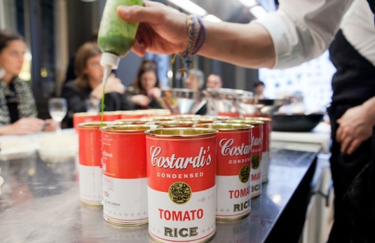 Galleria fotograficaCoda fuori dallo showroom Agape, via Statuto 12, per il piatto di Andrea BertonIl piatto di Berton:&nbsp;Focaccia di Recco con controfiletto di manzo crudo e composta di pomodoro piccanteAndrea BertonArclinea, corso Monforte 28: si preparano i fratelli&nbsp;Christian e Manuel Costardi, cuochi del ristorante Cinzia di VercelliL'imbuto di metallo per infilare il risotto nel barattolo warholiano. Alle spalle di Christian Costardi, Giulia Corradetti di Magenta Bureau