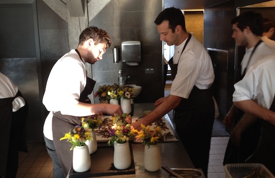 Galleria fotografica






In cammino verso il Noma. Il ristorante è al piano terra del palazzone più a sinistra. Per arrivarci dalla popolare insenatura di Nyhavn (il punto da cui è scattata la foto), occorre fare un bel giro. Ma si notano i lavori per la costruzione di un ponte. Che condurrà dritto all'insegna








Altra prospettiva sul Noma da Nyhavn. Il ristorante galleggia sulla Christianshavn, una delle tante isole artificiali che compongono Copenhagen








Di là del fiume, sulla lunga via che conduce allo spiazzo del Noma








Uno scenario molto tranquillo, di case pastello. Il silenzio è perché vanno tutti in bici













Al massimo si sente rombare qualche scafo








Il vascello davanti al Noma. Oltre a quella danese, sventolano le bandiere di Isole Far Oer e Groenlandia: le loro ambasciate sono nello stesso palazzo del ristorante. Coerenza nordica








Il retro del ristorante. L'80% delle 80 persone che lavorano al Noma viene a lavorare in bici, chef incluso








Dietro al ristorante, un'iscrizione ricorda i passeggeri scomparsi a bordo della danese Hans Hedtoft. Il transatlantico si scontrò il 30 gennaio 1959 contrò un iceberg in Groenlandia. Fu ritrovata solo una cintura di sicurezza
 








L'ingresso del ristorante, al civico 93 di Strandgade








La vista, ingresso alle spalle








Tra l'ingresso e la cucina a vista, spicca un corner di decoro simil-giapponese. A sinistra s'intravede Noma, time and place in Nordic Cuisine, edizioni Phaidon, un testo fondamentale per approfondire tutti i rivoli del Redzepi-mondo. La versione italiana si ordina qui








Una pianta di piccoli agrumi orla la cucina a vista








La porta d'ingresso vista dalla cucina








Le sedie, molto comode, sono anni Sessanta con schienali foderati di pelle di pecora, alcune più morbide di altre








I tavoli sono ampi e senza tovaglie. Attorno prevale il grigio e i colori rustici, sulle travi in legno del soffitto ma anche sulle divise dei ragazzi di sala








La finestra accanto al nostro tavolo








E' lo chef Rene Redzepi a introdurci al pasto: in un vaso di fiori danesi, l'unico pendaglio commestibile è una sorta di carta musica croccante (flatbread) di farina di malto all'aroma di ginepro. Nel piattino in basso, una deliziosa crème fraîche acida per intingerlo








Il flatbread è quello che svetta. "Ma se ci tenete, provate a mangiare anche i fiori", scherza Redzepi. Il cuoco scompare nelle segrete del Noma. Lo ritroveremo solo alla fine del pasto








Tutti i 14 appetizer si mangeranno con le mani. Unica posata, il coltello per tirar su e leccare la crème fraîche da sola (da fare quando tutti gli altri clienti son distratti, però)








Moss and Cep: Muschio di renna con polvere di funghi porcini. E' il corpo bianco, molto saporito ed evanescente, da intingere anch'esso nella crème fraîche
 








Crispy pork skin and black currant: Pelle di maiale croccante e ribes nero, lo strato più esterno. Aspro e croccante








Il ribes nero non ci lascerà prima di molto tempo








Blue mussels and celery: cozze e sedano. Solo due sono quelle buone








La parte inferiore del guscio è commestibile (ancora farina di malto)








Il quinto appetizer è nascosto in una deliziosa scatola di biscotti in latta della tradizione danese (chi non ricorda i Danish butter cookies?)








Cinque tondini, ma solo due "interessanti"








Si chiamano Cheese cookies, rocket and stems, letteralmente Biscotti al formaggio, ruchetta e gambi di erbe aromatiche, un felice snack potenzialmente riproducibile nei nord e nei sud del mondo








Appetizer #6: Potato and duck liver, Patate e fegato d'anatra: le patate croccanti sono in due strati e a mo' di sandwich racchiudono la mousse di fegato. La spolverata è di funghi trombette dei morti, disidratati e polverizzati, una tecnica che troveremo frequentemente








Dried carrot and sorrel, Carote grigliate a fuoco lento per 14 ore, disidratate e servite su polvere di fieno. Si intingono nell'emulsione di acetosella accanto. Un grande piatto perché di inattesa, energica acidità








Ottava entrée: Caramelized milk and cod liver, Biscotto di latte caramellato e fegato di merluzzo, quest'ultimo ghiacciato e pulito. Il secondo dona un aroma molto strong, che domina sul biscotto croccante. Per palati muscolari








Le uova dentro l'uovo








Pickled and smoked quails eggs, Uova di quaglia sbollentate, marinate e affumicate, un classico del Noma. Il tuorlo è completamente liquido








Col Veal fibres and söl, Filamenti di vitello e söl, decimo appetizer, entra in gioco per la prima volta un'alga di mare. E' il söl, appunto, dulse in inglese, Palmaria palmata nella tassonomia scientifica, un'alga rossa incastrata nei filamenti di vitello precedentemente tagliati sottili e poi fritti. Curioso l'impiatto a nido di ingredienti che alla fine incastrano terra e mare








Herb Toast and smoked cod roe, Toast alle erbe e uova di merluzzo affumicato, un'altra grandiosa tapa nordica da far su in due bocconi. Se non ricordiamo male, lo strato superiore è brodo di fegato d'anatra disidratato








Radish, soil and grass, Rapanello, "suolo" ed erba, un altro grande classico del Noma, un paesaggio commestibile di chiara genesi basca-adrianesca, molto replicato negli anni. Carote baby e rapanelli sono interrati in un "suolo" che è una crema di farina di malto con nocciole disidratate. Sotto ancora, uno yogurt di erbe. Finite le verdure, abbiamo chiesto dei cucchiaini per ripulire il suolo








Una foto (di spreadbutter) chiarisce meglio il contenuto del vasetto








Æbleskiver e muikku, penultimo appetizer, di concezione piuttosto recente. Un'antica tradizione dolce danese (Æbleskiver significa "piccoli pezzi di mela" ma la mela qui non c'è) è presentata in versione salata. Code e teste dei muikku, sorta di aringhe baby, sono infilzate in due bigné dall'impasto molto morbido con del ripieno di cetriolo marinato, ben riconoscibile al palato. L'aspetto dispone il cliente alla sfida ma la sua bizzarria visiva si scioglie presto in due bocconi morbidi, eleganti e deliziosi








Ultimo di 14 appetizer: Sorrel leaf and cricket paste, Foglia di acetosella (leggermente piccante) con pasta di grillo. Sì, proprio l'insetto dei prati, qui in consistenza di crema, inserita nel gambo dell'acetosella. Mettendo a fermentare grilli e orzo fermentato, Redzepi ha ottenuto una sorta di garum molto interessante, simile alla soia. Completa il piatto in foto, una granita di nasturzio ghiacciato








E il vino? Non producendo la Danimarca nettari di rilievo, è forse il capitolo meno allettante del Noma. La carta è un trionfo di vini ottenuti in climi freddi: francesi, tedeschi o austriaci soprattutto. Vini di acidità spinta che si combinano bene con le prevalenti acidità dei piatti. Le persone inquadrate nella foto hanno optato per il pairing coi succhi di frutta, quelli sì interessanti e autoctoni: il percorso prevede 7-8 succhi tra cui carote e ginepro, sedano e sedanorapa, cetriolo, eccetera. E i vini italiani? Pochi e tutti rossi, soprattutto di produttori di nebbiolo del Piemonte. "Ma li chiedono solo i norvegesi", ci raccontano








Terminati appetizer e main courses, sbirciamo i lavori in cucina. In primo piano, Samuel Nutter, sous chef inglese








Al centro, riconosciamo Matthew Orlando di San Diego, 35 anni e da 4 e mezzo head chef del Noma. Più tardi ci rivelerà che entro un paio d'anni aprirà il suo ristorante a Copenhagen. "E Renè che ne pensa?", chiediamo. "E' proprio lui a incoraggiarci a metterci in proprio", risponde Orlando. Vero, chiedere anche a Christian Puglisi








Ancora Orlando ci spiegherà che, tra sala, cucina, preparazioni e laboratorio, il Noma arriva a impiegare dall'alba a mezzanotte fino a 80 persone








La cucina prevede 7 comparti: il caldo, il freddo, la pasticceria, gli snack, produzione e mise-en-place, le preparazioni della squadra del mattino e la ricerca (su quest'ultima torneremo più avanti). Gli stagisti scelgono di lavorarci, sapendo di non essere pagati. Redzepi riceve un centinaio di curricula a settimana








Torniamo a tavola e troviamo nuove posate: rami appuntiti di sambuco








Servono a infilzare il primo delle portate "serie", Potato and snails, patate e lumache, servito in due piatti. Il primo è una terrina (rovente) di piccole deliziose patate affumicate e semiaffogate in una salsa al burro dolce e al tavolo spolverate con sale proprio di sambuco. Accanto, piccoli ceppi d'albero affumicati








Accanto, l'altra metà del piatto da infilzare coi bastoncini di sambuco: lumache glassate nel loro succo con burro dolce, olio al prezzemolo ed emulsione di piselli fermentati








Dopo 15 portate arrivano le posate. "Si torna alla civiltà", scherza il ragazzo di sala








...e arriva pure il pane, nascosto in una stoffa soffice con accanto due ciotoline che contengono burro da latte di capra e burro di grasso e crumble di maiale. Colesterolemici, vade retro








Solleviamo la stoffa: il pane è una pagnotta di lievito naturale di grano locale. La crosta è super-fragrante e il cuore molto sofficie e poroso








Cooked fava beans and beach herbs, Fave stufate gentilmente ed "erbe di spiaggia" (che poi sono diversi tipi di alghe di mare). Le fave sono fantastiche nella loro compattezza inaspettatamente dolce








Con la terza portata del ciclo "serio" veniamo ai ragazzi di sala: sono tutti molto professionali ma anche rilassati. Tra i 30 e i 40 anni, molti tatuati, ruotano di continuo al nostro tavolo: una trentina dei piatti sono stati serviti e illustrati da 10 camerieri diversi, molti dei quali cuochi dei livelli più alti della gerarchia. Il ragazzo in foto che ci serve Berries and cucumber, Bacche e cetrioli, si chiama Beau Clugston, è australiano e da poche ore è un nuovo sous-chef del Noma








Ai frutti di bosco e insalata di cetrioli si unisce del succo di camomilla...








...et voilà








Insalata di brown crab (granchi atlantici), tuorlo d'uovo, erbe di campo e il rosso sono le uova del granchio. I ragazzi si raccomandano di fare attenzione perchè potrebbe esserci del carapace o delle chele: la carne del granchio è stata rimossa tutta a mano. Noi ci scontriamo solo con un fresco schiaffo iodato








Accanto alle langoustine, scampi norvegesi, torna l'alga söl, questa volta in forma di emulsione con acqua di ostriche. I puntini rossi sono segale disidratata








Cavolfiore e pino, crema e rafano. Pensi a una capasanta e invece è un trancio di cavolfiore quello che spunta da sotto gli aghi di pino. E' ricavato dalla parte alta dell'ortaggio, arrostito a arricchito con gli aromi di pino, abete, ginepro e rafano. L'orto e il silvestre








Lucioperca con gambi di verdure. Impeccabile ma insolitamente classico nella sua concezione su salsa al burro e capperi. Incuriosisce la disposizione, che lascia intonsa più di metà del piatto. Come a voler lasciar libero il lucioperca di sguazzare di nuovo








Arrivano in tavola nuovi oggetti: olio di fieno e un cronometro. E' l'inizio del gioco di The hen and the egg, La gallina e l'uovo








The hen and the egg #2: attorno a un tegamino rovente su del fieno appena umido, notiamo una chips a spirale di patata e un uovo (d'anatra, ci dicono)








The hen and the egg #3: accanto al tegame, foglie di spinaci, aglio selvatico, germogli e fiori di campo vari








The hen and the egg #4. "Dovete rompere voi l'uovo e cuocerlo", ci spiegano armati di olio di fieno, che spruzzeranno nel tegame prima del nostro esercizio








The hen and the egg #5: son riuscito a non sbrodolare. Il piatto, spiegherà Redzepi poi, "E' un po' un invito sdrammatizzante a cucinare. Sono rimasto sorpreso dal fatto che tanti clienti non hanno mai rotto un uovo. Cerco di mostrare loro che la cucina è in fondo un esercizio molto elementare"








The hen and the egg #6: dopo 120 secondi esatti di cronometro, si uniscono all'uovo le verdure e si rimesta il tutto








The hen and the egg #7: tocco finale, una salsa di acetosella. Il piatto non è memorabile...








...ma il risultato è lo stesso delle 21 portate precedenti: piatto spazzolato The hen and the egg #8








Animelle di vitello, erbe di campo, funghi e sedanorapa. Un gran piatto, ma non esattamente quello che ti aspetti al Noma. Sottigliezze eh








A un passo dai dolci, il brusio in sala si fa più sostenuto. L'alcol e le discussioni sull'incredibile girandola di piatti provati








E il brusio lievita ancora al primo dei due dolci: Blueberries and ants, Mirtilli e formiche (la foto è di garyalanfine, avevo terminato le batterie). Il piatto è duplice: la foto mostra la prima metà, che racchiude una confettura di formiche tra due foglie di nasturzio. Ce la porta al tavolo Rosio Sanchez da Chicago, splendida coordinatrice dei dessert del Noma. E le formiche? Ci torniamo alla fine della gallery








Mirtilli e formiche parte seconda: accanto alle foglie di nasturzio con formiche, arriva un geniale sandwich con gelato di mirtilli (la foto è ancora di garyalanfine)








Ventiquattresimo e ultimo piatto, un "classico" Gammel Dansk, sorta di Jaegermeister danese qui sposato ad acetosella e latte disidratato. Apprezziamo la voglia di non sovraccaricare con ulteriori bombe al cioccolato o altre grasse cremosità che a fine pasto chiederebbero gli straordinari ai succhi gastrici (grazie ancora a garyalanfine)








Dopo oltre 3 ore di degustazione, ci si accomoda tutti nel dehors accanto: in vetrina spiccano grappe di Brunello








Potevano farti mancare lo skyr, il formaggio fermentato acido degli islandesi? Certo che no: agli albori della New Nordic Cuisine venne praticamente brandito da Redzepi come simbolo delle rivoluzione. L'arma per contrastare il dilagare dei formaggi francesi in Danimarca, così come l'olio di colza in vece dell'olio d'oliva








Riordinata la sala per la sera, Kim Sander e Matthew Orlando ci invitano a fare un sopralluogo nei back office del Noma








I ragazzi si divertono ma il lavoro è un massacro: tra il pranzo e la cena ci sono solo 45 minuti di pausa, dalle 17 alle 17.45. "Per questo", spiega Redzepi, "è fondamentale tenere chiuso due giorni, domenica e lunedì. Così stacchiamo da ogni pensiero. 7 su 7 sarebbe controproducente per l'umore di tutti"








Orlando ci mostra il gazebo all'aperto sul retro, dove si griglia e affumica qualsiasi cosa








Al primo piano, un tavolo da 9-15 persone che si aggiunge ai coperti del piano terra. "E' il nostro table's chef' , dice Orlando








Alle pareti, una felice riproduzione caricaturale della cucina di sotto








Nella sala accanto, uno squadrone di giovanissimi è perennemente alle prese con le pre-preparazioni








Tagliare, separare, sgusciare, sminuzzare...








Il terzo ambiente al primo piano è la sala del relax dei ragazzi...








...ma anche quella del grande capo...








...che infatti troviamo defilato ad affettare un mega-cavolo...








...che cavolo non è: "E' un fungo", rivela Renè Redzepi, "un regno che mi affascina tantissimo perché è vasto così", dice disegnando un cerchio molto ampio con le braccia, "mentre noi ne sappiamo tanto così", mima chiudendo pollice e indice. "Purtroppo questa stagione non è propizia per i funghi, troppo secca, ma non dispero"








Ma parliamo di formiche. Redzepì tira fuori un tupperwear brulicante di insetti che vagano rintontiti. "Non è questione di stravaganza o sensazionalismo", spiega, "occorre solo infrangere i nostri tabù, non come esercizio fine a se stesso, ma come esplorazione di tutti i flavour possibili"








"Senti che effluvi naturali di cardamomo escono da qui? Le formiche li rilasciano in modo del tutto naturale per tenere lontani i nemici", spiega








La sera stessa ci scrive su twitter la giornalista spagnola Julia Perez da Lima, spiegando che gli insetti amazzoni che cucina il cuoco venezuelano Sumito Estévez sanno invece di limone
 








"Un giorno, quando avrò tempo, spero non tra 10 anni, voglio trovare il modo di andare a visitare i più grandi macellai italiani". Un messaggio da girare subito a Cazzamali & co.








Formiche again, questa volta col petto rosso. La mirmecologia classifica nel mondo oltre 10mila specie di formiche, ognuna con il suo bagaglio aromatico





