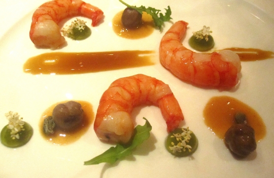 Galleria fotograficaSpugne di pane aromatizzate
Dopo il consueto pre-appetizer delle verdure disidratate (primo contenitore), arrivano le spugne, seconda parentesi colorata che rallegra il pasto dall&rsquo;inizio. In questo caso sono aromatizzate agli spinaci e uova di salmone; alla cipolla cotta al forno con terrina di vitello e alla curcuma con lardo. &laquo;Ma le combinazioni possono essere infinite&raquo;, spiega Matteo Baronetto, braccio destro di Carlo Cracco, &laquo;si possono utilizzare anche in pasticceria al cocco, ai lamponi&hellip; La tecnica &egrave; mutuata da Ferran Adri&agrave;. Abbiamo cercato di personalizzarla nel gusto. A me ricordano molto i canap&egrave; della tradizione piemontese. Senza maionese naturalmente&raquo;. Vivacit&agrave; cromatica ulteriormente ravvivata da un terzo contenitore di foglie di shiso e fiori di zucchina in tempura con riso venere e riso ai piselli fritto (che non vedete perch&eacute;, ahinoi, la foto &egrave; venuta male)Lamponi e sambuco
Nella girandola di appetizer spiccano questi piccoli lamponi farciti con infusione di sambuco serviti sul ghiaccio. &laquo;I suoi fiori in questi giorni li senti anche a Milano, passeggiando al parco. Un odore forte e piacevole. Stiamo lavorando allo stesso concetto anche con le fragole, i mirtilli, il ribes o i gelsi. Un'idea che interpreta quella tradizione sudamericana che ribalta l'ordine delle pietanze, con la frutta all'inizio del percorso, un po' come gi&agrave; succede con la nostra insalata russa caramellata. Sposa nota fruttate e speziate. Ma al posto della frutta potrebbe starci benissimo un'oliva, perch&eacute; no?&raquo;Panino al seitan con insalata e tartufo nero
Un panino di seitan dal contenuto variabile: al congresso di Identit&agrave; Milano 2012, sede della sua anteprima, c&rsquo;erano songino, fiori di piselli e lingua. &laquo;Sono masse di seitan da 15 grammi messe a cuocere nel micro-onde a 90 watt. Il calore fa lievitare il glutine tipo quasi alla maniera del vetro soffiato. L&rsquo;ispirazione ci &egrave; venuta da una ricetta di Simone Salvini letta sul sito di Identit&agrave; Golose&raquo;. A Milano la lingua cancell&ograve; l&rsquo;apparente connotazione vegana del piattoOstriche, crema di piselli e menta
&laquo;Ostriche con semplice crema leggera di latte e piselli messa nel sifone. Combina lo iodato dell&rsquo;ostrica, la dolcezza dei piselli e la freschezza dei menta. La puoi aggiungere anche sui tartufi di mare&raquo;Uovo di quaglia affumicato al rosmarino e prezzemolo bollito
&laquo;L&rsquo;uovo di quaglia viene bollito e pelato. Il tuorlo &egrave; laccato con gelatina di latte ai capperi. Le due met&agrave; dell&rsquo;albume sono arricchite con crema leggera di prezzemolo bollito. C&rsquo;&egrave; una nota affumicata al rosmarino, che gli diamo prima di farcire. &Egrave; un piatto che ricorda un po&rsquo; le uova sode ripiene&raquo;. Giusto il ricordoFoglie di shiso rosse e verdi con gambero e melassa di cipolla
&laquo;Un gambero (ligure, e quindi pi&ugrave; piccolo di quelli pescati in Sicilia) viene posto tra due foglie di shiso a carpaccio, tagliato e tenuto in frigo per 8 ore in modo che gli elementi si compenetrino d&rsquo;aromi l&rsquo;un l&rsquo;altro. La melassa &egrave; ottenuta invece stracuocendo in forno la cipolla, che si addenser&agrave; sfruttando i suoi zuccheri naturali. Completa l&rsquo;opera il nero hawaiano, un sale minerale, vulcanico. E un tocco di burro fuso per aiutare la balsamicit&agrave; dello shiso a esprimersi&raquo;Orata cotta appena su croccante di nocciole
&laquo;Il croccante viene messo in forno per 3 minuti. Tirato fuori, gli si poggia sopra il sashimi di orata, che 'cuocer&agrave;' cos&igrave; acquisendo la nota dolce dell'olio naturale del croccante&raquo;. Una sorta di sashimi alla piemontese. Vietato mangiare il croccantino sottostante perch&eacute; altrimenti l'orata non si sente. Semmai dopo...Salmone marinato e foie gras
Piatto in carta da Cracco pi&ugrave; o meno da un anno, &egrave; un inno all&rsquo;opulenza e alle note grasse. &laquo;Volevamo dare una variante allo stra-classico salmone col burro spalmato sul crostino&raquo;, spiega Baronetto.&nbsp;Il boccone del salmone senza foie gras deve rimanere per ultimo &laquo;senn&ograve; l&rsquo;avremmo chiamato foie gras e salmone&raquo;