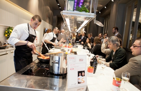 Galleria fotograficaCoda fuori dallo showroom Agape, via Statuto 12, per il piatto di Andrea BertonIl piatto di Berton:&nbsp;Focaccia di Recco con controfiletto di manzo crudo e composta di pomodoro piccanteAndrea BertonArclinea, corso Monforte 28: si preparano i fratelli&nbsp;Christian e Manuel Costardi, cuochi del ristorante Cinzia di VercelliL'imbuto di metallo per infilare il risotto nel barattolo warholiano. Alle spalle di Christian Costardi, Giulia Corradetti di Magenta BureauCostardi&rsquo;s tomato rice (omaggio a Andy Warhol)