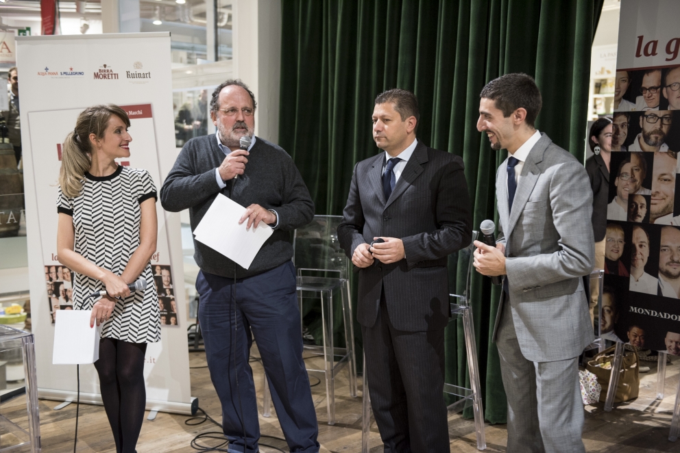 Galleria fotograficaEataly Smeraldo di Milano gremito per la presentazione della guida Identit&agrave; Golose 2015.Sul palco che spesso ospita concerti è di scena questa volta Paolo Marchi, fondatore e curatore della guida. Con lui anche Claudio Ceroni di Magenta Bureau, il braccio operativo di IG.Un'altra immagine, dall'alto......e via all'evento. Claudio Ceroni, al centro, invita sul palco il "padrone di casa" Oscar Farinetti. Coi due anche la presentatrice della serata, Tarsia Trevisan.Poi è la volta di Paolo Marchi, qui con Stefano Peccatori, direttore generale libri di Mondadori Electa, che edita la guida per il secondo anno consecutivo.Partono le premiazioni. Il primo a salire sul palco &egrave; Fabrizio Ferrari, chef de Al Porticciolo 84 di Lecco, a lui va il "Birra in cucina", premio Birra Moretti. Glielo consegna Alfredo Pratolongo, Direzione comunicazione e affari istituzionali di Heineken Italia.Sono tre i premiati, invece, da Ruinart (per mano del senior brand manager, Riccardo Caliceti, sulla destra) per la Migliore carta dei vini e dei distillati: Walter Meccia, Edoardo Boncinelli e Gabriele Fedeli, de Il Palagio, ristorante del Four Seasons di Firenze.&nbsp;Grandi applausi per il Migliore sommelier. Che &egrave; una donna, la giovane Elisa Bellavia del Cinzia - Da Christian e Manuel&nbsp;di Vercelli. A premiarla &egrave; Carlo Bianchi, Area manager NordOvest di Cavit.