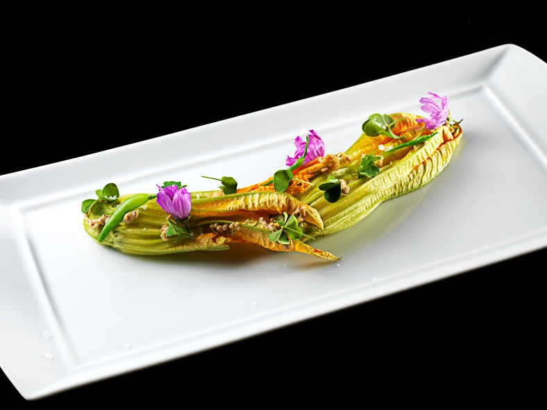 Galleria fotografica






Matteo Rizzo: Funghi porcini al timo
Matteo, il figlio di Elia Rizzo, chef e patron del pluristellato Desco a Verona, telefono +30.045.5953598, ha avuto il grande merito di essersi messo in gioco, forte di una decisone presa alcuni anni fa: nutrirsi in maniera prevalentemente vegetariana. Due piatti ben eseguiti, senza però speciali guizzi creativi in chiave vegana.








Matteo Rizzo: Crema di patate
Bella una frase detta da Matteo Rizzo, trent’anni, al momento di presentare la sua Crema di patate con porro caramellato allo zafferano e sapore di mare (per via dell’erba-ostrica): “Io mi ritengo una ristoratore”. Ecco uno che va oltre il concetto di chef, ormai svuotato da ogni significato e sostanza.








Mario Gagliardi: Dolce, salato, aspro
Ci si aspettava di più da un cuoco in forza al CascinaleNuovo dei fratelli Ferretto a Isola d’Asti nell’Astigiano, telefono +39.0141.958166. Di certo il giovane Mario Gagliardi ha messo nei due piatti la sua terra, andando anche oltre il tema per via del miele d’acacia in questa tavolozza di sapori e colori intitolata Dolce, salato, aspro, amaro in Piemonte. Tante cose, tanta volontà ma anche tanto da limare e correggere.








Mario Gaglardi: Ying e Yang riso e fagioli
Yin e Yang, concetti alti, il nero (yin – e non ying) e il bianco (Yang), la notte e il giorno, il buio e la luce fino a questo piatto di riso nero e fagioli, anche di tofu e di nocciole. Insomma…








Femke van den Heuvel: Roll of asparagus
Donna eccezionale l’olandese Femke van den Heuvel del ristorante Vlam in de pan ad Haarlem, nome scelto con ironia perché in italiano si traduce Fuoco di pagliua quando Femke e la sua cucina sonno tutt’altro che illusioni, fuochi di paglia per l’appunto. Il via con il Roll of asparagus stuffed with hazelnut ricotta, un rotolo di asparagi (fuori) e ricotta lavorata con le nocciole (dentro) che ha fatto un po’ da apripista a altre tre lavorazioni, tutte molto serie e intelligenti. Purtroppo anche poco belle, molto buone di certo.








Femke van den Heuvel: Lava of spring vegetables
Applausi per Femke van den Heuvel anche con Lava, una eruzione di primizie di primavera, erbe aromatiche e alghe. Una tavolozza sulla quale ha disposto i suoi orti, un campionario che ognuno gustava a suo piacimento, stupendosi davanti a tanti ingredienti simili ma mai uguali tra loro. Una curiosità: Femke non usa sale perché in Olanda viene importato. Per salare ricorre, quando serve, all’acqua marina. Coerente. E quei funghi shiitake? Tranquilli: coltivati in Olanda.








Daniela Cicioni: Fermentino
Daniela Cicioni, chef vegana e crudista senza paraocchi, molto curiosa alla cucina nella sua globalità, si impegna a mille per perorare la causa di una golosa e completa alimentazione vegana senza disdegnare la piacevolezza d’insieme di ogni proposta. I due fermentini, simil-formaggi prodotti partendo dalle mandorle, uno fresco e l’altro stagionato starebbe a loro agio nel carrello dei formaggi di ogni locale stellato. Un antipasto da applausi sinceri.








Daniela Cicioni: Cous cous di mais
E con il Cous cous di mais con cagliata di mandorle affumicata, fiori di zucchina essiccata e ortaggi, la Cicioni ha idealmente strappato una standing ovation. Ricetta a base di mais, quindi ideale anche per i celiaci, ha confermato che la cucina vegana può anche essere bella e non solo ottima. Importante una frase che la cuoco lombarda ama ripetere di credere nella creatività, nella passione e nel rispetto, perché "la Creatività è l'Intelligenza che si diverte”. Firmato Albert Einstein, vegetariano nell’ultima parte della sua vita.








Carla Aradelli: Pisarei di pane al farro
Piatto forte della Aradelli i Pisarei e faṡö. Certo non la versione originale piacentina perché i gnocchetti, nella circostanza preparati con farina di farro, passano senza problemi al vaglio vegano, ma la salsa di fagioli si nutre di pancetta. E’ o non è la bandiera di Piacenza? E allora ecco Carla pensare a un condimento di pomodorini, semi di zucca, capperi di Salina e timo. Piatto piacevolissimo.








Carla Aradelli: Bortolina di ceci con zucchine fiorite
Carla Aradelli, chef e titolare con il marito Maurizio Rossi del ristorante Riva a Ponte Dell’Olio in provincia di Piacenza, telefono +39.0523.875193, ha proposto in chiave vegana due classici della sua terra a iniziare dalla Bortolina. Sorta di piadina piuttosto che di testarolo da imbottire con salumi, maiale quindi, è stata ripensata dalla cuoca in chiave ligure in omaggio alle radici del suo compagno. Spazio quindi alla farina di ceci per ricordare la farinata, accompagnata da zucchine fiorite ripiene di melanzane cotte al naturale e tofu. Molto saporita e quindi gradita in maniera paticolare.








Antonia Klugmann: Spinacino selvatico
Antonia Klugmann, triestina, chef del Venissa sull’isola di Mazzorbo a Venezia, telefono +39.041.5272281, ha stupito e stregato con due preparazioni che sono regolarmente in carta, nel menù degustazione. Antonia non ha voluto creare qualcosa di specifico per l’occasione, un piatto da esibizione, per dimostrare che in un ristorante possono coesistere più aspetti, un po’ come per una persona che, pur cambiando d’abito, rimane sempre se stessa. Primo a uscire lo Spinacino selvatico, piantaggine, rose e carcadè, la trasposizione del lavoro nell’orto del ristorante. Essenziale, splendido, dai profumi persistenti.





