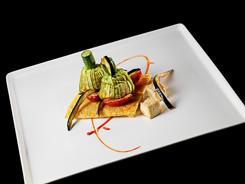 Galleria fotografica






Matteo Rizzo: Funghi porcini al timo
Matteo, il figlio di Elia Rizzo, chef e patron del pluristellato Desco a Verona, telefono +30.045.5953598, ha avuto il grande merito di essersi messo in gioco, forte di una decisone presa alcuni anni fa: nutrirsi in maniera prevalentemente vegetariana. Due piatti ben eseguiti, senza però speciali guizzi creativi in chiave vegana.








Matteo Rizzo: Crema di patate
Bella una frase detta da Matteo Rizzo, trent’anni, al momento di presentare la sua Crema di patate con porro caramellato allo zafferano e sapore di mare (per via dell’erba-ostrica): “Io mi ritengo una ristoratore”. Ecco uno che va oltre il concetto di chef, ormai svuotato da ogni significato e sostanza.








Mario Gagliardi: Dolce, salato, aspro
Ci si aspettava di più da un cuoco in forza al CascinaleNuovo dei fratelli Ferretto a Isola d’Asti nell’Astigiano, telefono +39.0141.958166. Di certo il giovane Mario Gagliardi ha messo nei due piatti la sua terra, andando anche oltre il tema per via del miele d’acacia in questa tavolozza di sapori e colori intitolata Dolce, salato, aspro, amaro in Piemonte. Tante cose, tanta volontà ma anche tanto da limare e correggere.








Mario Gaglardi: Ying e Yang riso e fagioli
Yin e Yang, concetti alti, il nero (yin – e non ying) e il bianco (Yang), la notte e il giorno, il buio e la luce fino a questo piatto di riso nero e fagioli, anche di tofu e di nocciole. Insomma…








Femke van den Heuvel: Roll of asparagus
Donna eccezionale l’olandese Femke van den Heuvel del ristorante Vlam in de pan ad Haarlem, nome scelto con ironia perché in italiano si traduce Fuoco di pagliua quando Femke e la sua cucina sonno tutt’altro che illusioni, fuochi di paglia per l’appunto. Il via con il Roll of asparagus stuffed with hazelnut ricotta, un rotolo di asparagi (fuori) e ricotta lavorata con le nocciole (dentro) che ha fatto un po’ da apripista a altre tre lavorazioni, tutte molto serie e intelligenti. Purtroppo anche poco belle, molto buone di certo.








Femke van den Heuvel: Lava of spring vegetables
Applausi per Femke van den Heuvel anche con Lava, una eruzione di primizie di primavera, erbe aromatiche e alghe. Una tavolozza sulla quale ha disposto i suoi orti, un campionario che ognuno gustava a suo piacimento, stupendosi davanti a tanti ingredienti simili ma mai uguali tra loro. Una curiosità: Femke non usa sale perché in Olanda viene importato. Per salare ricorre, quando serve, all’acqua marina. Coerente. E quei funghi shiitake? Tranquilli: coltivati in Olanda.








Daniela Cicioni: Fermentino
Daniela Cicioni, chef vegana e crudista senza paraocchi, molto curiosa alla cucina nella sua globalità, si impegna a mille per perorare la causa di una golosa e completa alimentazione vegana senza disdegnare la piacevolezza d’insieme di ogni proposta. I due fermentini, simil-formaggi prodotti partendo dalle mandorle, uno fresco e l’altro stagionato starebbe a loro agio nel carrello dei formaggi di ogni locale stellato. Un antipasto da applausi sinceri.








Daniela Cicioni: Cous cous di mais
E con il Cous cous di mais con cagliata di mandorle affumicata, fiori di zucchina essiccata e ortaggi, la Cicioni ha idealmente strappato una standing ovation. Ricetta a base di mais, quindi ideale anche per i celiaci, ha confermato che la cucina vegana può anche essere bella e non solo ottima. Importante una frase che la cuoco lombarda ama ripetere di credere nella creatività, nella passione e nel rispetto, perché "la Creatività è l'Intelligenza che si diverte”. Firmato Albert Einstein, vegetariano nell’ultima parte della sua vita.








Carla Aradelli: Pisarei di pane al farro
Piatto forte della Aradelli i Pisarei e faṡö. Certo non la versione originale piacentina perché i gnocchetti, nella circostanza preparati con farina di farro, passano senza problemi al vaglio vegano, ma la salsa di fagioli si nutre di pancetta. E’ o non è la bandiera di Piacenza? E allora ecco Carla pensare a un condimento di pomodorini, semi di zucca, capperi di Salina e timo. Piatto piacevolissimo.





