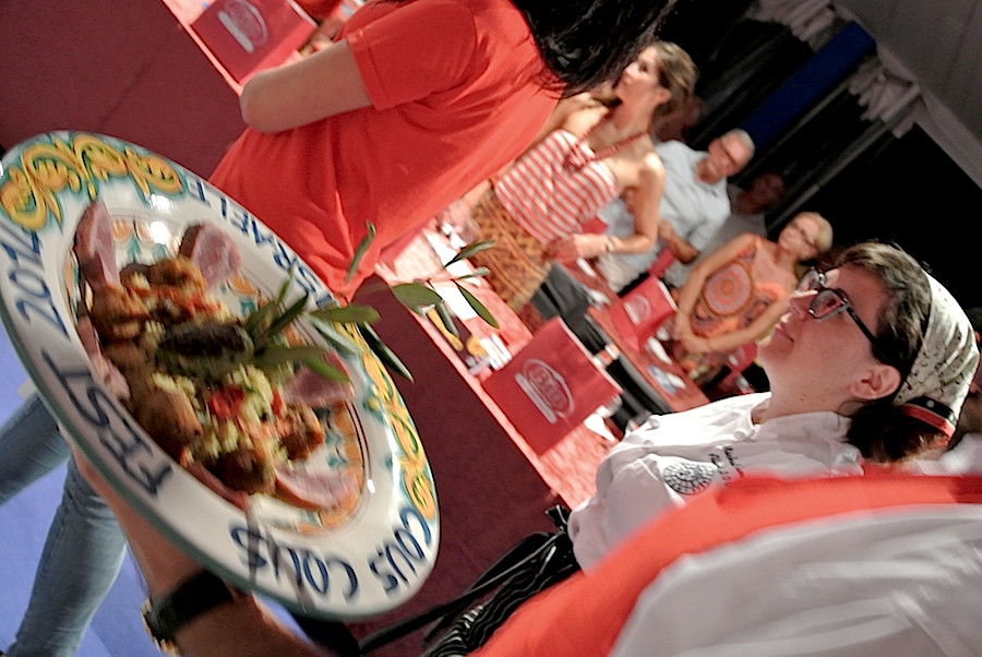 Galleria fotograficaIl cannolo di cous cous di Enrico Panero, del ristorante Da Vinci a Eataly Firenze, usato come evidenziatorePrima nazione in gara al Cous Cous Fest 2014 il Marocco con Majda Nabaoui, cuoca 19enne in forza all'Osteria Francescana a ModenaMajda Nabaoui, in Italia, a Modena, dall'et&agrave; di 9 anni, ha chiamato la sua proposta Da Modena al Marocco passando per la Sicilia, la sua colazione la mattina di sabatoI due concorrenti della Tunisia, entrambi in forza al Taglio a Milano, a destra Domenico della Salandra e al centro Mohamed Mabrouk catturato dalla bellezza della presentatrice Eliana ChiavettaL'Arancino di cous cous grazie al quale la Tunisia &egrave; arrivata alla finale a livello di giuria popolare superando il Marocco per appena un centesimo: 8,92 contro 8,91. Al suo interno scampi freschi. Nota curiosa: visto che eravano nel Trapanese, quindi Sicilia occidentale, sarebbe stato pi&ugrave; corretto chiamare il piatto ArancinaTre giorni di assaggi, tutto nel PalaBia, il tendone ridosso della spiaggia di San Vito Lo Capo. Il cielo ti invitava a mollare tutto e a tuffartiIl Cous Cous dolce, nome concreto del piatto della Francia, delle cuoche Marion Roger (cous chef di Alice Delcourt all'Erba Brusca a Milano) e Chiara Cilio, che hanno proposto un uso insolito del cous cous, in forma dolce, con tanto di gelato alla verbena. Con questo dessert, la Roger ha vinto il premio per l'originalit&agrave; e sfiorato il successo assoluto, centrato dalla Delcourt nel 2011 e 2012Maziar Farivar, radici iraniane e cittadinanza statunitense. Del suo piatto ricorderemo solo un eccessivo e gratuito uso del peperoncino. Doveva essere un cous cous nel segno dello Shrimp Jambalya ma, eliminato il prosciutto affumicato nel timore di imbattersi in musulmani in giuria, tutto &egrave; crollato.Il cous cous americano, un piatto imbarazzante, facile preferirgli quello francese. La giuria popolare ha votato il dessert 8,86 e il cous cous patriottico 7,86 (ma la giuria di esperti &egrave; stata ancora pi&ugrave; severa)Mohamed Mabrouk e Domenico della Salandra per una volta schierati nella giuria popolare