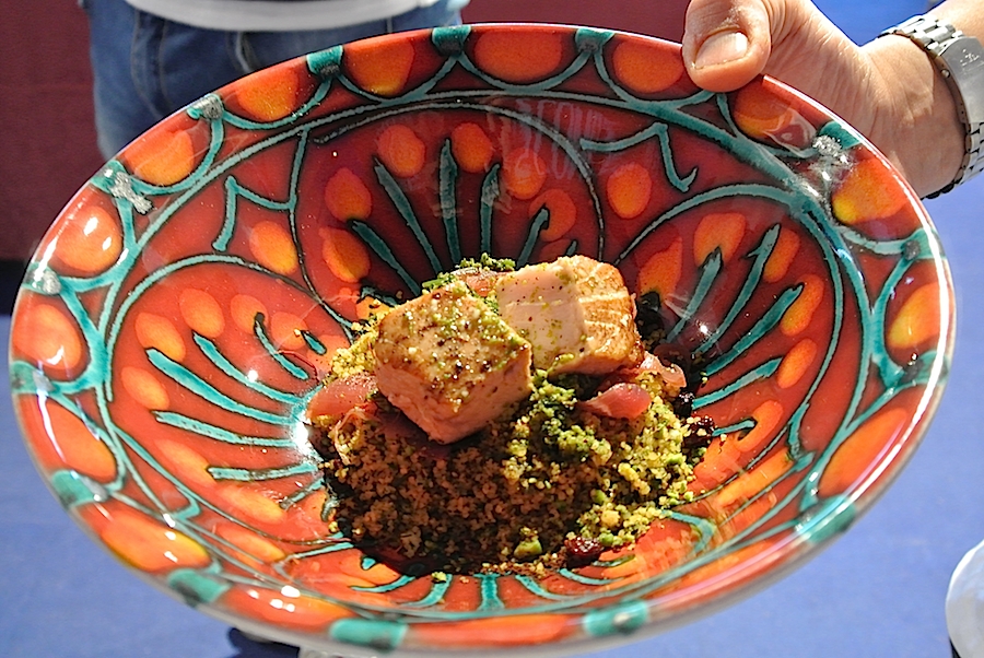Galleria fotograficaIl cannolo di cous cous di Enrico Panero, del ristorante Da Vinci a Eataly Firenze, usato come evidenziatorePrima nazione in gara al Cous Cous Fest 2014 il Marocco con Majda Nabaoui, cuoca 19enne in forza all'Osteria Francescana a ModenaMajda Nabaoui, in Italia, a Modena, dall'et&agrave; di 9 anni, ha chiamato la sua proposta Da Modena al Marocco passando per la Sicilia, la sua colazione la mattina di sabatoI due concorrenti della Tunisia, entrambi in forza al Taglio a Milano, a destra Domenico della Salandra e al centro Mohamed Mabrouk catturato dalla bellezza della presentatrice Eliana ChiavettaL'Arancino di cous cous grazie al quale la Tunisia &egrave; arrivata alla finale a livello di giuria popolare superando il Marocco per appena un centesimo: 8,92 contro 8,91. Al suo interno scampi freschi. Nota curiosa: visto che eravano nel Trapanese, quindi Sicilia occidentale, sarebbe stato pi&ugrave; corretto chiamare il piatto ArancinaTre giorni di assaggi, tutto nel PalaBia, il tendone ridosso della spiaggia di San Vito Lo Capo. Il cielo ti invitava a mollare tutto e a tuffartiIl Cous Cous dolce, nome concreto del piatto della Francia, delle cuoche Marion Roger (cous chef di Alice Delcourt all'Erba Brusca a Milano) e Chiara Cilio, che hanno proposto un uso insolito del cous cous, in forma dolce, con tanto di gelato alla verbena. Con questo dessert, la Roger ha vinto il premio per l'originalit&agrave; e sfiorato il successo assoluto, centrato dalla Delcourt nel 2011 e 2012Maziar Farivar, radici iraniane e cittadinanza statunitense. Del suo piatto ricorderemo solo un eccessivo e gratuito uso del peperoncino. Doveva essere un cous cous nel segno dello Shrimp Jambalya ma, eliminato il prosciutto affumicato nel timore di imbattersi in musulmani in giuria, tutto &egrave; crollato.Il cous cous americano, un piatto imbarazzante, facile preferirgli quello francese. La giuria popolare ha votato il dessert 8,86 e il cous cous patriottico 7,86 (ma la giuria di esperti &egrave; stata ancora pi&ugrave; severa)Mohamed Mabrouk e Domenico della Salandra per una volta schierati nella giuria popolareIsraele in gara contro il Libano grazie a Michael Korenman, tutti presi in contropiede perch&eacute; si aspettavano un Michele, un lui e non una leiMichael Korenman &egrave; stata anche la cuica personale di Oprah Winfrey in America, conduttrice tiv&ugrave; e attrice. Il suo cous cous &egrave; piaciuto pi&ugrave; agli esperti che al pubblico. Ricco di spunti come i falafel, ottimi i singoli pezzi meno l'assemblaggio finale e un attimo inutile il tonno come nota del mare. Il piatto non aveva un nome: "Abbiamo avuto un'estata difficile per via della guerra che proprio non avevo pensato a come chiamarlo. Lo faccio ora e lo chiamo PACE". Applausi scrosciantiNahida Salman, cuoca libanese che dal 2006 vive a Ragusa in Sicilia, tra i suoi parenti anche l'attuale presidente della Repubblica del Libano Michel Suleiman. Il suo cous cous, lo Yakneh Tabule alla carne di agnello, &egrave; stato preferito per due centesimi dalla giuria popolare: 8,57 contro 8,55.Un dettaglio del cous cous libanese, il tabul&egrave; usato dalla chef come ripieno degli involtini di foglie di viteCome per Israele, la partecipazione dei cuochi della Palestina assume sempre un significato che trascende quello gastronomico. A volte ci scappa pure un signor piatto, non &egrave; stata questa la volta ma Hani Kasabra e Odeh Abu El Hawa hanno lo stesso strappato applausi. Se &egrave; stata un'estate pesante per chi vive in Israele, figuriamoci per loro (che, comunque, non arrivano da Gaza bensi da Betlemme). Sono ampiamente scusati se non hanno versato il miele in un cous cous di pollo e verdure in brodo, miele annunciato nel nome stesso della preparazione.Il Cous Cous con pollo e verdure della Palestina. Tanta buona volont&agrave;.Mamma Africa alias Konate Abibata, nativa di Abidjian e a Palermo dal 1994 dove presto avrebbe aperto un'osteria nel quartiere di Santa Chiara per i suoi connazionali ivoriani e via via per sempre pi&ugrave; italiani. Gi&agrave; nonna di sette nipoti, anima una fondazione a favore dei bambini del Burkina Faso, "un Paese ancora pi&ugrave; povero della Costa d'Avorio". Vincitrice due volte del Cous Cous Fest, 2006 e 2008, superata la Palestina per 9,11 contro 8,24, Mamma Africa si &egrave; aggiudicata il premio per la migliore presentazione.Mamma Africa ha chimato il suo cous cous Gli spiedini della nonna, lei ormai nonna e molto attaccata a sua madre. Per&ograve; gli spiedini di manzo non hanno sfilato. La cuoca ivoriana ha usato l'occasione per lanciare un messaggio di pace e di fratellanza tra le nazioni di Africa (la mano nera) e Europa (il fondo bianco) nel segno di un cuoro rosso e vivo. Il cous cous della Costa d'Avorio come &egrave; stato servito alla giuria tencica. Particolarmente scomodo e brutto il bicchiere per il sugo di carne, ma molto funzionale alla riuscita del piatto perch&eacute; uno poteva versarlo subito prima di papparselo. In finale invece Mamma Africa ha preferito, in assenza di bricchetti, versare il sugo prima di servire, ma cos&igrave; il torrino &egrave; risultato asciutto.L'ultimo confronto eliminatorio ha visto in gara l'Italia e l'Eritrea. Primi a uscire in sala i cuochi azzurri, il sanvitese Giuseppe Salmeri, in forza all'hotel Capo San Vito, tutto a sinistra nella foto, e il milanese Andrea Provenzani, chef-patron del Liberty.
