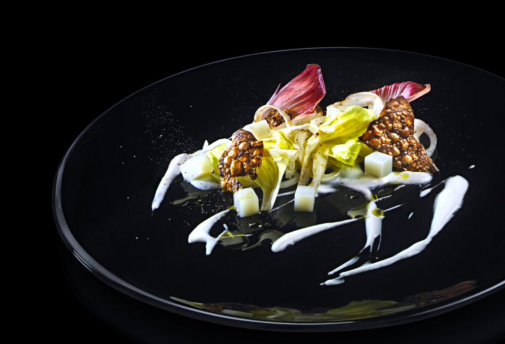 Galleria fotografica






Giorgio Damini, Damini & Affini, Arzignano (Vicenza)

La mia caesar salad - L'idea è sicuramente nata dopo le mie esperienze londinesi, quando ho scoperto come una salsa cambi completamante il gusto dell'insalata. Quindi ho cercato di esaltare tutti gli ingredienti dividendoli uno per uno, senza mescolare nulla, poi un pizzico di macelleria con la carne disidratata al posto del pollo e, dulcis in fundo, il pane di Eugenio Pol









Alessandro Dal Degan, La Tana, Asiago (Vicenza)

Crudo di anatra fiammeggiata, topinambur, foglie di faggio e sorbo dell'uccellatore - E' un piatto che per tonalita amaro-salate e per quelle dei colori è un simbolo della stagione fredda e della monocromia invernale. Un omaggio alla lentezza









Alessio Longhini, Stube Gourmet dell'hotel Europa, Asiago (Vicenza)

Riso carnaroli mantecato alla crema di topinambur, crudo di ricciola, caramello di birra stout, uova di salmone - Piatto che rispecchia le mie esperienze. Raccoglie gusti e consistenze diversi tra loro









Alfio Ghezzi, Locanda Margon, Trento

Non aglio e olio, non cacio e pepe, ma insolito Trentino - Spaghetti Monograno Felicetti, TrentoDoc Ferrari Perlé, Trentingrana e olio extravergine Garda Trentino Dop Uliva... Un piatto che nasce sulla suggestione di Bottura: «...ma siamo proprio sicuri che la tradizione sia rispettosa del territorio?». E che si sviluppa attraverso la tecnica dei due classici, aglio e olio e cacio e pepe, declinati però in chiave trentina









Giuliano Baldessari, Aqua Crua, Barbarano Vicentino (Vicenza)

Mungotto alle capesante, artemisia e argilla - Lo propongo perché offre un punto di vista diverso sul mondo del risotto. Il mungotto è il nome che ho dato al "risotto" fatto con i fagioli mung al posto del riso









Lionello Cera, Antica Osteria Cera, Campagna Lupia (Venezia)

Spaghettino freddo con cavolfiore, champagne rosé, scampo e ostrica - Un piatto che nasce dopo avere cotto il cavolfiore assieme ai gusci delle canocchie. Ho pensato di conferirgli acidità e ho fatto ridurre dello champagne con anice stellato. Poi scampo crudo battuto e un pezzo di ostrica per ricordare il mare in purezza









Nicola Dinato, Feva, Castelfranco Veneto (Treviso)

Risotto al broccolo di Bassano, cannocchie, mandarino, alici - "...with tangerine trees and broccoli skies..". Citiamo, modificandola, una frase del brano Lucy in the Skies with Diamonds, dei Beatles. Proponiamo l'italianità in un primo piatto invernale, che coglie spunti dal territorio limitrofo (il broccolo di Bassano del Grappa, le cannocchie della Laguna di Venezia), ma anche da altrove (i mandarini siciliani, la colatura di alici di Cetara). Il tutto unito da un grande riso, il Principato di Lucedio









Giuseppe D’Aquino, Oseleta, Cavaion Veronese (Verona)

Spaghetti al pomodoro del piennolo, burrata e scorza di limone – Un piatto che nella sua semplicità è diventato il must del ristorante Oseleta. Un piatto per il quale a detta di tanti vale la pena fare il viaggio









Riccardo Gaspari, El Brite de Larieto, Cortina d'Ampezzo (Belluno)

Spaghetto di montagna - Il profumo del bosco sfida la tradizione italiana in un semplice spaghetto aglio e olio









Donato Episcopo, La Corte dell'hotel Villa Abbazia, Follina (Treviso)

Mandorla di Toritto, composta di fichi “paradiso”, spugna all’alloro e gelato moka - Questo dessert nasce da un capriccio di mia mamma che, durante un mio viaggio, decise di mettermi di nascosto, in valigia, un vasetto di fichi secchi. Non so come fece a passare i controlli in aeroporto e comunque quando lo trovai fu una bella sorpresa. Mi ricordo che da ragazzo, quando andavo a casa delle zie o dei nonni, con il caffè offrivano dei fichi secchi con al centro una mandorla e un pezzettino di foglia di alloro (usanza della mia terra, che è il Salento)









Alberto Basso, 3Quarti, Grancona (Vicenza)

Risi e latte, miele, sfere di birra al lampone e ribes - Riso e latte è la tradizione, il cibo povero per eccellenza nelle nostre zone. Siamo partiti quindi da questo e dalla semplicità per sviluppare un dolce inusuale e per certi versi anche un po' estremo. Il riso viene cotto nel latte e mantecato col gorgonzola, per dare un po’ di sapidità, e miele del bosco di Rigoni di Asiago. Lo serviamo con lamponi disidratati, ribes e sfere di birra al lampone









Nicola Portinari, La Peca, Lonigo (Vicenza)

Anguilla in forno di braci con guava e tamarindo - L'anguilla è difficile da affrontare per la clientela a causa della sua grassezza. Quindi la sfida è creare un piatto da consigliare per poi ricevere complimenti e la conseguente voglia di mangiarlo di nuovo. Risulta croccante fuori e morbido dentro, con la guava che con la sua fresca tannicità doma la parte grassa dell'anguilla, mentre il tamarindo addolcisce e rende raffinato e vellutato il suo sapore rustico e leggermente terroso









Leandro Luppi, Vecchia Malcesine, Malcesine (Verona)

Raviolo aperto di spaghetti, lago e zafferano - Un chiaro omaggio al Marchesi del Raviolo aperto e allo Scabin dello spaghetto cotto in sottovuoto. In più, il mio lago









Lorenzo Cogo, El Coq, Marano Vicentino (Vicenza)

Ritorno alla sapidità - Alice sotto sale, rapa, dragoncello, kiwi fermentato, petali di carciofo e umibudo









Piergiorgio Siviero, Lazzaro 1915, Pontelongo (Padova)

Scam-pato verso i colli – Uno scampo di Chioggia tostato in saor, noce salata e tarassaco, chips di topinambur. Risalendo dalle valli di Chioggia lungo il Bacchiglione, il percorso tra storia e identità del mio territorio









Massimiliano Alajmo, Le Calandre, Rubano (Padova)

Mozzarella di mandorle - Una finta mozzarella di pasta cotta di zucchero, miele e albume soffiato come uno zucchero filato, senza l’utilizzo di coloranti o altri elementi artificiali. La ricostruzione olfattiva del piatto rimanda a una vera mozzarella per la presenza dell’acqua, dell’olio extra vergine di oliva, dell’origano e dei canditi vegetali. Ironia e immaginazione per travestire la mandorla e proiettarla in un’altra dimensione, per far riscoprire in pochi istanti una sensazione lattico-tattile-olfattiva e visiva in un dolce che non contiene nemmeno una goccia di latte – foto Bob Noto









Pierchristian Zanotto, Gambrinus, San Polo di Piave (Treviso)

Gamblù – E’ il nostro "blu" vegetale affinato in bacche di uva rabosa bio, sedano rapa e pane al pepe rosa. Seguendo il nostro percorso di cucina etica e responsabile, senza rinunciare alla golosità dei grandi formaggi









Oliver Piras e Alessandra del Favero, Aga dell'hotel Villa Trieste, San Vito di Cadore (Belluno)

Linguine, mirtilli, luppolo e salsiccia di manzo cruda - Abbiamo ricreato con due varietà di mirtilli diverse lo stesso ph del pomodoro e il condimento ricorda il classico sugo alla campidanese delle mie zone d'origine









Fabrizia Meroi, Laite, Sappada (Belluno)

Piatto del Piave - Salmerino leggermente marinato, yogurt alla camomilla di fiume, salsa di patate dolci e olio al crescione, meringhe all'alga spirulina e caramella effervescente.
Il piatto è dedicato al fiume che nasce a Sappada. Nel 2015 ricorreva inoltre il centenario della Prima Guerra Mondiale, evento storico che ha visto protagonista proprio il Piave









Corrado Fasolato, Spinachile Resort, Schio (Vicenza)

Filetto di Triglia con iceberg di ortaggi invernali e moka ai germogli di bosco - È una triglia cotta a bassa temperatura e poi messa su degli iceberg di ortaggi (frullati di verdure sifonati a -40°) e un brodo denso di gallina. Il tutto va irrorato con un’estratto di germogli di piante di bosco profumato con riccioli freschi di legno di castagno. Il calore scioglie gli iceberg e il tutto si trasforma quasi in un passato di verdure









Andrea Stella, Dalla Libera, Sernaglia della Battaglia (Treviso)

Gnocchi di patate soffiati con acciuga di Cetara e puntarelle - Già mia zia Libera circa cinquant'anni preparava ottimi gnocchi; così io ho deciso di riproporli in forma e consistenze nuove. Vengono soffiati in forno, mentre la base viene realizzata con l'acciuga di Cetara che per sua caratteristica è meno salata delle altre. La croccantezza viene data dalle puntarelle









Michele Cella, Basilico Tredici, Treviso

Riso, carbone, baccalà e “saor” - Sono particolarmente legato a questo piatto in quanto è stato premiato come miglior ricetta alla sesta edizione del Festival Triveneto del Baccalà - Trofeo Tagliapietra, vincendo così la manifestazione gastronomica itinerante che quest'anno ha raccolto 28 ristoranti tra Veneto, Friuli Venezia Giulia e Trentino Alto Adige e che rappresenta l’evento simbolo ed esemplare della passione per il baccalà in cui gli chef e le loro brigate si sfidano per ideare “la migliore ricetta innovativa”. Sono particolarmente legato a questo piatto anche perché rappresenta in pieno il mio concetto di cucina, in quanto ci sono prodotti che amo del mio territorio. Rispecchia la mia chiave di lettura della tradizione – foto Tobia Berti









Francesco Brutto, Undicesimo Vineria, Treviso

Riso acido - Si tratta semplicemente di un riso cotto nel succo di melograno fermentato e poi condito con tre polveri: di frutti di bosco, di karkadè e di buccia di chulo key lime bruciato. La cosa interessante per me sono le diverse acidità che lo compongono, nettamente differenti, e tutte riconoscibili: dall'acido-dolce del melograno, all'acido-amaro della polvere di limone. Gli ingredienti sono tutti autoprodotti: il limone è una piantina che mi è stata regalata da un amico di ritorno dalla Florida e che ora sta nel giardino del ristorante; i frutti di bosco sono stati raccolti quest'estate a casa mia, dove mia mamma ha coltivato anche un paio di piante di karkadè; i melograni vengono dal giardino di un nostro cameriere









Alessandro Intini, Nidaba, Montebelluna (Treviso)

Verdure alla griglia, purea di zucca e miso, gel al sakè, cavolo nero, spinacio fritto - Non c'è niente di più semplice del nutrirsi della terra, non c’è niente di più difficile del nutrirsi di essa









Andrea Asoli, Serena Baiano, Michelangelo Doria, Sabina Joksimovic, Venissa, Venezia

Pazzi "a' …mare" - Ruotepazze Benedetto Cavalieri, frutti di mare, acqua di datterini e sabbia di corallo. I frutti di mare cambiano texture, diventano gel e vanno a riempire le ruote che sono mantecate con l’acqua dei molluschi. Un’esplosione di mare in un boccone









Giancarlo Perbellini, Casa Perbellini, Verona

Quaglia affumicata, pomodori confit, carciofi, pistacchi e crema di Grana Padano - Presente nella prima carta del 2016, grande successo del 2015, è il piatto del nuovo corso di Casa Perbellini che ha riscosso lodi da tutta la clientela e che manterremo finché sarà stagione di carciofi









Italo Bassi, Confusion Lounge, Verona

Salmone in guacamole avvolto in carta di riso, con gelatina di ponzu, mandorle tostate, ikurae e leche di tigre al mango - Interpretazione oltre confine di una semplice tartare di salmone. Oriente e Centro America si uniscono in un unico piatto









Matteo Rizzo, Il Desco, Verona

Merluzzo nero e le sue trippe alla parmigiana - Lo propongo per il legame che ha con la storia della mia famiglia. E' espressione delle mie esperienze e idee









Simone Lugoboni, Oste Scuro, Verona

Astice bretone al vapore su crema e chips di topinambur con profumo d'arancio - Piatto stagionale (topinambur e arancio) che rivaluta l'astice bretone o blu (un'altra marcia a confronto col canadese) e che mi ricorda il mio periodo lavorativo trascorso da giovane in Francia









Norbert Niederkofler, St. Hubertus del Rosa Alpina, Badia (Bolzano)

Lumache con radice di prezzemolo, broccolo selvatico e riso venere - L’idea di questo piatto? Slow down a little bit in our life: ci sono tante cose belle da vedere e da vivere, perciò ci dovremmo prendere del tempo per poter apprezzare questi momenti. Il concetto di Cook the Mountain è sempre più forte nel nostro lavoro e ora con l’arrivo di Care's completiamo questo con il lavoro per un domani di sostenibilità, educazione, formazione. Questi sono i pensieri del nostro futuro - foto Daniel Töchterle









Giorgio Schifferegger, Valier dell'hotel Four Points, Bolzano

Polpo, fregola e cren – Ossia il mio polpo vestito di gulash









Federico Belluco, Dopolavoro Dining Room, Venezia

Crudo di ricciola con emulsione di cozze al "gratin" - Questo piatto è nato per richiamare uno dei più grandi classici della cucina marinara italiana, le cozze al gratin dei bacari veneziani. In questa reinterpretazione però, diventano il condimento del nostro crudo. Dalle cozze infatti si ottiene una salsa che fungerà da dressing per la ricciola, sprigionando una serie di sapori marini. Il tutto viene finito con briciole di pane fritto al prezzemolo (in ricordo ancora più accentuato del gratin), salicornia, lattuga di mare e caviale di lime









Alessandro Gilmozzi, El Molin, Cavalese (Trento)

Tosella, sarde di lago, betulla, acetosella e lichene bianco - L’idea è quella di dare valore a un formaggio di primo caglio. Viene sposato con betulla candita, gelato alle sarde di lago e sferificazione di estratto di acetosella. Per finire il lichene bianco, che con i suoi sentori di fungo e di terra dolomitica rende magico l’insieme









Martin Obermarzoner, Jasmin dell'hotel Bischofhof, Chiusa (Bolzano)

Tonno rosso Balfego e torchione di foie gras de canarde - Il mitico piatto dell’ancora più mitica Anne-Sophie Pic. L’ho mangiato da lei e mi è talmente rimasto in mente da volerne pensare un omaggio da parte mia. Dunque quel piatto, reinterpretato da noi









Chris Oberhammer, Tilia, Dobbiaco (Bolzano)

Cervo nostrano affumicato con tortino di polenta e funghi, rape rosse al vino rosso - E' il piatto che mi sta più a cuore, dato che richiama alcune tradizioni della mia zona, l'uso della selvaggina in cucina e l'affumicatura, penso allo speck









Enrico Croatti, Dolomieu del DV Chalet, Madonna di Campiglio (Trento)

Turanici alle canocchie e rosole - Il ricordo dei classici maccheroncini alle canocchie che si mangiano in riviera romagnola... Le rosole, erba selvatica che si usa cruda leggermente marinata con sale e olio per fare i classici cassoni romagnoli... La scoperta del turanico, un grano antico dimenticato... La vera semplicità supportata dall'anima e da una storia gastronomica che non avrà mai fine









Alessandro Bellingeri, Osteria de l'Acquarol, Panchià (Trento)

L’espressione del Temolo: crudo, cotto e marinato - Con questo piatto ho voluto ricreare una grigliata tra i boschi dopo una giornata di pesca









Matteo Metullio, La Siriola del Ciasa Salares, San Cassiano (Bolzano)

Cotechino, scampi, yuzu e pomodori verdi - L’idea nasce dal fatto che da tempo avevo intenzione di mettere un bollito in carta. Essendo da poco passato il Natale, ho pensato al cotechino. Inoltre non è la prima volta che sposo pesce e carne assieme. Li abbino rispettivamente a elementi classici: ecco dunque l'unione fra agrumi e crostacei (scampi e yuzu) e l’altra fra bollito e mostarda (cotechino e mostarda di pomodori verdi)









Gerhard Wieser, Trenkerstube dell'hotel Castel, Tirolo (Bolzano)

Filetto di salmerino con carote nostrane e cerfoglio - E' un piatto tipico della nostra zona. Uso solo le carote nostrane coltivate dal mio contadino preferito e il salmonino dalla Val Passiria









Stefano Ghetta, L Chimpl da Tamion del Gran Mugon, Vigo di Fassa (Trento)

Sedano rapa, Trentingrana e tartufo - Ne vado fiero perché da un prodotto povero come il sedano rapa si può preparare un piatto molto elegante, grazie anche al Trentingrana e al pregiato tartufo









Mario Porcelli, Alpenroyal, Selva di Val Gardena (Bolzano)

Cresta di pasta fresca, coda di bue, porcini, tartufo e carote - La cresta di pasta ha decisamente gusti inconfondibili che, uniti tra loro, suscitano un'esperienza culinaria avvolgente. L'intento è di unire cucina classica a quella moderna, rispettando il brasato (farcitura della pasta) alla crema di carote cotta a bassa temperatura






