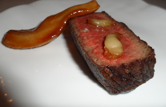 Galleria fotograficaQuello che vedete &egrave; un piatto di pura felicit&agrave;. Una sintesi suprema di minimalismo e complessit&agrave;, profondit&agrave; e nitore. Tomates en salsa, hierbas arom&aacute;ticas y fondo de alcaparras: dunque solo natura, ma che deflagra tra le fauci, assale le papille gustative e sembra lo sciabordio d&rsquo;onde contro lo scoglio, per&ograve; a percuotervi ed avvilupparvi ci pensano deliziosi umori vegetali. Vedete, si tratta di semplici pomodorini, &laquo;sono andato in un orto botanico incredibile, nel centro della Spagna. Ho assaggiato quaranta variet&agrave; di pomodori, un&rsquo;esperienza fantastica&raquo;, spiega lo chef. Al loro interno vengono siringati vari infusi a base di basilico e altre erbe, differenti l&rsquo;uno dall&rsquo;altro, il tutto si adagia su un fondo di consomm&eacute; di capperi. E&rsquo; un piatto-gioco, didascalico, splendido e spettacolare: ogni boccone rivela note diverse, qualcuno spiazza con una leggera affumicatura della polpa, ma ognuno vanta un&rsquo;incredibile potenza aromatica. &laquo;Il miglior piatto di pomodori che abbia mai mangiato&raquo;, secondo Joan Roca, tre stelle Michelin a Girona: c&rsquo;&egrave; la sorpresa delle molteplici declinazioni di sapore (&laquo;Di cosa sa questo?&raquo;, diventa una divertente caccia al gusto), s&rsquo;alternano successivi gradi di dolcezza e acidit&agrave;, fum&eacute; e speziato... E poi le consistenze, lo shot brodoso-sapido, appena tiepido, che scoppia in bocca quando il dente squarcia la tenera superficie polposa... Scoperta assoluta.L&rsquo;autore del piatto appena descritto &egrave; l&rsquo;uomo (uomo o ragazzo? In fondo &egrave; un classe 1978...) che vedete nella foto. Di lui si &egrave; detto: &laquo;Ci troviamo, lo ripetiamo per l&rsquo;ennesima volta, davanti a un GENIO. Ci&ograve; &egrave;, al disopra di qualsiasi altra considerazione, Josean Mart&iacute;nez Alija&raquo;. Ecco, condividiamo totalmente queste parole che il grande critico gastronomico spagnolo Rafael Garc&iacute;a Santos, creatore de Lo mejor de la gastronomia, rivolge nei suoi confronti. Assaggiare i piatti di Alija &egrave; un&rsquo;esperienza folgorante anche per il gourmet pi&ugrave; disincantato. Paul Bocuse: &laquo;Una delle migliori cucine della mia vita&raquo;.Alija ha da poco pi&ugrave; di tre mesi aperto il suo nuovo ristorante, Nerua, che si trova come il precedente all&rsquo;interno dell&rsquo;affascinante complesso disegnato dall&rsquo;archistar statunitense Frank O. Gehry per ospitare le collezioni del Guggenheim, a Bilbao. Lo chef &egrave; nelle cucina del museo fin dalla sua apertura, nel 1997, quando era appena maggiorenne; poco dopo primo responsabile (scelto da Martin Berasategui...). &laquo;Nerua &egrave; il culmine di tredici anni di lavoro durante i quali il ristorante del museo &egrave; stato un punto di riferimento gastronomico per i nostri visitatori. Il piacere estetico dell'edificio si sposta ora in questo nuovo spazio d&rsquo;avanguardia&raquo;, ha commentato Juan Ignacio Vidarte, direttore generale del Guggenheim. Nerua si trova accanto alla sala che ospita The Matter of Time, imponente installazione di Richard Serra, ma ha un ingresso indipendente dalla strada.Il nome Nerua &egrave; un gioco di suoni e parole. Il fiume che scorre a fianco del Guggenheim, a due passi dal ristorante, &egrave; il Nervi&oacute;n, l&rsquo;antico Nerva latino. La lingua euskadi, per&ograve;, non contempla la &ldquo;v&rdquo;, mentre quella latina classica utilizzava la &ldquo;v&rdquo; sia per indicare il relativo suono consonantico che quello vocalico &ldquo;u&rdquo;. Cos&igrave; &ldquo;Nerua&rdquo; &egrave;, nello stesso tempo, termine d&rsquo;echi prettamente baschi (l&rsquo;identit&agrave;), che designa il fiume (il territorio) e rimanda alla storia (la tradizione). Il tutto, per designare una cucina che va a braccetto col futuro.&laquo;Il peggio che pu&ograve; capitare ad un genio &egrave; di essere compreso&raquo;, ironizzava Ennio Flaiano. Su tale base non dovrebbe destar sorpresa - eppure rimaniamo ugualmente attoniti e dubbiosi - apprendere che Nerua non meriti nemmeno una stella, secondo gli immarcescibili ispettori della guida Michelin. Un altro punto di riferimento gastronomico, agli antipodi rispetto al suddetto, quello dei 50Best 2011, non colloca Alija neppure tra i primi cento chef del mondo. Perdona loro, perch&eacute; non sanno quello che fanno (Vangelo di Luca 23,34). P.s.: Identit&agrave; Golose ha premiato Alija come miglior chef straniero fin dal 2009...In una terra ad altissimo concentrato di mostri sacri, da Arzak&nbsp;(nella foto Juan Mari con la figlia Elena) a Subijana, da Aduriz al Berasategui gi&agrave; citato, Josean Mart&iacute;nez Alija - nato a L&eacute;on ma di formazione a sua volta basca - rifugge dalle influenze esterne, non si intruppa, evita i filoni consolidati cos&igrave; come quelli d&rsquo;avanguardia &agrave; la page, va dritto filato per la sua strada senza curarsi degli illustri colleghi suoi vicini. Parrebbe presunzione da enfant prodige, quale lui &egrave; stato fin dall&rsquo;inizio; invece &egrave; totale coerenza e radicalit&agrave;, persino professione d&rsquo;umilt&agrave;, perch&eacute; cos&igrave; si costringe a pedalare duro con le sole proprie gambe e a rimandare, come abbiamo visto, il tempo degli allori pi&ugrave; facili. &laquo;Il genio &egrave; nonconformismo&raquo;, Vladimir Nabokov.&nbsp;La sala del ristorante vanta un design pulito e minimalista, ad imitazione dello stile della cucina, come vedremo. Vi si accede superando l'ingresso principale che si trova vicino al fiume,&nbsp;dopo essere saliti per una scala in pietra; ci si trova nel corridoio col soffitto di titanio, nel quale una parete-cantina di vetro e metallo, trasparente, con le bottiglie in bella vista nelle intercapedini a temperatura controllata, separa dalla zona dei tavoli. Questi sono ricoperti con una tovaglia bianca, solo successivamente vi vengono via via aggiunti tutti gli altri elementi.La cucina si presenta, poco dopo l&rsquo;ingresso, sulla sinistra, completamente aperta e a vista, con spazi differenti a seconda delle temperature di lavoro. Qui Alija accoglie con gentilezza il commensale, prima che inizi la sfilata dei piatti. Tutto l'interno assume le connotazioni di uno spazio&nbsp;neutrale in cui cucina e sala da pranzo si fondono armoniosamente, l&rsquo;una estensione e &ldquo;interpretazione&rdquo; dell&rsquo;altra. Per ottenere tale fusione sono stati utilizzati gli stessi materiali e colori, legno di acero e lamina laccata. &laquo;Era ora, il momento giusto per tuffarsi in una nuova dimensione&raquo;, sussurra Josean.Il primo piatto che vi abbiamo presentato, Tomates en salsa, &egrave; gi&agrave; una sintesi efficace dello stile di Alija. Cos&igrave; come quest&rsquo;altro in foto: Hebras de berenjena asada, &ldquo;makil goxo&rdquo; y yogur de aceite de olivos milenarios, ormai un suo classico. Traduzione: fibre di melanzana, arrostite, vengono ricomposte in una superficie viola e luminosa, con liquirizia (&ldquo;makil goxo&rdquo;) e accompagnate da yogurt d&rsquo;olio d&rsquo;oliva proveniente da olivi millenari (l&rsquo;oliva &egrave; della variet&agrave; Farga). Combinazione indimenticabile, totale rispetto dei sapori, equilibrio perfetto: c&rsquo;&egrave; tutto Alija, nei suoi princ&igrave;pi di fondo. Che sono: innanzi tutto il minimalismo, l&rsquo;essenzialit&agrave;, pochi abbinamenti per avere esiti insieme netti e sfumati, d&rsquo;inarrivabile eleganza; poi la naturaleza (con una &ldquo;z&rdquo; sola, alla spagnola), la passione per le verdure, il lavoro anche sul singolo prodotto vegetale che assume per&ograve; aspetti visivi-tattili-gustativi diversi in funzione degli svariati trattamenti tecnici cui Alija lo sottopone, padroneggiandoli perfettamente. Siamo di fronte a uno chef che plasma la natura, sorta di demiurgo contemporaneo. Pochissimi (Dacosta, i Roca, per rimanere in Spagna...) ci hanno regalato in questi ultimi tempi simili sensazioni.Lo stesso dicasi per quest&rsquo;altra preparazione, di sconcertante immediatezza gustativa: Cebolla blanca "dulce", fondo de bacalao y pimiento verde. C&rsquo;&egrave; gioco visivo: il bulbo &egrave; racchiuso dalla pelle del baccal&agrave;, si offre cos&igrave; l&rsquo;impressione che sia un trancio di quest&rsquo;ultimo: poi le note del fondo di merluzzo alimentano lo stesso corto circuito, costruendo definitivamente l&rsquo;equivoco (verdura o pesce?). Ma &egrave; un calambour visivo e olfattivo che viene subito svelato in bocca, spazzando via ogni finzione e raggelando con la propria radicalit&agrave;: non c&rsquo;&egrave; menzogna, &egrave; pura cipolla bianca. Un rischioso lusso della semplicit&agrave;, piatto borderline che sa colpire mente e cuore. Ecco, anche in un frangente cos&igrave; estremo risuonano le parole con le quali Alija stesso definisce il proprio lavoro: &laquo;Una propuesta gastron&oacute;mica de vanguardia, pero con mucho sentimiento, con mucho coraz&oacute;n&raquo;. Traduzione superflua.&laquo;La cucina in tempo di crisi&raquo;: pelle di baccal&agrave; e lische di alici, rese una sorta di chips croccanti e magari accompagnate con fl&ucirc;te di champagne, sono un appetizer piacevole ma capace &ndash; oltretutto &ndash; di richiamare l&rsquo;elemento ittico che ispira lo stesso Gehry nella progettazione dell&rsquo;edificio: le 30mila lamine di titanio che lo ricoprono assomigliano alle squame di un pesce... (Ma queste forme non ricordano anche Gaud&igrave;?).&laquo;Per la prima volta la carta riunisce il lavoro degli ultimi anni e tende a umanizzarsi, con proposte meno di rottura&raquo;, scrive ancora Garc&iacute;a Santos riferendosi al menu di Nerua. Umano e divino nello stesso tempo, diremmo, certo non di rottura ma di splendido piacere gourmand, &egrave; ad esempio il Foie gras asado en parrilla, zanahorias y "makil goxo", dove gli altri elementi del piatto (carote, liquirizia...) son solo comparse o persino figuranti, perch&eacute; predomina un solo vero protagonista: il trancio di fegato grasso dalla superficie sublime, croccante e tostata, con piacevoli note aromatiche. Proposta di minor complessit&agrave; ma che si riassume facilmente, perfetta innanzi tutto nella sua intima natura: uno dei migliori foie gras che si possano mangiare al mondo.Il menu degustazione pi&ugrave; ampio, che abbiamo ordinato (otto portate a 83 euro, altri 35 euro per l&rsquo;abbinamento vini: rapporto qualit&agrave;/prezzo encomiabile) non prevedeva il foie gras di cui abbiamo appena parlato (lo abbiamo voluto inserire noi, troppo celebre per non assaggiarlo: e mai scelta fu pi&ugrave; opportuna), mentre propone: Foie vegetal (aguacate), jugo de chipirones, acidulado y cilantro (nella foto), sublimazione dell&rsquo;originale, con le sue stesse consistenze e propriet&agrave; organolettiche. L&rsquo;avocado, cotto al vapore delle sue foglie (dalle quali si ottiene precedentemente un fumetto cui s&rsquo;aggiunge fumetto di grongo), viene accompagnato da un brodo di calamari, acidulato e speziato al coriandolo. Curiosit&agrave;: lo chef italiano Matteo Torretta ne ha elaborato una versione simile, con piselli cotti e crudi, scorza di limone e la classica salsa P&eacute;rigeux.