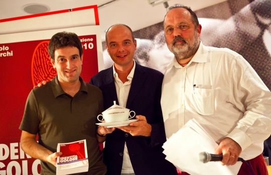 Galleria fotograficaQuello che vedete &egrave; un piatto di pura felicit&agrave;. Una sintesi suprema di minimalismo e complessit&agrave;, profondit&agrave; e nitore. Tomates en salsa, hierbas arom&aacute;ticas y fondo de alcaparras: dunque solo natura, ma che deflagra tra le fauci, assale le papille gustative e sembra lo sciabordio d&rsquo;onde contro lo scoglio, per&ograve; a percuotervi ed avvilupparvi ci pensano deliziosi umori vegetali. Vedete, si tratta di semplici pomodorini, &laquo;sono andato in un orto botanico incredibile, nel centro della Spagna. Ho assaggiato quaranta variet&agrave; di pomodori, un&rsquo;esperienza fantastica&raquo;, spiega lo chef. Al loro interno vengono siringati vari infusi a base di basilico e altre erbe, differenti l&rsquo;uno dall&rsquo;altro, il tutto si adagia su un fondo di consomm&eacute; di capperi. E&rsquo; un piatto-gioco, didascalico, splendido e spettacolare: ogni boccone rivela note diverse, qualcuno spiazza con una leggera affumicatura della polpa, ma ognuno vanta un&rsquo;incredibile potenza aromatica. &laquo;Il miglior piatto di pomodori che abbia mai mangiato&raquo;, secondo Joan Roca, tre stelle Michelin a Girona: c&rsquo;&egrave; la sorpresa delle molteplici declinazioni di sapore (&laquo;Di cosa sa questo?&raquo;, diventa una divertente caccia al gusto), s&rsquo;alternano successivi gradi di dolcezza e acidit&agrave;, fum&eacute; e speziato... E poi le consistenze, lo shot brodoso-sapido, appena tiepido, che scoppia in bocca quando il dente squarcia la tenera superficie polposa... Scoperta assoluta.L&rsquo;autore del piatto appena descritto &egrave; l&rsquo;uomo (uomo o ragazzo? In fondo &egrave; un classe 1978...) che vedete nella foto. Di lui si &egrave; detto: &laquo;Ci troviamo, lo ripetiamo per l&rsquo;ennesima volta, davanti a un GENIO. Ci&ograve; &egrave;, al disopra di qualsiasi altra considerazione, Josean Mart&iacute;nez Alija&raquo;. Ecco, condividiamo totalmente queste parole che il grande critico gastronomico spagnolo Rafael Garc&iacute;a Santos, creatore de Lo mejor de la gastronomia, rivolge nei suoi confronti. Assaggiare i piatti di Alija &egrave; un&rsquo;esperienza folgorante anche per il gourmet pi&ugrave; disincantato. Paul Bocuse: &laquo;Una delle migliori cucine della mia vita&raquo;.Alija ha da poco pi&ugrave; di tre mesi aperto il suo nuovo ristorante, Nerua, che si trova come il precedente all&rsquo;interno dell&rsquo;affascinante complesso disegnato dall&rsquo;archistar statunitense Frank O. Gehry per ospitare le collezioni del Guggenheim, a Bilbao. Lo chef &egrave; nelle cucina del museo fin dalla sua apertura, nel 1997, quando era appena maggiorenne; poco dopo primo responsabile (scelto da Martin Berasategui...). &laquo;Nerua &egrave; il culmine di tredici anni di lavoro durante i quali il ristorante del museo &egrave; stato un punto di riferimento gastronomico per i nostri visitatori. Il piacere estetico dell'edificio si sposta ora in questo nuovo spazio d&rsquo;avanguardia&raquo;, ha commentato Juan Ignacio Vidarte, direttore generale del Guggenheim. Nerua si trova accanto alla sala che ospita The Matter of Time, imponente installazione di Richard Serra, ma ha un ingresso indipendente dalla strada.Il nome Nerua &egrave; un gioco di suoni e parole. Il fiume che scorre a fianco del Guggenheim, a due passi dal ristorante, &egrave; il Nervi&oacute;n, l&rsquo;antico Nerva latino. La lingua euskadi, per&ograve;, non contempla la &ldquo;v&rdquo;, mentre quella latina classica utilizzava la &ldquo;v&rdquo; sia per indicare il relativo suono consonantico che quello vocalico &ldquo;u&rdquo;. Cos&igrave; &ldquo;Nerua&rdquo; &egrave;, nello stesso tempo, termine d&rsquo;echi prettamente baschi (l&rsquo;identit&agrave;), che designa il fiume (il territorio) e rimanda alla storia (la tradizione). Il tutto, per designare una cucina che va a braccetto col futuro.