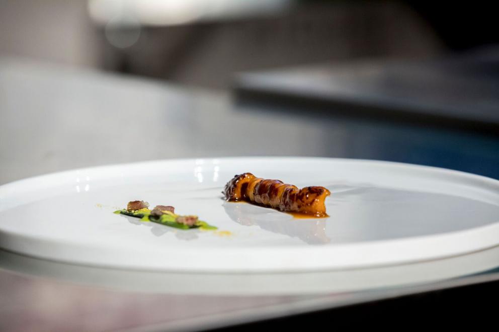 Galleria fotografica






ALFIO GHEZZI – Microclima: la distanza che accomuna - Fedele a se stesso e al titolo della sua lezione Alfio Ghezzi ha presentato la Tartiflette alla mia maniera, «una rivisitazione del frico, del rosti e della tartiflette; ma ho trovuto preparazioni simili anche in Norvegia», spiega. Per la sua tartiflette utilizza crema di patate, mortandela e un formaggio di pasta ottenuto dalla fermentazione di polvere di pasta precedentemente cotta in acqua per 50’ a 96° e poi essiccata in forno per un’intera notte









L’ingrediente principale del secondo piatto è lo yak della Val d’Ambiez, discendente dai buoi tibetani portati in Italia da Reinhold Messner, di cui Ghezzi ha impiattato la carne affiancandola a un crostino di pane di segale con lardo dello stesso yak, polvere di trombette nere, paprika affumicata, e - servito in tazza - a un brodo di carne di yak caramellata con miele e erbe









RICCARDO GASPARI con OLIVER PIRAS e ALESSANDRA DEL FAVERO Il “trip” del latte -Nell’agriturismo El Brite de Larieto l’alta cucina di Gaspari si sposa con le materie prime dell’allevamento di famiglia









Il salame di piedino di maiale con la sorpresa di un cubetto di lingua al suo interno cui fanno da cornice una gustosa di crema di siero di latte e nocciole tostate, sovrastato da una granita di mela (che dà una nota unica al piatto) e fiori di rosmarino è la summa dell’enunciato che nessuna materia è povera quando la si lavora a dovere. Il piedino di maiale è cotto nel latte, disossato e lavorato come un salame, da conservare al freddo «perché tende a spezzarsi». Il tocco finale è dato dal crumble di porcini e dalla rapa marinata









Bastano venti minuti per spostarsi da El Brite all’Aga di Oliver Piras e Alessandra Del Favero, ma l’ispirazione della cucina di Piras (sardo adottato dal Cadore in cui è stato spinto dall’amore) e Del Favero, coppia in cucina e nella vita, è diversa. Si capisce subito dal tiramisù, che di fatto non lo è pur ricordandone i sapori, ispirato da un loro viaggio in Giappone e dalla scoperta del koji, fungo utilizzato per la fermentazione della soja e del riso per fare miso e sake. Il dolce di Oliver e Alessandra ha una base di polenta di orzo di Belluno (presìdio Slow Food) fermentato e bruciato, è aromatizzato con infusione di radici di cicoria e completato da gelato di koji fatto con latte di El Brite









MAURIZIO GRANGE E PIERGIORGIO PELLEREI - I piatti della nostra tradizione visti con gli occhi della contemporaneità - Si può viaggiare anche rivisitando la tradizione. È un viaggio nel tempo quello di Maurizio Grange e Piergiorgio Pellerei fanno fare al piedino di maiale









Rosolato intero con sedano, carote e cipolle e poi cotto in un fondo di vitello per 2/3 ore prima di venire disossato, il piedino diventa con i carciofi il ripieno per il raviolone saltato al burro alle erbe. La presentazione è su una salsa di cavolfiori e zenzero deliziosamente piccante









ANTONIO BIAFORA E NINO ROSSI - Transumanza: istinto ancestrale di sopravvivenza - Biafora e Rossi hanno dato al tema del viaggio un significato diverso: per i due calabresi è un percorso per la sopravvivenza. Quello degli uomini che in Calabria si spostavano con le loro bestie dalla montagna al mare e viceversa in quella transumanza corta che ha contaminato i sapori






