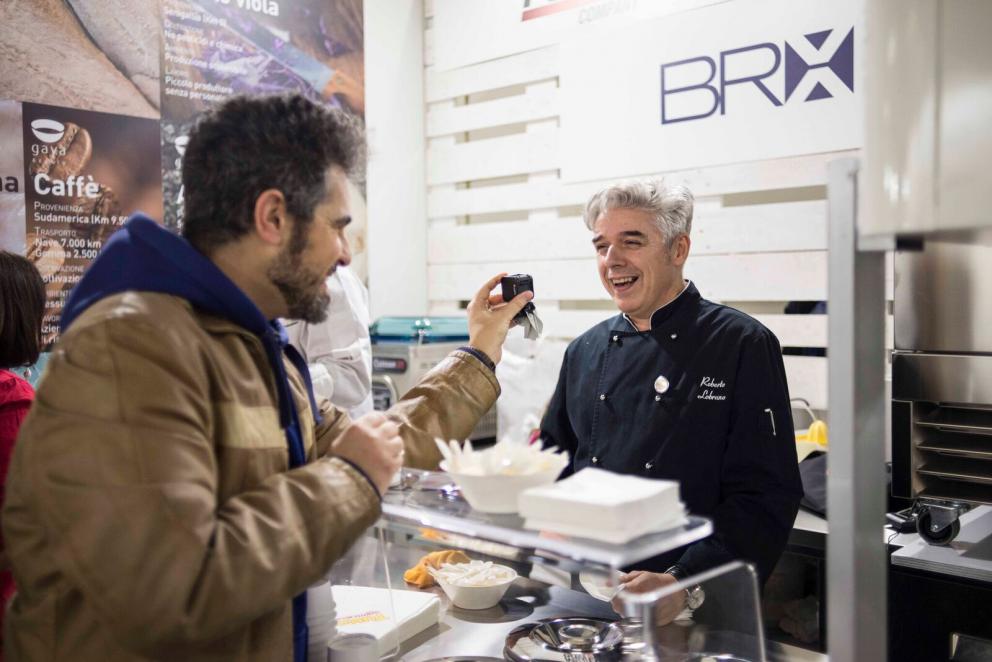 Galleria fotografica






Il viaggio nel mondo di Grana Padano è iniziato il primo giorno di congresso con due degustazioni orizzontali tenute dal Consorzio di Tutela ed è terminato con lo chef Andrea Ribaldone e i suoi sfiziosissimi finger food. La domenica Matteo Baronetto (nella foto con gli GnamBox ed Elisabetta Serraiotto, responsabile Marketing di Grana Padano) ha preparato originali tapas ideate per l'occasione, mentre per la giornata di chiusura il maestro Franco Pepe ci ha regalato la sua personale interpretazione della pizza fritta con il Grana Padano









Durante la pausa lavori, dalle 13 alle 15, lo spazio S.Pellegrino ha offerto ai visitatori del congresso la degustazione di un piatto d’autore: il sabato di Paolo Griffa e Alessandro Rapisarda (nella foto), finalisti rispettivamente della prima e della seconda edizione di S.Pellegrino Young Chef, la domenica un dolce di Loretta Fanella e lunedì il piatto Carciofo&Carciofo di Cristina Bowerman. Domenica alla tavola rotonda Coltivare il talento gli chef Cristina Bowerman, Caterina Ceraudo, Loretta Fanella, Anthony Genovese, Davide Oldani, Ciccio Sultano, Paolo Griffa e Alessandro Rapisarda hanno raccontato storie di successo tra maestri e allievi. E poi è stata da non perdere la specialissima Experience Box...









Giovanni Pellegrino, Alberto Basso e Giuseppe Lo Iudice (nella foto), giovani talenti del Premio Birra Moretti Grand Cru, hanno proposto le loro creazioni ideate in abbinamento con Birra Moretti Grand Cru, rispettivamente: Beer Donuts con Birra Moretti La Bianca, Pancia di maiale iberico, luppolo e Birra Moretti Grand Cru e Anatra alla Birra Moretti Lunga Maturazione, anche in abbinamento









Le miscele iTierra! Origins, in cui si coniugano eccellenza del prodotto, rispetto per l’ambiente e attenzione al sociale e la special edition di “Kafa”, uno dei caffè più pregiati al mondo che nasce nella foresta etiope, sono stati i  protagonisti dello spazio espositivo Lavazza, che ha ospitato un ’esperienza sensoriale con esclusivi aperitivi di food pairing firmati dallo chef Cesare Battisti e dal bartender Dennis Zoppi. A stupire i visitatori l’esclusiva auto “stellata” Smart Forfood, primo ristorante su quattro ruote nato dalla collaborazione tra Lavazza, Mercedes-Benz Italia, Michelin, Focaccia Group e Medici Style, sotto la direzione creativa di Davide Oldani (foto)









Allo stand di Vino Libero & Compagnia, il gruppo Fontanafredda (nella foto, Andrea Farinetti) ci ha raccontato la biodiversità agroalimentare italiana con un viaggio di degustazioni attraverso l’Italia del vino, tra le regioni più importanti del panorama enologico italiano, dal Piemonte fino alla Sicilia









Dopo 4 anni dalla prima edizione è tornato Bread Religion nello spazio Petra Molino Quaglia. Cuochi, pizzaioli, pasticcieri e panettieri hanno accompagnato gli ospiti del congresso lungo un viaggio di profumi e sapori che parte dal grano. Pagnotte da affettare, ciabatte alveolate, focacce salate e dolci lievitati, panini morbidi o con la crosta, impasti di lievito madre con farine Petra macinate a pietra o biologiche, con e senza glutine: queste le forme del pane che i professionisti ospiti hanno farcito per interpretare la loro idea del “viaggio”









Le Cantine Ferrari hanno scelto Identità Golose per continuare il percorso di approfondimento sull’Arte dell’Ospitalità avviato lo scorso anno con The World’s 50 Best Restaurants. Il tema dell’accoglienza, molto sentito da Ferrari che da anni si impegna a valorizzare l’importante ruolo della sala, è stato raccontato sul palcoscenico dell’Auditorium alla scoperta degli elementi che rendono indimenticabile l’esperienza gastronomica. Nella giornata di lunedì lo spazio Ferrari ha offerto degustazioni di Riserve Trentodoc: Perlè, Perlè Bianco, Perlè Nero e Perlè Rosè, abbinati alle creazioni di Alfio Ghezzi, del ristorante Locanda Margon di proprietà della famiglia Lunelli (nella foto, Matteo Lunelli a Identità Milano)









Regione Lombardia ha presentato i suoi prodotti agroalimentari di qualità, un’ampia rappresentanza che si colloca ai primi posti a livello nazionale: 34 prodotti Dop e Igp, 249 prodotti tradizionali di valenza storica, 41 vini tra Docg, Doc e Igt. Allo stand di Regione Lombardia si sono alternati produttori della Valtellina, del territorio comasco e dell’Oltrepò Pavese con degustazioni dei migliori prodotti e vini locali









Il Pastificio Felicetti ha fatto viaggiare la pasta coinvolgendo tre grandi chef al Monograno Diner: Carlo Cracco (nella foto, con Paolo Lopriore) ha presentato un piatto di pasta in chiave italiana, Giorgio Nava ha proposto una cucina sudafricana e Luca Fantin una ricetta ispirata ai sapori del Giappone. Un viaggio tra i sapori del profondo sud e dell’estremo oriente che parte da casa, dall’Italia. Ogni giorno si sono alternati ai fornelli tre giovani cuochi italiani: Lucia Tellone, Sara Preceruti e Antonio Colombo, per interpretare il nuovo nato in casa Felicetti: Il Valentino, lo spaghettone dalle dimensioni più generose









Si è aperto con un omaggio a Iginio Massari (nella foto) l’importante programma dedicato alla pasticceria d'autore che ha visto Valrhona protagonista al congresso. Dossier Dessert è stata l’occasione per osservare il mondo delle pasticcerie secondo la prospettiva internazionale che caratterizza l’approccio di Valrhona, da sempre impegnata a valorizzare l’innovazione e la creatività ponendo al centro il lavoro di tanti giovani professionisti









Alce Nero ha accolto il tema del viaggio costruendo un percorso che parla di materie prime biologiche e di luoghi in cui vengono coltivate. I visitatori hanno incontrato sapori e territori attraverso quattro diverse degustazioni di 12 prodotti, scandite ogni giorno al ritmo di colazione con yogurt, miele e frollini, pranzo con pasta, riso e cereali, merenda con cioccolato, composte di frutta e succhi e aperitivi con olio extravergine di oliva, pomodori e nettari di frutta









Lo spazio espositivo di Autogrill ha ricostruito Bistrot, l’innovativo concept realizzato in collaborazione con l’Università degli Studi di Scienze Gastronomiche di Pollenzo per valorizzare i prodotti tipici e il recupero delle pratiche artigianali. Per accompagnare i visitatori in un immaginario “viaggio lungo un giorno” è stato ricreato un “open-lab” dove riflettere sui nuovi trend del food, attraverso i vari momenti della giornata









«Identità di Champagne è l’appuntamento imperdibile per scoprire il prestigio della più antica Maison de Champagne» ha affermato Andrea Pasqua (nella foto), senior brand manager di Ruinart in Italia. Quest’anno il protagonista è Ruinart Rosé, l’espressione golosa del gusto Ruinart, un elegante connubio tra lo Chardonnay e il Pinot Noir. Le creazioni enoiche dello chef de caves Frédéric Panaiotis hanno mostrato la versatilità dell’abbinamento tra l’alta gastronomia e le bollicine francesi con tre degustazioni giornaliere nel Ruinart Lounge









Berto’s, partner ufficiale per la realizzazione di tutti gli impianti di cottura, ha presentato La Cucina, una nuova divisione su misura che esalta i valori dell’unicità. Vera protagonista sul palcoscenico dell’Auditorium, La Cucina è uno strumento unico, disegnato e realizzato in esclusiva. Allo stand Berto’s si sono alternati cooking show di Paolo Cappuccio, Nicola Dinato e Alessandro Borghese. «Le nostre cucine viaggiano in più di 90 paesi da oltre 40 anni – ha spiegato Enrico Berto - La contaminazione con le altre culture e gli altri mondi è stata fondamentale per portare l’azienda a sviluppare il prodotto che abbiamo presentato a Identità Golose»









Besser Vacuum ci ha illustrato tecniche di cottura sottovuoto e cooking show con degustazioni degli chef Paolo Cappuccio (nella foto) e Marco Marras, assieme alla presentazione del libro dello chef Cappuccio Carne e Foie Gras – Tecniche di cottura e design del piatto, un manuale-ricettario sulle cotture sottovuoto









Anche quest'anno continua la collaborazione con Bragard che ha vestito gli chef con la nuova giacca Grand Chef, che affianca alla versione classica in cotone Piuma Premium il modello Allure in cotone nanotecnologia, novità presentata al congresso assieme alla linea Premium Alain Ducasse By Bragard, nata dalla collaborazione con lo chef tristellato Alain Ducasse









Alessandro Guidi e Cristina Franceschetti vestono con Caraiba le tavole dei migliori ristoranti italiani dal 1993. I loro prestigiosi articoli sono stati utilizzati dagli chef per la presentazione dei piatti sui palchi delle sale del congresso, ma anche per tutti i premi dell'edizione 2017









Chs Group ha confermato la partnership con Comatec, azienda francese leader nella progettazione e realizzazione di articoli monouso di altissima qualità. Al congresso ha presentato una gamma allargata di creazioni all’avanguardia, tra cui un rivoluzionario sacchettino con cannuccia pensato per i cocktail dei locali delle grandi città dove vigono ordinanze sul vetro e contro l’inquinamento









Nello spazio di Coldline Living abbiamo scoperto Life, l’abbattitore multifunzione per la casa. I numerosi workshop presso lo stand hanno sottolineato l’efficacia delle 8 funzioni e degli oltre 100 programmi di Life. In tutte le sale e nelle cucine della manifestazione gli chef hanno lavorato con Vision, la più moderna tecnologia multiclimatica che offre ai professionisti la possibilità di controllare tutte le variabili che influiscono sulla qualità della conservazione degli alimenti









Essent’ial è un marchio emiliano che produce complementi d’arredo caratterizzati dal design originale e dall’utilizzo di materiali riciclati, come la fibra di cellulosa e il cartone Fsc. L’azienda ha fornito a Identità Golose pouf e poltrone che hanno arredato l’area lounge, oltre allo spazio Identità di Cocktail e i sacchetti porta pane, fil-rouge presente in tutti gli stand. Al Tuler, tagliere in cartone Fsc, ha accompagnato le preparazioni degli chef durante le lezioni









Il cubetto Hoshizaki "Crescent", unico a poter essere utilizzato nei secchielli del vino senza aggiunta d'acqua, ha avuto il palcoscenico più adatto a dimostrare le sue caratteristiche di durata, brillantezza e fluidità nell'accogliere bottiglie di vino e spumante/champagne, “a secco”. Non sono mancati il cubetto a sei lati e spigoli vivi, il vero "cubetto" Hoshizaki, come anche la forma a sfera e lo "shot glass", che in Hoshizaki prende una straordinaria lucentezza e trasparenza, utilizzati in veste di aperitivi di pregio, come caviale e salmone









Host Milano si è raccontata a Identità come la manifestazione di riferimento nel panorama mondiale dell’equipment, coffee and food, nonché il leader assoluto nei settori Ho.Re.Ca., foodservice, retail, Gdo e hotellerie. Circa 2000 aziende da 47 Paesi propongono macchine, attrezzature, prodotti e servizi innovativi e di qualità a 150mila operatori da 172 Paesi. Oltre al business, sono 400 gli appuntamenti tra cooking show e momenti di formazione. Host Milano è a fieramilano dal 20 al 24 ottobre 2017, con la seconda edizione di Identità Future in collaborazione con Identità Golose









Con i suoi piccoli elettrodomestici, KitchenAid ha supportato il talento e la passione degli chef di Identità Golose ma anche di tutti gli appassionati di cucina che desiderano raggiungere a casa gli stessi risultati di alto livello. Prestazioni professionali, alta qualità manifatturiera e design iconico da sempre contraddistinguono il marchio









A Identità Golose, Tutto Pannocarta di Lucart Group è stato un alleato prezioso per le attività degli chef impegnati sui palchi. L’innovativo rotolo in carta per la cucina ha caratteristiche funzionali di fortissimo impatto che ruotano intorno alla tecnologia della carta a secco






