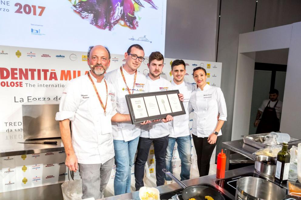 Galleria fotografica






Cinque cartoline balneari. Il primo in ordine cronologico è stato quell’Angelo Sabatelli (nella foto, con l'autore dell'articolo, Andrea Cuomo, ndr) dell’omonimo ristorante che, lasciata Monopoli, sta per riaprire a Putignano









Sabatelli riapre l’album delle fotografie delle sue esperienze in Estremo Oriente (Giakarta, Hong Kong, Shanghai) e avvia l’aggiornamento del programma con tre citazioni pugliorientali: un Allievo di seppia con mandorle e limone (nella foto), un’Incrapiata di fame e cicoria con ostrica tiepida e tonno secco e un Gambero di Santo Spirito, capesante secche e mandorle tostate. Levate l’ancora, si salpi chi può









Due chef hanno lavorato sull’idea di “carnificare” il pesce senza tradirlo, al massimo traducendolo. Il primo è stato Tony Lo Coco, esordiente sul palco di Identità









Lo chef siciliano de I Pupi di Bagheria (Palermo), autodidatta con lo sguardo acceso da una furia feconda, interpreta due piatti della tradizione palermitana: gli anelletti al forno, che lui mette in fila come soldatini a formare dei cannolini schierati su una base rettangolare di ragù di tonno; e la stigghiola, uno spiedino dello street food siculo, in cui all’agnello sostituisce il tonno rosso









Più sussiegoso il viaggio per mare di Paolo Casagrande, lo chef veneto che primo tra tutti ha portato le tre stelle a Barcellona, nel Lasarte che fa parte della collezione di ristoranti mozzafiato di Martìn Berasategui









Con un italiano ormai intinto nello spagnolo Casagrande disegna un’Ostrica tiepida leggermente marinata con granita di shiso verde e pastinaca, avvolta in una schiuma di mare e Champagne (l’assaggio seduce la platea) e una Ventresca di tonno rosso, lime kaffir, crescione e kalamansi al finocchio in crudo e piment d’Espelette (foto). Un tragitto impegnativo solo il nome






