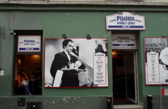 Galleria fotograficaQuest&rsquo;uomo dagli occhi intelligenti e il sorriso bonario si chiama Adam Chrząstowski ed &egrave; il profeta della Nowe kuchni polskiej, la nuova cucina polacca, secondo una sua stessa definizione. Quarantatreenne di Varsavia, da quattro anni ha aperto il suo ristorante Ancora (all&rsquo;italiana, con l&rsquo;accento sulla prima &ldquo;a&rdquo;. Come a dire: di nuovo) a Cracovia, seconda citt&agrave; della Polonia, ma da sempre principale centro culturale, artistico e universitario del Paese.Krak&oacute;w &egrave; una bella citt&agrave;, con un nucleo storico (Stare Miasto) ricco di attrattive anche perch&eacute; quasi del tutto immune dalle distruzioni della seconda guerra mondiale, che hanno invece martoriato, ad esempio, Varsavia o Breslavia. Per secoli &egrave; stata residenza dei re polacchi &ndash; &egrave; tuttora Pantheon della nazione &ndash; poi terza citt&agrave; dell&rsquo;impero asburgico dopo Vienna e Budapest, sempre animata da una vivace vita commerciale, ci si trova all&rsquo;intersezione tra l&rsquo;antica via dell&rsquo;ambra, tra Carpazi e Baltico, e quella Est-Ovest che da Kiev conduce a Praga. Anche per queste molteplici influenze, dal punto di vista architettonico vanta un armonioso sovrapporsi di stili: romanico, gotico, rinascimentale (di diretta derivazione italiana, anche grazie a Bona Sforza, figlia di Gian Galeazzo, andata sposa a Sigismondo I Jagellone e dunque diventata regina), barocco... Nella foto, Rynek Głowny, ossia la pi&ugrave; grande piazza medioevale d&rsquo;Europa, cuore della citt&agrave;, con sulla sinistra la Sukiennice, gotico mercato dei tessuti, e a destra la Kości&oacute;ł Mariacki, chiesa dedicata a Maria.L&rsquo;intensit&agrave; della vita sociale cracovienne si &egrave; sempre riscontrata anche in cucina, ma i decenni sotto l&rsquo;ombrello sovietico hanno prodotto una cesura che solo ora, faticosamente, si sta cercando di ricucire. L&rsquo;isolamento &egrave; durato troppo per non pesare ancora e fa s&igrave; che in citt&agrave; furoreggino i ristoranti &ldquo;d&rsquo;importazione&rdquo; &ndash; italiani in primis &ndash; di qualit&agrave; spesso discutibile: oggi tutto ci&ograve; che &egrave; (pi&ugrave; o meno) esotico attira, dal momento che fino all&rsquo;altro ieri era vietato... L&rsquo;alta cucina &egrave; tendenzialmente d&rsquo;ispirazione francese e/o internazionale (ma senza alcun particolare acuto), mentre della tradizione polacca viene recuperata solo l&rsquo;anima popolare, non particolarmente raffinata: da qui la messe di trattorie &ldquo;tipiche&rdquo; spesso acchiappa-turisti, con menu che richiedono dosi massicce finali di Alka Seltzer. E&rsquo; un trionfo di aringhe, żurek (una zuppa d&rsquo;orzo da sempre assai utile per tamponare i sintomi post-sbornia), gołąbki (involtini di cavolo ripieni), barszcz (versione locale del borsch russo), gli onnipresenti pierogi (ravioli quadrati), per finire con gran piatti di carne arrosto, stufata, grigliata... Nella foto: spiedini, spezzatino e patate in vendita a un chiosco in centro citt&agrave;.Proprio a modificare questo andazzo punta Adam Chrząstowski col suo Ancora (nella foto). Capofila di un &ndash; ancora esiguo - gruppo di colleghi sparsi per il Paese, vuole recuperare anche la tradizione polacca nobile, nel senso letterale del termine (ci si rif&agrave; alle pietanze delle tavole aristocratiche), del tutto dimenticata sotto la cappa comunista. Dunque a Cracovia innovazione significa ora, innanzi tutto, riannodare i fili di una storia gourmand che pareva essersi persa per sempre (la Polonia, ad esempio, &egrave; leader nell&rsquo;allevamento di oche, ma poi solo il 5% di quella carne prelibata viene consumato in loco, fresco o lavorato; il mar Baltico offre a sua volta prodotti straordinari, per&ograve; gran parte del pescato finisce in Scandinavia...); in secondo luogo, significa andare alla ricerca dei tanti piccoli produttori d&rsquo;eccellenza sparsi sul grande territorio, sostenendone l&rsquo;attivit&agrave; e diffondendo una cultura slow food; infine, vuol anche dire applicare a tali materie prime e alle ricette d&rsquo;antan qualche tecnica contemporanea, stando per&ograve; attenti a non epater les bourgeois, che son di casa (la cultura borghese &egrave; storicamente cos&igrave; forte da queste parti, che la citt&agrave; risultava assai invisa ai dirigenti del defunto regime; fecero cos&igrave; costruire una sorta di Cracovia 2, ammasso periferico di acciaierie e inquinamento, proprio per innestarvi un&rsquo;anima proletaria, seppur posticcia).Non siamo quindi certamente al molecolare, l&rsquo;avanguardia &egrave; altrove: la nuova cucina polacca si sostanzia in portate che prevedono perlopi&ugrave; materie prime di qualit&agrave;, del territorio, assemblate recuperando ricette dell&rsquo;alta cucina locale (con qualche spunto creativo) ma in modo da risultare alleggerite, modernizzate e con un impiatto elegante. Per dire: la preparazione di uno simil-zabaione con frutti di bosco sostituisce al marsala un liquore polacco al miele; il (delizioso) sorbetto a met&agrave; pasto &egrave; a base di cetriolo affogato nella Zubrowka, la pregevole &ldquo;vodka all&rsquo;erba del bisonte&rdquo;, aromatizzata cio&egrave; con queste erbette brucate dagli ultimi bisonti europei che pascolano nelle lande semi-disabitate ai confini con la Bielorussia. Chrząstowski non rinuncia mai al sapore, le preparazioni sono d&rsquo;immediata soddisfazione, a rischio di perdere un poco d&rsquo;eleganza. Ma mai in piacevolezza. Menu degustazione di sette portate a 190 złoty, ossia circa 45 euro. Nella foto (invero un po&rsquo; scura, ci scuserete), il Filetto di cervo in crosta di funghi di bosco, con funghi e zucchine: carne portentosa, cotta in modo encomiabile, il miglior cervo che abbia mai mangiato.Molto buona anche la crema di gambero, con gamberetti e pane tostato al formaggio bianco. E da ricordare il piatto nella foto, una sorta di millefoglie dove strati di filetti di triglia si alternano alla pasta delle nostre chiacchiere carnascialesche (tradizione gastronomica dolce che esiste anche da queste parti), presentata in versione salata e fritta &ldquo;easy&rdquo;, il tutto a galleggiare su un mare di splendida salsa alla vaniglia e zafferano. Davvero squisito.In primo piano una zapiekanka, piatto sacro di studenti squattrinati e nottambuli d&rsquo;ogni et&agrave;. Trattasi dello street food per eccellenza di Cracovia, l&rsquo;epicentro del cui consumo &egrave; nell&rsquo;antico quartiere ebraico di Kazimierz, appena a Sud di Stare Miasto: dopo decenni di abbandono sta rinascendo, &egrave; ricco di localini ed &egrave; ora piacevole meta serale della giovent&ugrave; (autoctona o di passaggio) in cerca di divertimento. Al centro della Plac Nowy (piazza Nuova) c&rsquo;&egrave; l&rsquo;Okrqglak (la Rotonda), un edificio con tante finestre da ognuna delle quali s&rsquo;affaccia un diverso venditore di zapiekanki. E&rsquo; in sostanza una mezza baguette, tagliata per il lungo, spalmata di burro od olio e poi riccamente condita con formaggi, salumi, verdure, pat&eacute; o quant&rsquo;altro, con tocco finale di maionese, o salsa tartara, o salsa all&rsquo;aglio... Il tutto viene infine tostato al momento. Tante finestre nella Rotonda, dicevamo, ma cercate quella giusta, perch&eacute; il principe della zapiekanka &egrave; Endzior: davanti a questa gloriosa insegna noi abbiamo addentato la zapiekanka agli spinaci, che sono in crema e accompagnati da salsa tartara: gustosissima, anche se davvero inadatta a chi non ama l&rsquo;aglio. Nella foto, un altro nostro assaggio (si fa per dire: sono fette enormi!), la zapiekanka con salame e formaggio Pucok (sotto gli strati salsicciosi si nascondono anche dei funghi): una vera bomba capace di calmare i morsi della fame almeno per tre generazioni. Il tutto costa tra i 5 e i 10 złoty (ossia comunque meno di 3 euro) a seconda del condimento