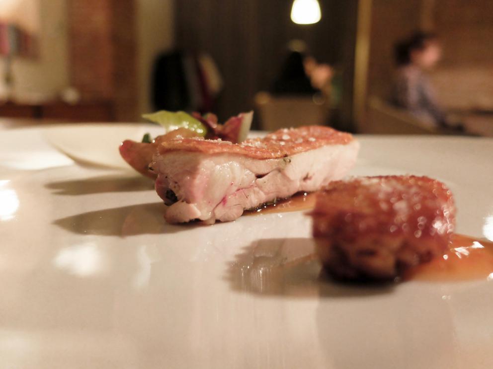 Galleria fotografica






La nostra cena negli scatti di Tanio Liotta. Conosciamo chi produce il pane, è la cooperativa Pausa Cafè, lo impastano i detenuti di una delle due prigioni di Alessandria, quella di San Michele. Ne avevamo parlato qui: Il buon pane dei cattivi. Poi ci sono anche grissini home made e taralli artigianali di Vincenzo Fiore









Bonbon di cinghiale, polvere di barbabietola, ketchup di barbabietola rossa









Buonissimi i Tacos di wafer, guacamole e maionese alla paprika affumicata









Patata pietrificata, maionese di zafferano e i suoi fiori









Finto pomodorino su pane verde all'acciuga









S'inizia il pasto vero e proprio: qui Pescato del Mediterraneo crudo e cotto incontra l'Oriente, ossia gambero rosso di Mazara, ricciola, cipolla rossa di Breme, gel della stessa, peperoncino fresco, riso selvaggio soffiato, latte di cocco, lemon grass, zenzero, acqua di cottura delle cozze. Piatto molto intrigante, spinge su sentori dolci e aromatici/speziati. A parte sono serviti dei calamaretti spillo fritti con paprika affumicata: un po' troppo sale









Uovo bio, carciofo, caviale di trota, Casanova: l'uovo è de La Montagnola, azienda agricola di Riccardo e Gabriele Nicora a Bocco, frazione di Brallo di Pregola (Pv), zona a cavallo tra la bassa valle Staffora e la valle del Trebbia, «da loro mi rifornisco anche di uno splendido zafferano», spiega Sgorbini. È in doppia panatura di pane e panko, poi una fonduta di Casanova (formaggio prodotto dal Caseificio Cavanna sempre in valle Staffora, a pasta molle da latte vaccino intero pastorizzato), un po' dello stesso Casanova a tocchetti, il gambo del carciofo cotto a bassa temperatura e uova di trota. Piatto molto buono, fondente









Deliziosa l'Animella, panna acida al pepe di Timut, daikon e lamponi. L'animella è fritta e poi spolverata di polvere di lamponi, il daikon in infusione di acetosella rossa, poi fondo di cottura di vitello. Perfetto il bilanciamento degli aromi e delle texture: acido/grasso, dolce/piccante, morbido/croccante









Divertente - anche come presentazione - la reinterpretazione di un classico oltrepadano: Ravioli al brasato, cialde di Grana Padano, bieta, jus di vitello









Risotto ai quattro formaggi dell'Oltrepò Pavese. Il riso Riserva San Massimo ha alla base una crema di pere, è mantecato con extravergine e poco burro, e un po' di limone. I formaggi sono liquidi nelle ampolline in fondo, e di altissima qualità, e ognuno richiama una diversa percezione di gusto: stafforella del Caseificio Cavanna per l'acido (è un formaggio vaccino a pasta molle): il Latte & Co di Marco Bernini per l'amaro (erborinato vaccino annegato in salamoia di roquefort e pistacchio di Bronte. Di Bernini abbiamo parlato qui: In viaggio dal casaro-alchimista); il Quadro a pasta fiorita de Il Boscasso (formaggio di capra a latte crudo, stagionato 40 giorni) per il sapido; Grana Padano Dop 20 mesi dell'azienda agrigola Garbelli per l'umami. Da versare a piacere; il dolce, come detto, è già nella crema di pere. Anche in questo caso, piatto molto intrigante









Grissini bolliti Milano (un omaggio ai due maestri), che poi sarebbero Bartolini (i suoi famosi grissini bolliti) e Ribaldone (lo Spaghetto Milano, ne abbiamo parlato qui: uno spaghettone Monograno Felicetti mantecato con un risotto alla milanese stracotto, mantecato con Grana Padano e burro, poi frullato per ottenere una crema di riso allo zafferano). In questo caso Sgorbini unisce le due idee, aggiunge midollo ghiacciato grattugiato e gremolada









Piatto favoloso, quello che vale il viaggio: Diaframma, ostrica, insalatina, arancia. Pulito, essenziale, ricco, equilibrato. Il diaframma è cotto a bassa temperatura a 55°, poi affumicato e finito alla piastra: magnifico. Viene condito con una salsa di ostriche frullate con la loro acqua ed extravergine; a stemperare lo scontro ferroso-iodato arriva la parte vegetale, con le note dolci e acide dell'arancia che si ritrovano anche nel fondo bruno aromatizzato









Come side dish, un'Ostrica con salsa ponzu. Elegantissima






