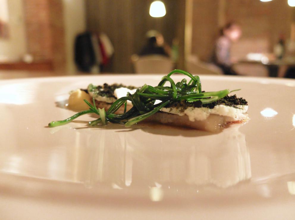 Galleria fotografica






La nostra cena negli scatti di Tanio Liotta. Conosciamo chi produce il pane, è la cooperativa Pausa Cafè, lo impastano i detenuti di una delle due prigioni di Alessandria, quella di San Michele. Ne avevamo parlato qui: Il buon pane dei cattivi. Poi ci sono anche grissini home made e taralli artigianali di Vincenzo Fiore









Bonbon di cinghiale, polvere di barbabietola, ketchup di barbabietola rossa









Buonissimi i Tacos di wafer, guacamole e maionese alla paprika affumicata









Patata pietrificata, maionese di zafferano e i suoi fiori









Finto pomodorino su pane verde all'acciuga









S'inizia il pasto vero e proprio: qui Pescato del Mediterraneo crudo e cotto incontra l'Oriente, ossia gambero rosso di Mazara, ricciola, cipolla rossa di Breme, gel della stessa, peperoncino fresco, riso selvaggio soffiato, latte di cocco, lemon grass, zenzero, acqua di cottura delle cozze. Piatto molto intrigante, spinge su sentori dolci e aromatici/speziati. A parte sono serviti dei calamaretti spillo fritti con paprika affumicata: un po' troppo sale









Uovo bio, carciofo, caviale di trota, Casanova: l'uovo è de La Montagnola, azienda agricola di Riccardo e Gabriele Nicora a Bocco, frazione di Brallo di Pregola (Pv), zona a cavallo tra la bassa valle Staffora e la valle del Trebbia, «da loro mi rifornisco anche di uno splendido zafferano», spiega Sgorbini. È in doppia panatura di pane e panko, poi una fonduta di Casanova (formaggio prodotto dal Caseificio Cavanna sempre in valle Staffora, a pasta molle da latte vaccino intero pastorizzato), un po' dello stesso Casanova a tocchetti, il gambo del carciofo cotto a bassa temperatura e uova di trota. Piatto molto buono, fondente









Deliziosa l'Animella, panna acida al pepe di Timut, daikon e lamponi. L'animella è fritta e poi spolverata di polvere di lamponi, il daikon in infusione di acetosella rossa, poi fondo di cottura di vitello. Perfetto il bilanciamento degli aromi e delle texture: acido/grasso, dolce/piccante, morbido/croccante









Divertente - anche come presentazione - la reinterpretazione di un classico oltrepadano: Ravioli al brasato, cialde di Grana Padano, bieta, jus di vitello









Risotto ai quattro formaggi dell'Oltrepò Pavese. Il riso Riserva San Massimo ha alla base una crema di pere, è mantecato con extravergine e poco burro, e un po' di limone. I formaggi sono liquidi nelle ampolline in fondo, e di altissima qualità, e ognuno richiama una diversa percezione di gusto: stafforella del Caseificio Cavanna per l'acido (è un formaggio vaccino a pasta molle): il Latte & Co di Marco Bernini per l'amaro (erborinato vaccino annegato in salamoia di roquefort e pistacchio di Bronte. Di Bernini abbiamo parlato qui: In viaggio dal casaro-alchimista); il Quadro a pasta fiorita de Il Boscasso (formaggio di capra a latte crudo, stagionato 40 giorni) per il sapido; Grana Padano Dop 20 mesi dell'azienda agrigola Garbelli per l'umami. Da versare a piacere; il dolce, come detto, è già nella crema di pere. Anche in questo caso, piatto molto intrigante









Grissini bolliti Milano (un omaggio ai due maestri), che poi sarebbero Bartolini (i suoi famosi grissini bolliti) e Ribaldone (lo Spaghetto Milano, ne abbiamo parlato qui: uno spaghettone Monograno Felicetti mantecato con un risotto alla milanese stracotto, mantecato con Grana Padano e burro, poi frullato per ottenere una crema di riso allo zafferano). In questo caso Sgorbini unisce le due idee, aggiunge midollo ghiacciato grattugiato e gremolada









Piatto favoloso, quello che vale il viaggio: Diaframma, ostrica, insalatina, arancia. Pulito, essenziale, ricco, equilibrato. Il diaframma è cotto a bassa temperatura a 55°, poi affumicato e finito alla piastra: magnifico. Viene condito con una salsa di ostriche frullate con la loro acqua ed extravergine; a stemperare lo scontro ferroso-iodato arriva la parte vegetale, con le note dolci e acide dell'arancia che si ritrovano anche nel fondo bruno aromatizzato









Come side dish, un'Ostrica con salsa ponzu. Elegantissima









Pollo ficatum, limone, pomelo, cicorie: di nuovo una cottura a bassa temperatura, in questo caso del petto del pollo, mentre la coscetta è panata e fritta. Poi salsa agropiccante di pomelo, insalatina di cicorie, maionese al limone senza uova






